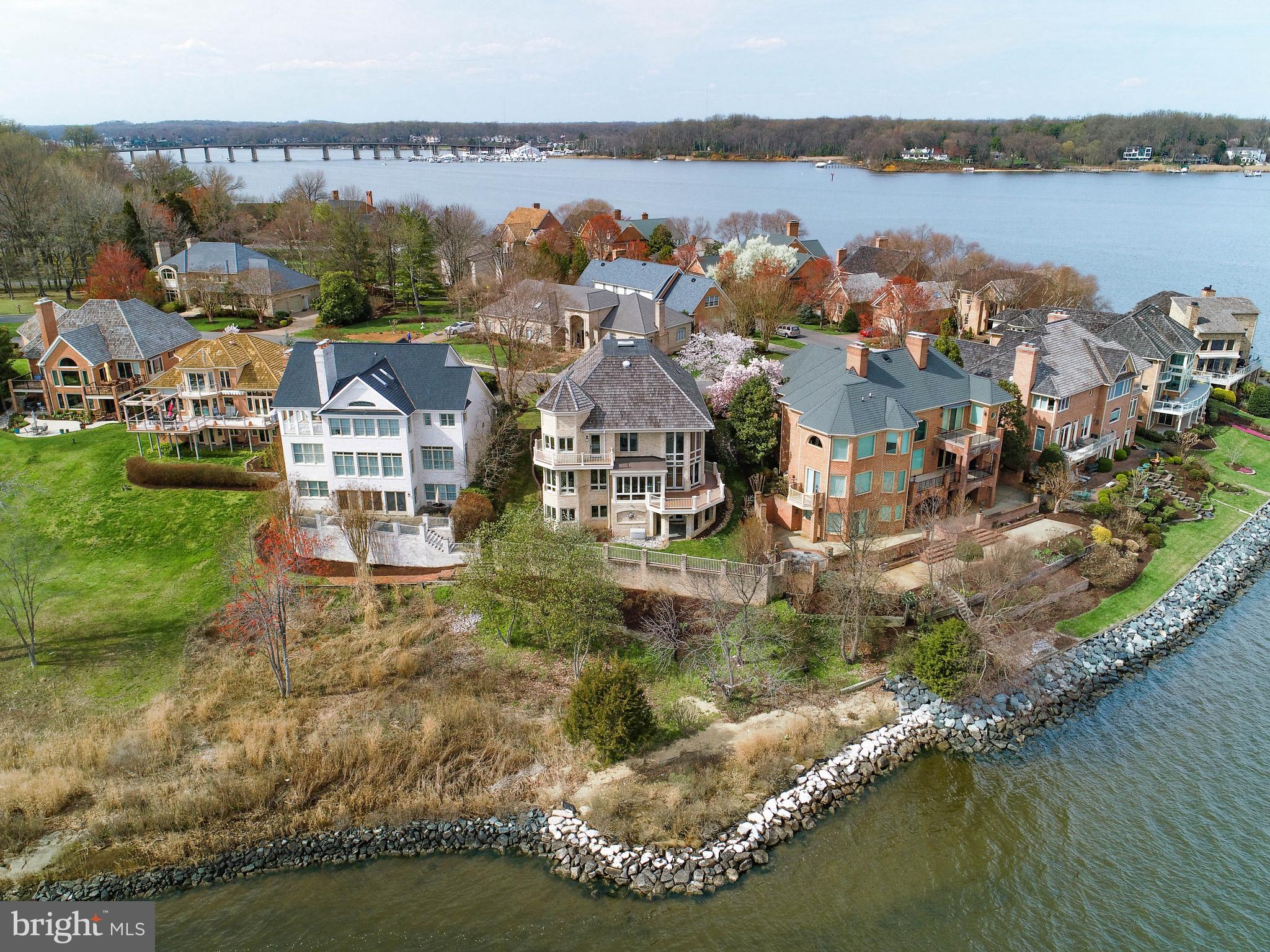 Experience resort-style living in this distinctive home sited on the South River, with peninsula views capturing the Chesapeake Bay and Almshouse Creek. An extraordinary and comprehensive remodel and reconfiguration of space was completed in 2015 with a European influence and high-quality fixtures and finishes throughout. The main level was completely opened and transformed, to include a floating staircase, and resulted in larger social and dining spaces. The Great Room showcases a vast ceiling, 2-story views, gas fireplace and 3 atrium doors to a waterside deck.  A new Chefs Kitchen features leathered granite counters, generous custom cabinetry, Sub Zero, Viking and Bosch appliances plus a 6- burner WOLF gas range. The newly incorporated four-season Sunroom, which is fully open to the Great Room, created views that were not previously available.  A main level en suite bedroom was remodeled and a new powder room added. The upper level balcony overlooking the Great Room optimizes captivating water views.  The Owners Suite was reconfigured to include a larger walk-in California Closet, a chic new Luxury Bath and private deck with birds eye views. The 3rd level attic was also redone, adding a large bedroom/bonus room, as well as creating extensive insulated storage. The lower level central hallway was opened for a new floating staircase, and the existing space was reconfigured to allow for more finished spaces including a waterside Gym, wet bar and Family Room while preserving ample storage space. The flooring throughout is a combination of natural maple and hand-made rustic Mexican Saltillo tile.  All windows and all glass doors are Kolbe & Kolbe.  The cedar shake roof was replaced in 2014. Mechanical components include 2-zone HVAC with 2 high-efficiency Carrier heat pumps (2013), 2 water heaters, a high-end dual flush water treatment system, Kohler generator, irrigation system, central vac, upgraded security system and new whole-house intercom system. The community association provides your lawn mowing, mulching, trimming and snow removal while also maintaining the marina, pool, tennis, playground, nature path and 24/7/365 staffed gated security.