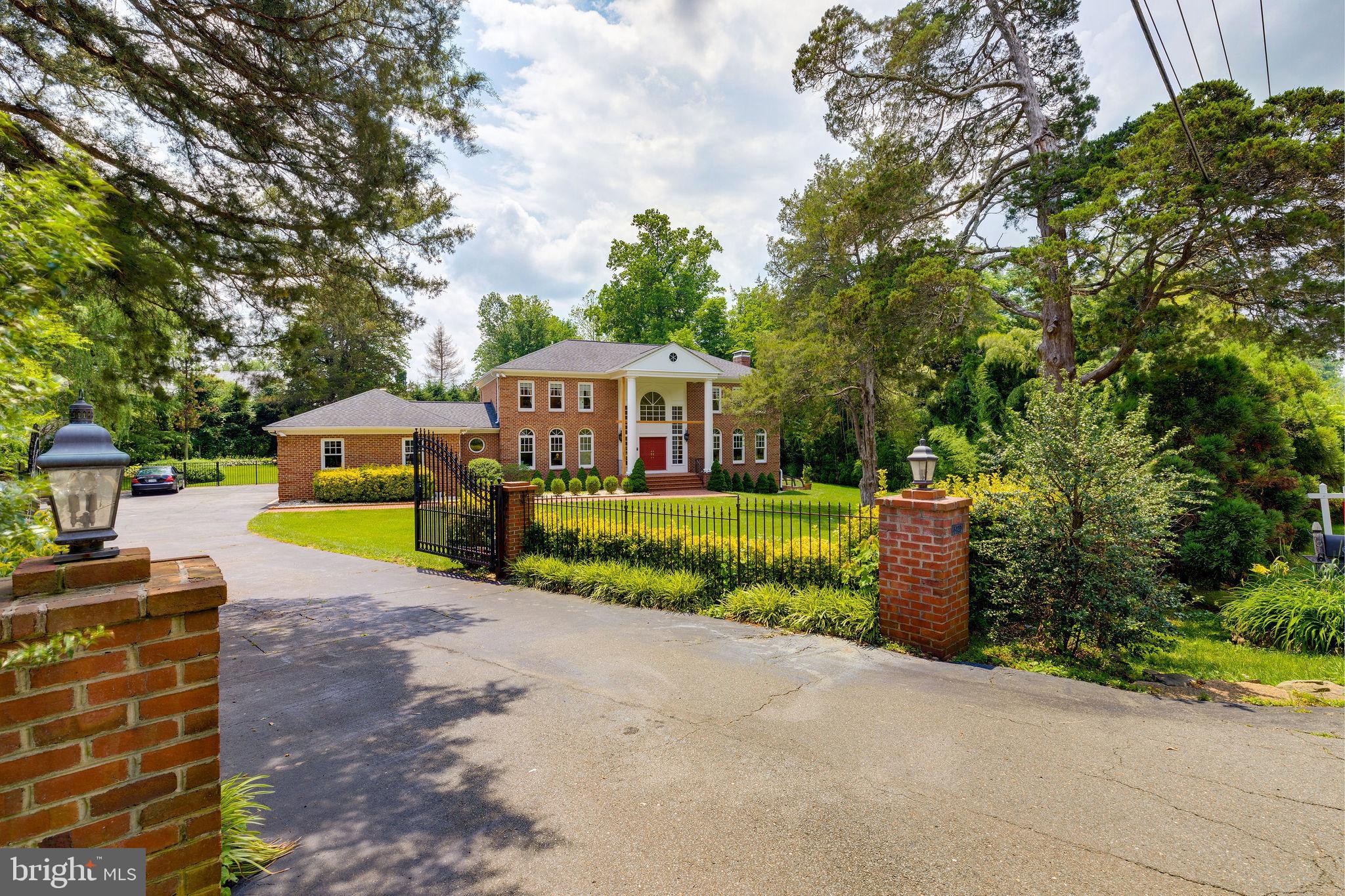 Verdant landscaping, iron entrance gates and fence with brick pillars create a bastion of privacy, protection, and curb appeal for this grand colonial on a .73 acre parcel located on a uniquely desirable location along Georgetown Pike. Approximately 6,820 square foot, 3 level all brick Colonial with 5 bedrooms, 4 full, 1 half bath and a 2-car garage with extra storage. A relatively new landscaped brick walkway leads to a large brick porch with new columns (being installed now). Gracious 2- story marble entrance foyer bathed in natural light from a palladium window and tall sidelights, 9-Foot + ceilings, large windows, natural light and quality detailing are prevalent throughout the house. The library has custom built bookshelves, cabinetry, moldings, and a wet bar. Embassy sized rooms include a grand living room with gleaming hardwood floors, nearly floor-to-ceiling windows, a wood burning fireplace with marble hearth and surround, mantle, crown moldings and a tasteful chandelier. Serene pool, patio and backyard views command attention through glass French doors in the 3-sided extended formal dining room. There you will find an elegant chandelier, chair and crown moldings and hardwood floors. The French country gourmet kitchen updates include new granite countertops and backsplash (2012), stainless steel appliances, custom cabinetry, recessed lights, pendant lights over the island with seating, and new porcelain floor (2015) and (2015). It is open to a large breakfast area with large windows. The family room has hardwood floors, vaulted ceilings, recessed lights, skylights, brick fireplace and flanked on both sides with 2 sets of French doors leading to the backyard. There is a patio, pool and spa (both renovated in 2016.) There are 4 upper level bedrooms with hardwood floors and three full baths. The spacious master suite has two closets, one of which is a walk-in with built in shelves and drawers. The stone tiled master bath features a double ended freestanding tub with wall mounted hand shower and faucets, a large double sink vanity, and separate shower. Three other upper level bedrooms are spacious and share 2 full bathrooms. The finished lower level features an expansive recreation room with a wood burning fireplace, double doors and a walkout stair to the side yard, a bedroom, full bath, a spare room with closet storage, and utility room. The Certainteed Premium asphalt shingle roof was replaced in 2012 and has a 50 year warranty.  The house is on public sewer and water with ejector pumps, lines and control box just replaced in 2020. 80-gallon hot water heater.  Please see the complete list of significant improvements.  2 sets of patio furniture convey. 1 Large cast aluminum set with table and 10 chairs, Sunbrella cushions, cushion storage bin and umbrella. The other is a table and 4 chairs.  2 patio pool lounge chairs. 2nd Refrigerator in garage. Mobile storage shelving on wheels in the garage and the basement utility room convey.  All other furniture is available for purchase separately. See virtual tour https://my.matterport.com/show/?m=BDE9XPcHmHU and Youtube https://youtu.be/fxVK43w1h8Y . Please bring your own masks, gloves and booties (or remove your shoes). Prior to entering the house, please put your masks, gloves and booties.
