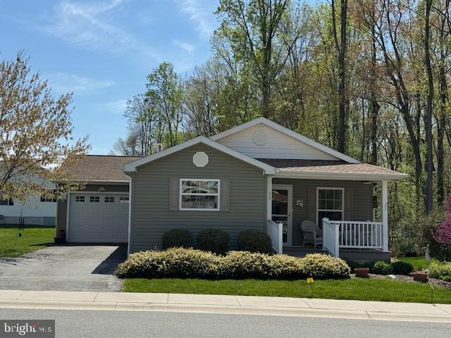 Wonderful move-in ready opportunity! Located on a quiet cul de sac, 2 bedroom, 2 full bath "Kingsley Model" manufactured home offering 1,588 sq. ft. of open and airy living space and located in the desirable 55+ community of Cecil Woods, with close proximity to Rt. 40, I-95, Harford County and the shops and restaurants of the quaint and historical town of North East, MD. Highlights include striking LVP flooring in the main living area, which features a spacious living room, formal dining, sitting room and a sizable eat-in kitchen. Kitchen details include a large island with seating, propane cooking, stainless steel appliances, double sink, pantry and loads of attractive cabinetry with plenty of storage and prep space. Ideal for entertaining and large family gatherings. Additional details include 2 bedrooms, including a primary with a roomy walk-in closet and attached bath, as well as an additional full bath and laundry with convenient garage access. Exterior features include a covered front porch, rear deck, oversized one-car garage and a well manicured lawn with beautiful landscaping. The active community center features a large, recently remodeled clubhouse with a library, billiards, exercise room, party room and walking/jogging paths. Ground rent is  $597.00 monthly (no property taxes!) and includes trash pick-up, sewer and snow removal on the streets. Buyer must receive approval from Cecil Woods (see documents for application). If you are searching for a well maintained home in a friendly, peaceful and walkable community, your search is over... 20 Nimitz Court... Welcome Home!!!