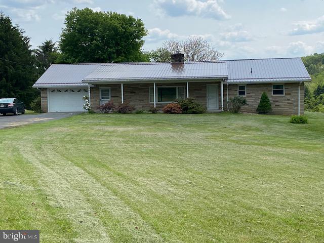 Back on market due to finance issues. This custom built Ohio stone rambler (1568 sq. feet on main level) sits on 2.37 acres fronting on Route 46.  The total finished living area is 3136 sq. feet.  This property is conveniently located to Fort Ashby and Keyser WV, Cumberland MD, and Allegany Ballistics Laboratory (Northrop Grumman).  The house is heated by electric heat pump and has central air.  A well provides abundant, excellent water, and there is a spring  with a holding tank which is handy for outside watering.

The main level includes a large master bedroom, second bedroom, bathroom with walk-in shower, living room, kitchen/dining room, and laundry room.  A two sided, ceiling-high stone fireplace with propane gas logs divides the kitchen/dining area and living room.  The laundry room leads to an oversized one car garage with garage door opener and two addition exits to the outside.  There are no steps on the main level and all doors are 36 inches wide.  This home has a new metal roof installed May 2023.

The lower level (1568 sq feet) can be accessed by stairs which accommodate a stair chair and a private entrance from the outside.  It is finished with a full eat-in kitchen, laundry area with storage, living area, bathroom with walk-in shower, recreation area with pool table, and one bedroom and one bonus room with a closet.  A wood/coal burning stove in the lower level could heat the entire house.

The outside areas include a covered front porch, a fenced concrete pool in the backyard (not used in recent years), large lawn areas, two sheds, large garden area, mature trees, perennial flower beds, and plenty of room for parking. This property, located in a very desirable area, has so many possibilities.  It is a must see.