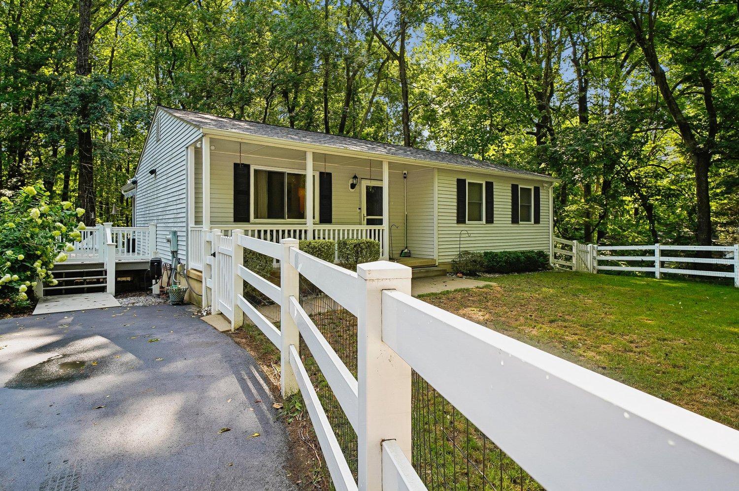 Welcome to your own private retreat just minutes from the Chesapeake Bay!

Nestled on a picturesque 1.13-acre wooded lot just 4 miles from Chesapeake Beach & Boardwalk, this beautifully updated 3-bedroom, 3 full bath home offers the perfect blend of privacy, functionality, and coastal convenience...with no HOA and room for all your hobbies, vehicles, and recreational toys.

Set well back from the road, this move-in-ready home welcomes you with the privacy and serenity of a wooded oasis. The open-concept main level features an updated kitchen that flows effortlessly into the living room and bright sunroom, where skylights fill the space with natural light. Step outside onto the deck to enjoy your morning coffee, entertain family and friends, or simply unwind while overlooking the peaceful backyard.

The fully finished walk-out lower level offers exceptional additional living space, complete with a wet bar, full bathroom, and a versatile bonus room perfect for a home office, gym, theater room, guest space, or hobby room. The separate walk-out entrance provides added flexibility for entertaining or multigenerational living.

Outdoor enthusiasts, hobbyists, and anyone needing serious storage will appreciate the incredible outbuildings. The impressive 24' x 48' pole barn features electric service, soaring 15-foot ceilings, and a 14-foot overhead garage door, making it ideal for storing a boat, RV, camper, trailer, work vehicles, recreational equipment, or creating the ultimate workshop. A detached one-car garage with an attached workshop provides even more workspace, while the large detached storage shed, currently used as a hobby studio and craft space, is perfect for creative pursuits, gardening, a potting shed, or additional storage. The long driveway easily accommodates multiple vehicles, making parking effortless for family and guests.

Major improvements have already been completed for you, including a new roof (2022), HVAC system with both indoor and outdoor units replaced (2021), and hot water heater (2021). The home also includes a generator with custom built dedicated generator housing, providing added peace of mind in every season.

Additional highlights include walk-in closets, abundant storage throughout, whole house fan, a fenced yard, deck, patio, and a beautiful wooded backyard offering exceptional privacy and room to roam.

Located in the award-winning Calvert County school district with convenient access to Route 2, this exceptional property is just minutes from Chesapeake Beach's marinas, waterfront dining, boardwalks, parks, charter fishing, breweries, local shops, and all the charm of the Chesapeake Bay lifestyle.

Offering the rare combination of privacy, modern updates, incredible outbuildings, and an unbeatable location just minutes from the beach...this is a property you'll be proud to call home.