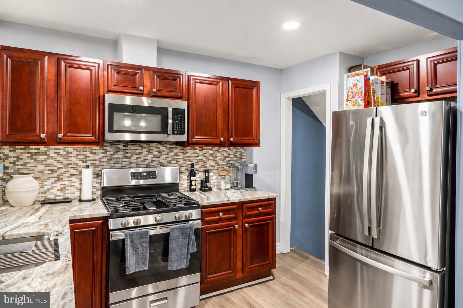 This beautifully updated end-unit rowhome offers the perfect blend of charm, space, and modern upgrades. Step inside to a bright and inviting main level featuring updated flooring, recessed lighting, and a spacious living area filled with natural light. The renovated kitchen is a standout, showcasing granite countertops, stainless steel appliances, stylish backsplash, and rich cabinetry that is perfect for everyday living and entertaining... The main level also includes a dedicated dining area and convenient rear access leading to a private parking pad. Upstairs, you’ll find 3 generously sized bedrooms with fresh paint, updated flooring, and ample closet space, along with a well-maintained full bathroom.