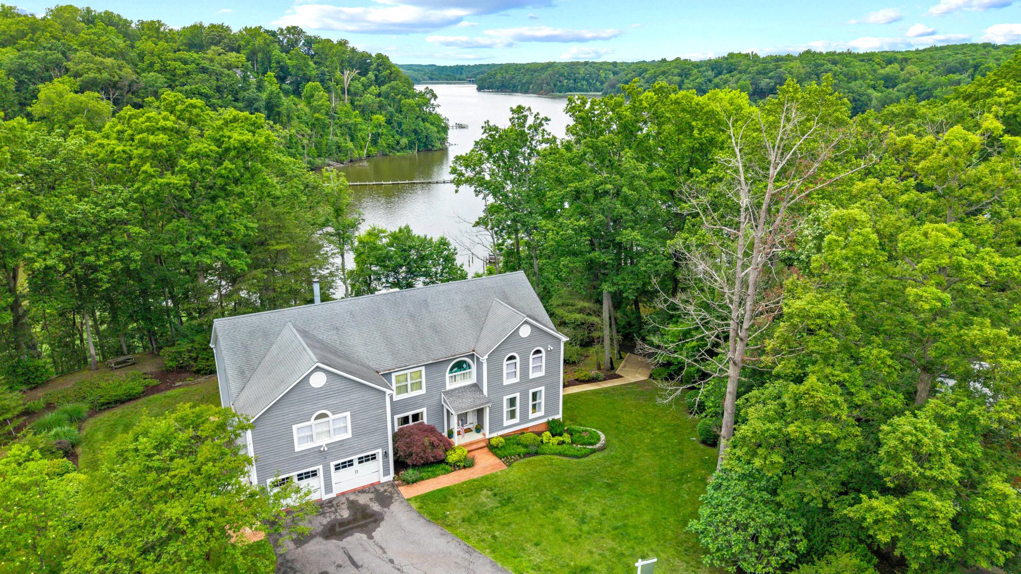 Expansive, beautiful home tastefully updated throughout in 2022 with impressive views of the South River. High ceilings, open layout with room and flow for entertaining and family living. Large Foyer Entry with vaulted Ceilings and the gleaming Hardwood Floors that continue throughout the main and upper level. A Family room/Den is off to your right and the formal Dining Room is to your left. Behind that you have a spa-like renovated Full Bath and a main level Bedroom behind with gorgeous water views. A large family room with a gas fireplace large windows and more views of the river and French Doors to one of the large decks. Moving to your left you pass the gorgeous Wet Bar with wine fridge and coffee area ... the perfect entertainers set up. Behind it opens to the breakfast/dining area and then and expansive Chef's Kitchen with huge Island, loads of counter space and cabinetry. The wall ovens, cooktop and a separate stove provide flexibility as well as allowing multiple chefs to work together. You can either head through the doors to your four season sunroom for relaxing to the views or a quiet spot to read.  Past the Kitchen is the  first floor Laundry Room with a Powder Room off of it for guests. There is also a large pantry and access to the oversized attached 2 car garage. Upstairs there are 4 additional bedrooms and 3 full baths all beautifully remodeled. The oversized Primary Suite has sitting areas, 2 large walk-in Closets plus 2 additional Closets, a 2-sided gas Fireplace and a Balcony overlooking the water. The huge en-suite Bath has an impressive Double Vanity as well as a 2nd vanity, a large soaking tub plus a separate shower. The walk-out Lower Level has additional flex space with another bedroom, a den/office with walkout to another level of decking. It also has a full bath as well as expansive space for utilities and storage. All this sitting on over an acre with gorgeous views and just a short boat ride up the South River to local waterside restaurants, over to Annapolis or out on the Bay. The location is minutes from Commuter Routes, Rt #50 and #97 as well as to downtown Annapolis. Don't miss it.