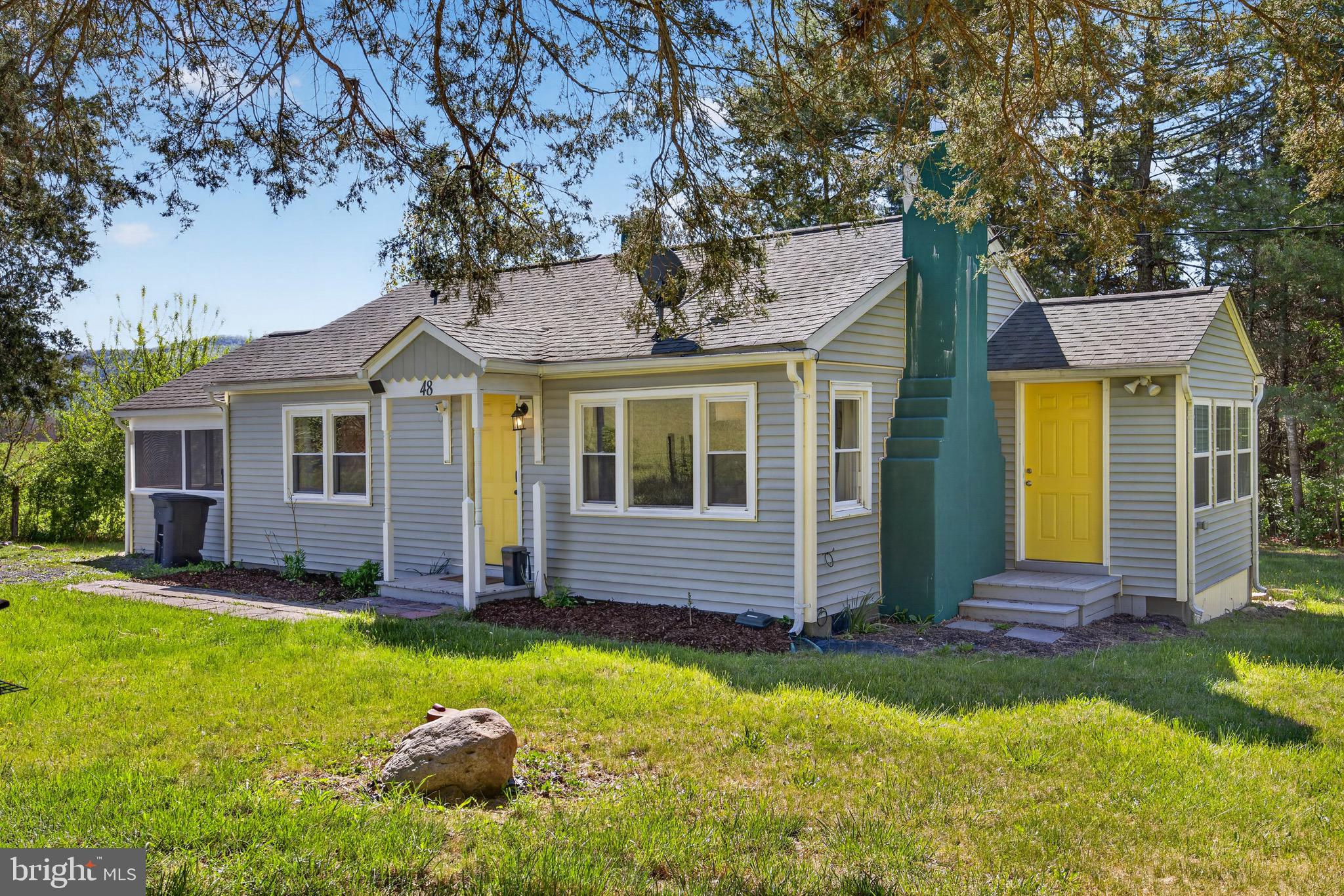 Charming, beautifully remodeled, and tucked away in a private, secluded setting, this Fort Valley rancher is full of character and ready to impress! From the moment you arrive, the cheerful yellow front door welcomes you inside to a warm and inviting open floor plan featuring hardwood floors throughout the living room and kitchen. The spacious living room offers a beautiful fireplace and abundant natural light from the many windows. The kitchen provides plenty of space, ample cabinetry, and a charming cottage feel, flowing nicely into the dining area where walls of windows allow you to enjoy the peaceful nature surroundings.  Down the hall you will find two spacious bedrooms (Sunrise and Sunset) that have been custom painted, a beautifully remodeled bathroom with a gorgeous tiled walk-in shower, plus you have a convenient laundry/pantry/utility room just off the kitchen. The back deck offers beautiful mountain views and is the ideal setting for relaxing, grilling, or hosting guests. Just off the deck area, the screened-in porch is the perfect place to relax and unwind with those same views. The outdoor space continues with creek frontage, a cozy fire pit area beside the water for soaking up nature, a hot tub, and a storage shed for added convenience. With mountain views, water frontage, and so much charm, this Fort Valley gem will not last long!