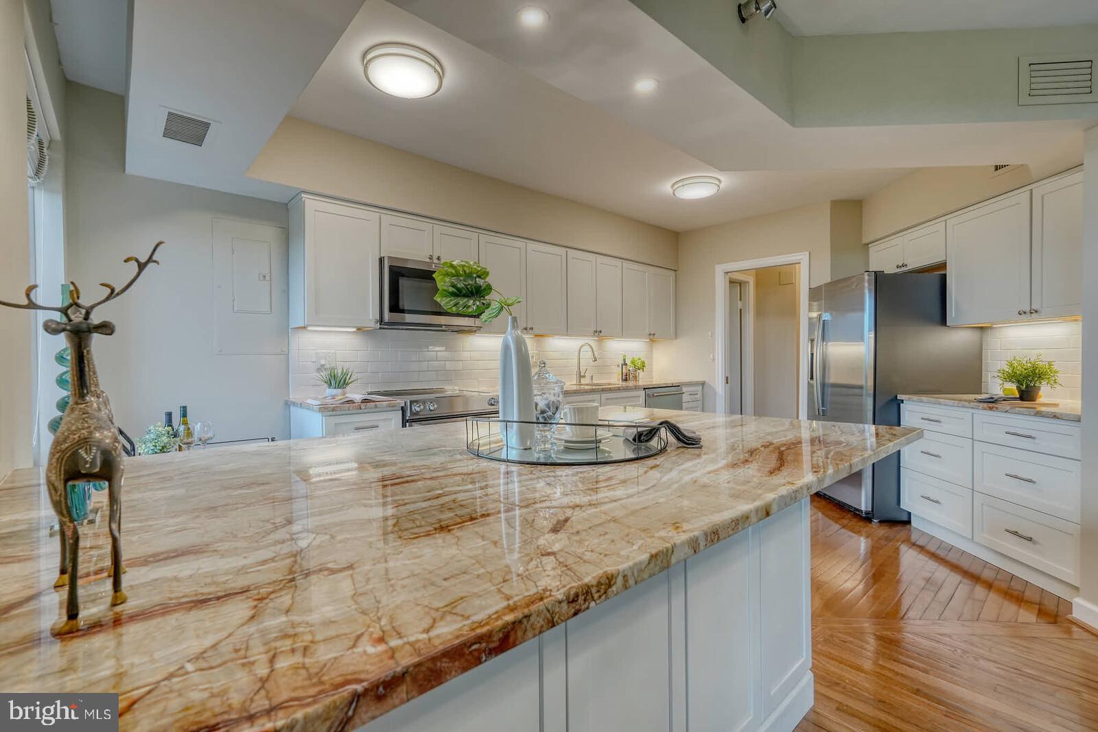 --> Rare 2 Bedroom + Den Condo with 2.5 Baths, a massive double balcony soaked in afternoon sun, and a custom, open Kitchen with tons of gorgeous, higher end granite countertops. Lots of cabinets and a look and feel that says, "single family home kitchen."  You will see!  The large living room and dining area flows ideally off the kitchen. Completely open.  And the Primary Bedroom has a completely NEW Bathroom with an extra large walk-in shower. This is not just another condo. 1-block to Whole Foods. 3-blocks to Pike & Rose and the METRO. 2- Garage Parking Spaces + Storage Cage.