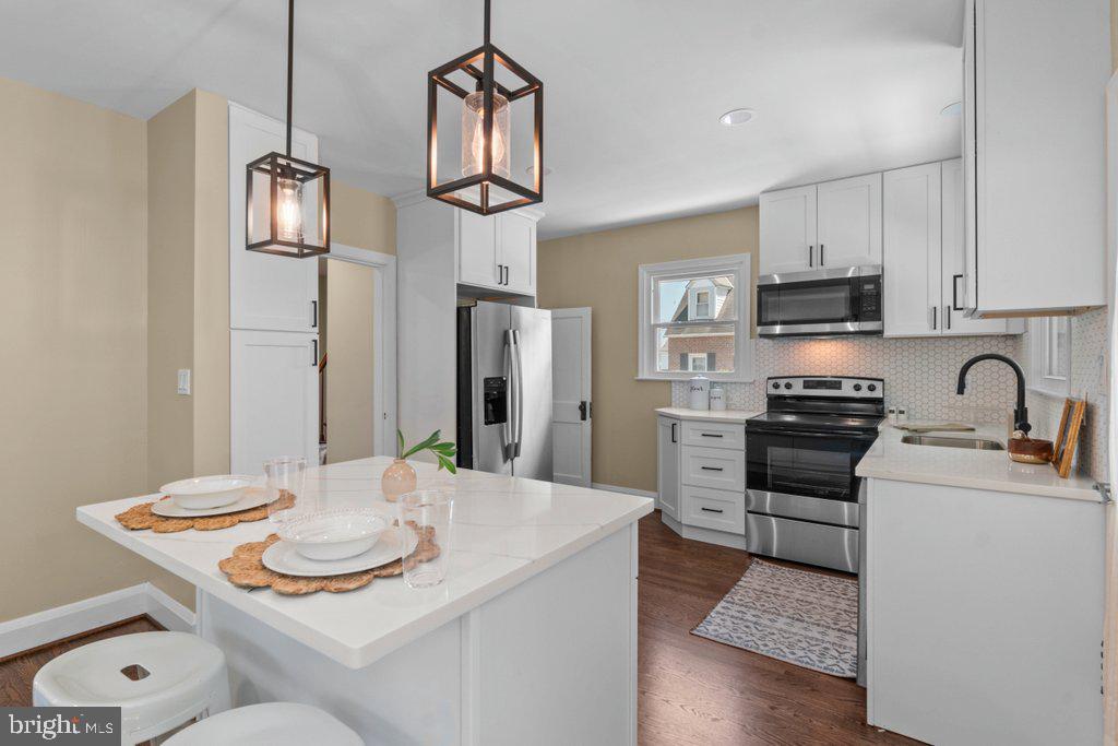 Completely renovated from top to bottom, 3027 Lavender Ave is the definition of move-in ready. This stunning brick Colonial has been thoughtfully updated throughout with brand-new systems, stylish finishes, and modern conveniences while still maintaining its timeless charm and character. Nearly every inch of the home has been refreshed, allowing the next owner to simply unpack and enjoy. Major renovations include all new windows, updated electric (inspected and permitted), a brand-new hot water heater, and completely updated HVAC systems featuring ductless mini splits on the main level and basement, plus a separate system serving the upper level for efficient comfort throughout the home. Fresh paint brightens every room, restored original hardwood flooring adds warmth and elegance, and new carpet has been installed in the fully finished basement. Waterproofing improvements have also been completed, offering added peace of mind for years to come. Situated on a spacious corner lot in Parkville, this property offers front, side, and rear yard space, a detached 1-car garage, private driveway parking, and plenty of additional street parking for guests. The classic brick exterior delivers timeless curb appeal while the completely renovated interior offers the modern open-concept living buyers are searching for. Inside, the welcoming living room features a cozy wood-burning fireplace and flows seamlessly into the dining area and beautifully redesigned kitchen. The kitchen is truly the heart of the home, showcasing sparkling quartz countertops, crisp white cabinetry, brand-new appliances, and a large center island perfect for entertaining, meal prep, or casual dining. The open floorplan creates an airy and connected feel ideal for both everyday living and hosting gatherings. The upper level includes three comfortable bedrooms and a full bathroom, while the fully finished basement provides valuable additional living space complete with a second full bathroom, abundant closet and storage space, and direct garage access. Whether used as a family room, guest area, home office, or recreation space, the basement offers flexibility to fit a variety of lifestyles. Every detail of this home has already been completed for you. With extensive renovations, modern upgrades, and classic Colonial charm, 3027 Lavender Ave offers the rare opportunity to own a truly turnkey home in a convenient Parkville location close to shopping, dining, parks, and commuter routes.