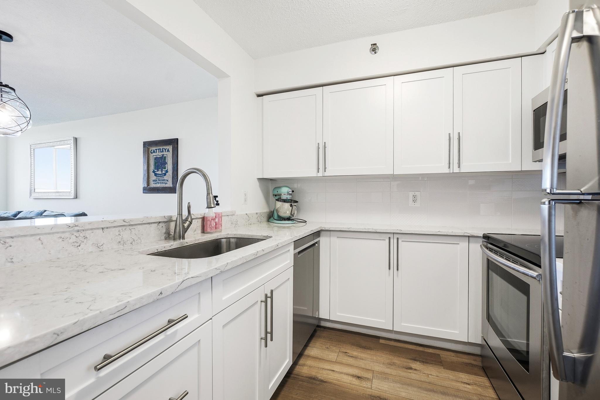 Price improved! Welcome to this stunning 2-bedroom, 1-bath condominium in the highly desirable Grosvenor Park Community, rarely inclusive of two garage parking spaces and a storage unit. Ideally located just off the I-270 Spur, this home offers exceptional convenience with easy access to major commuter routes, public transportation, Downtown Bethesda, Walter Reed National Military Medical Center, and the National Institutes of Health. The Grosvenor-Strathmore Metro Station is just 0.6 miles away, making commuting a breeze.

Enjoy peace of mind with full-service building amenities, including concierge service, while experiencing over 1,100 square feet of beautifully updated living space. A welcoming entry opens to durable luxury vinyl plank flooring (installed in 2020) that flows throughout the unit. The renovated kitchen (2020) features crisp white cabinetry, quartz countertops, decorative tile backsplash, stainless steel appliances, and overlooks the open-concept living and dining areas.

The spacious dining area offers ample room for entertaining, while the sun-filled living room showcases wall-to-wall windows and direct access to a large private balcony with sweeping views of the community and lush surrounding trees. An in-unit washer and dryer provide added convenience.

The generously sized primary bedroom includes a large walk-in closet (with Elfa system installed) and private access to the east-facing balcony. The secondary bedroom is equally spacious, and both bedrooms enjoy access to the updated full bathroom (2020), complete with modern finishes such as a large quartz topped vanity  offering abundant storage, and a 12x24 tiled tub/shower combination with glass enclosure.

Residents enjoy an impressive array of community amenities, including a swimming pool, fitness center, sauna, business center, party room, walking paths, and numerous common gathering spaces. This exceptional home combines comfort, style, and an unbeatable location in one of the area's most sought-after communities. Schedule a showing today!