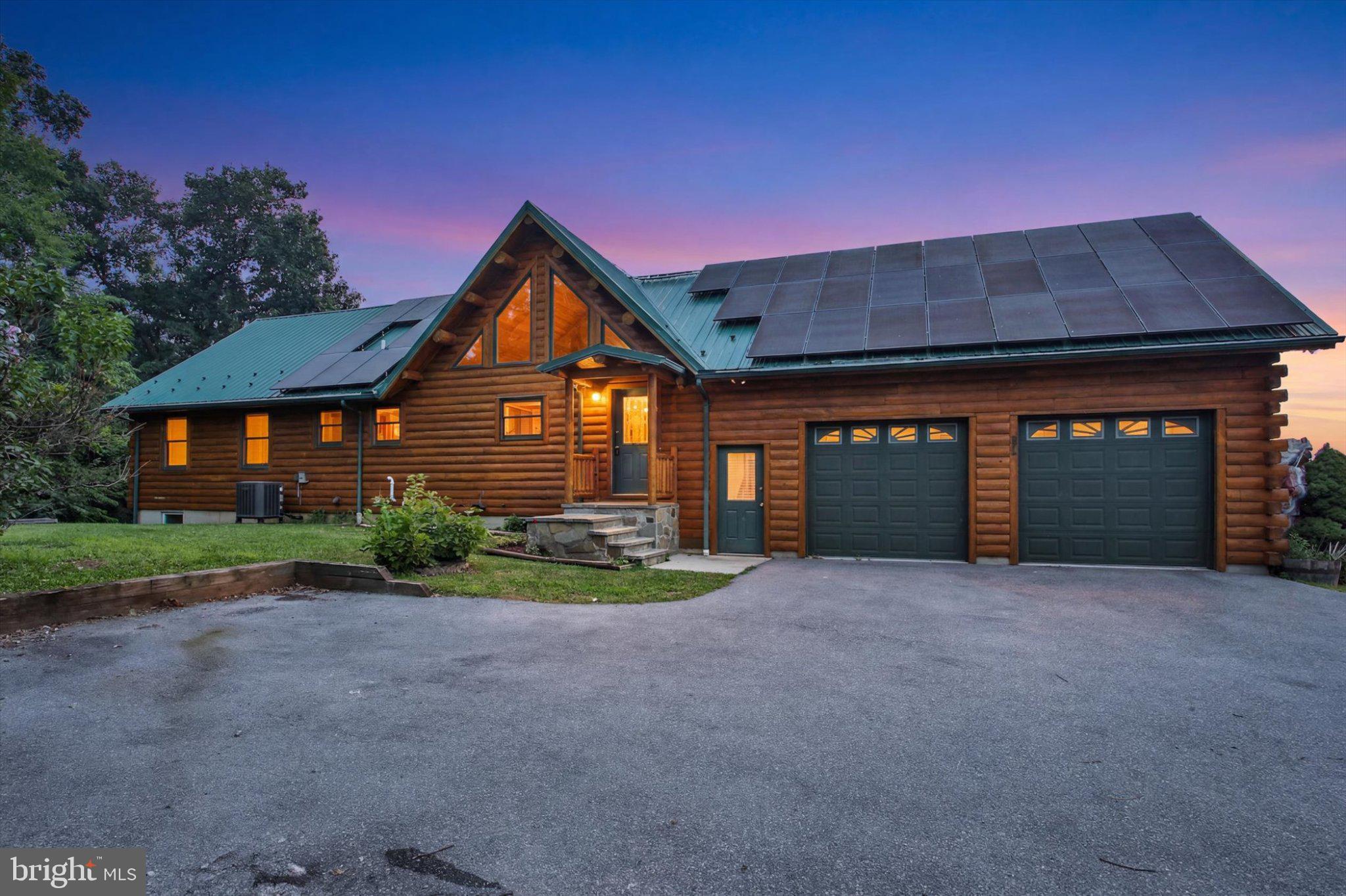 Breathtaking panoramic mountain views surround this exceptional custom cedar log home, perfectly located just minutes from Liberty Mountain Resort and an easy drive to historic downtown Gettysburg. Designed to capture the stunning scenery, this 3-bedroom, 2-bath home features an open floor plan with soaring 16+ ft. cathedral ceilings, authentic purlin logs, heavy timber trusses, and expansive Andersen windows that fill the home with natural light. The impressive great room flows into the dining area and kitchen with granite countertops, Southern hickory beaded cabinetry, and all appliances included. The spacious primary suite offers double closets and a private bath with an encapsulated jetted tub. Quality craftsmanship shines throughout with hickory hardwood floors, pine tongue-and-groove walls, handcrafted wood doors, and main-level laundry. Additional highlights include central air, a full basement, newer metal roof, oversized two-car garage, two storage sheds, and a covered front porch overlooking the beautifully manicured property and spectacular mountain vistas. Energy-efficient solar panels with battery backup provide added peace of mind, helping keep essential systems powered during outages while reducing energy costs. Convenient to Route 15, golf, dining, and outdoor recreation, this is log home living at its finest.