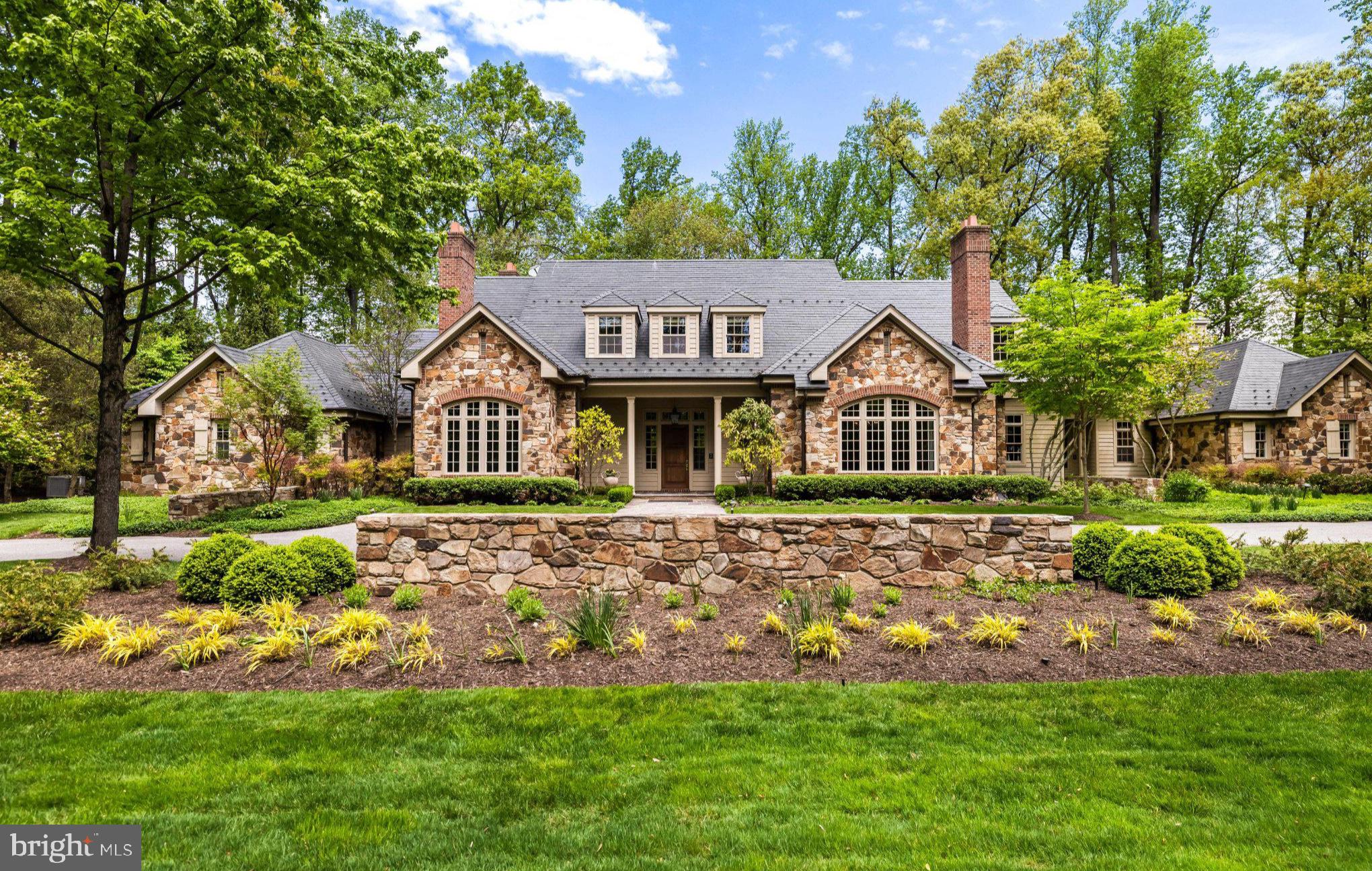 The Residences of Caves Valley Golf Club—11300 John Carroll Road is a property of distinction, embodying a rare union of timeless luxury, precision craftsmanship, and masterful care within one of the region’s most prestigious enclaves.  Designed to seamlessly balance grand-scale entertaining with refined everyday living, this exceptional estate features 5 bedrooms, 5 full baths, and 3 powder rooms.
A resplendent foyer welcomes with soaring 12-foot ceilings and striking herringbone cherry flooring, setting the tone for the home’s elegant design. Expansive, light-filled living spaces unfold with effortless flow, framed by oversized windows that capture picturesque views. The grand family room offers an inviting gathering space, complemented by a light-filled extension with travertine flooring and walls of windows.  The richly appointed library showcases floor-to-ceiling custom cherry paneling, 8-foot paneled pocket doors, a coffered ceiling, and refined millwork, while the intimate living room provides a warm setting to unwind by the fire, complete with a discreet wet bar niche. The gourmet kitchen anchors the home, highlighted by an oversized island, Viking Professional 6-burner double oven range with custom vent hood, Dacor warming drawer, cabinet-paneled appliances, and “Prevo” custom cabinetry with specialized storage. The main-level primary suite is a private retreat, featuring a luxurious marble bath with dual vanities, jetted tub, and an exceptional custom dressing room. The finished lower level elevates the home’s entertainment appeal with a state-of-the-art theater by Gramophone, bespoke billiards lounge, copper-wrapped wet bar, and expansive recreation and lounge areas. Overlooking the first hole, this remarkable estate is set on over 2 acres of private, level, and beautifully manicured grounds, enhanced by a bluestone terrace and a tranquil koi pond with a waterfall feature. The setting offers a rare blend of usable land, serenity, and sweeping golf course vistas, while a 4-car garage and meticulous attention to detail complete this extraordinary offering.