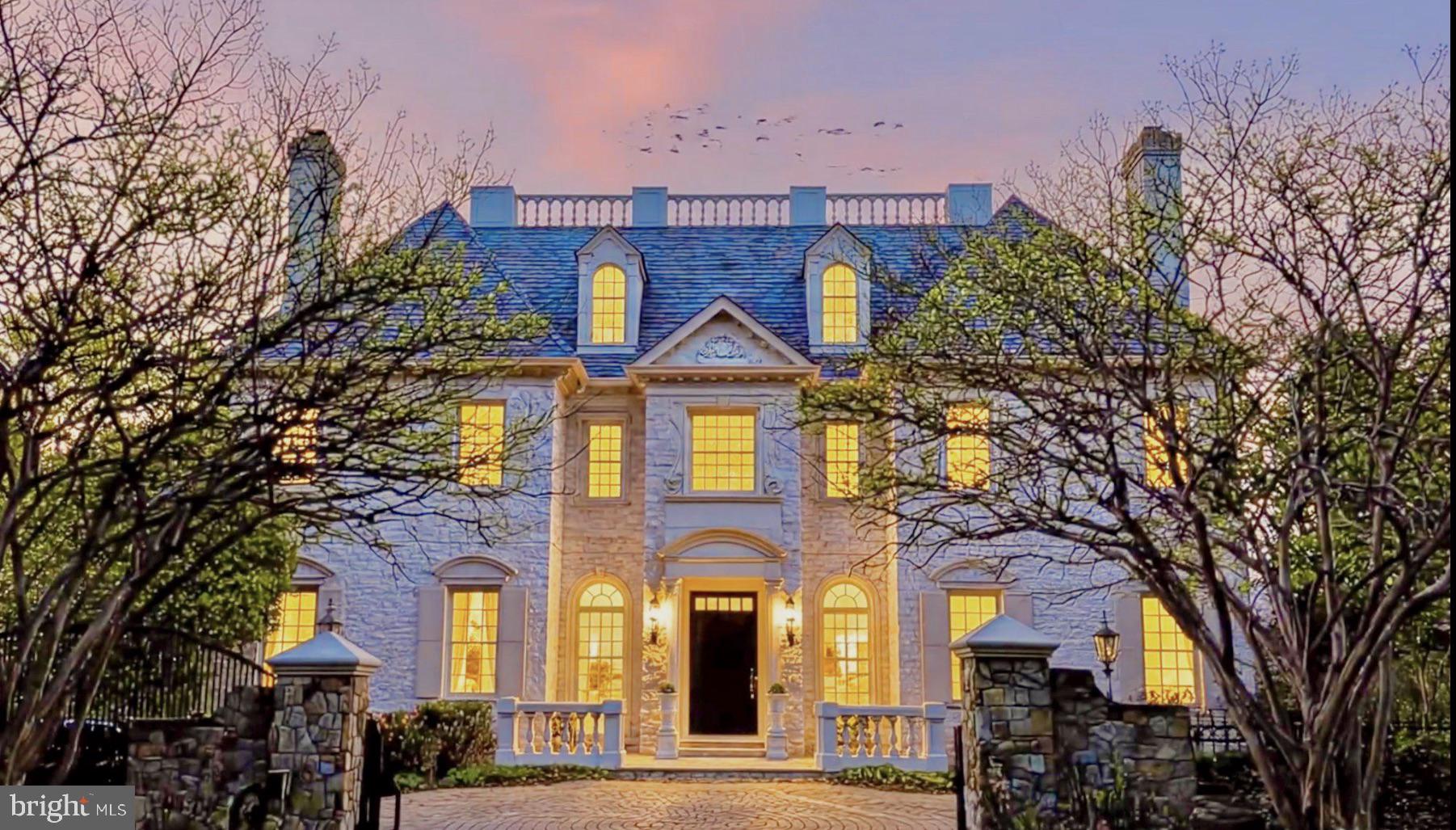 Experience the height of sophistication in this Ballantrae Farm estate. MCLEAN’S CROWNING ACHIEVEMENT: A HAND-CARVED ARCHITECTURAL MARVEL IN THE HEART OF THE ENCLAVE. EXCLUSIVITY, PRIVACY & CENTRALITY. The exterior captivates with Intricate brickwork, pediment crown, dentil molding, rope-scroll keystones, arched fanlights, limestone accents and that refined carved detail–designed for the most discerning resident. CRAFTED FOR WORLD-CLASS VIP ENTERTAINMENT.The home makes a breathtaking first impression with a GIGANTIC TWO-STORY MARBLE FOYER featuring soaring ceilings and walls draped in exquisite finished woodwork–MASTERFUL WOOD WALL PANELS lining the grand foyer. OFFERED FULLY FURNISHED with a tastefully curated collection of high-end pieces, gathered over years to perfectly suit the home’s grand proportions–MOVE-IN-READY INTERIOR IS INCLUDED IN THE MONTHLY RENT. This grand estate INCLUDES 5 FIRE PLACES–2 wood burning fire places in living and dining rooms and 5 gas fireplaces in family room, 1 in MB and 2 in the lower level. As you step down into the sun-drenched family room, you are greeted by a dramatic seven-sided layout where five of the walls form a majestic hexagonal-style configuration with intricate custom wood paneling with fluted pilasters giving you a rhythmic grace thats timeless and inviting. From there, transition seamlessly to a MASSIVE STONE TERRACE, an expansive outdoor oasis designed for effortless gathering. This grand TERRACE OPENS ONTO LUSH PRIVATE GREENERY AND TOWERING TREES, offering a serene and park-like backdrop that ensures total seclusion. For the automotive enthusiast, the property features an impressive FOUR-CAR GARAGE and a spacious rear drive court—painted for games, with a basketball hoop ready to go, perfect for spacious parking, games or play. Every level of this residence is accessible via ELEVATOR, INCLUDING THE PRIVATE FOURTH-FLOOR RETREAT, which welcomes you with a beautiful sanctuary space, a luxurious bathroom, and a spa-like steam shower. This FULLY GATED AND FULLY FENCED PROPERTY is offered fully furnished (included in rent). The Upper Level is crowned by a PALATIAL GRAND MASTER BEDROOM SANCTUARY– A PRIVATE LOUNGE AREA WITH A WARM FIREPLACE, TWO SEPARATE SPA-INSPIRED BATHROOMS, and two expansive boutique-style walk-in closets. UPSTAIR BEDROOMS–SPACIOUS PRIVATE RETREATS, EVERY ONE WITH THEIR OWN DEDICATED BATHROOM, BIDET AND WALK-CLOSETS included. The WALK-OUT LOWER LEVEL MIRRORS THE MAIN LEVEL’S UNIQUE DESIGN—offering a hexagonal flow that double as your SWIM SPA LOUNGE: a full recreation hub with wet bar, plush seating, and serene views overlooking the timeless swim spa and lush private oasis. The lower level opens with a stunning marble foyer—right at the entrance to your PRIVATE WINE CELLAR–ELEGANT WROUGHT-IRON GATE. The SWIM SPA: YOUR PRIVATE ENDLESS CURRENT—laps, bubbles, pure unwind. THIS ESTATE GIVES YOU RARE PRIVACY AND ESCAPE—yet you’re just minutes from Tysons Corner Center and Tysons Galleria’s world-class shopping and dining, with major commuter routes at your doorstep and downtown D.C. a quick drive away for those breathtaking museums and monuments. Showings is by appointment only with a minimum 48-hour notice
