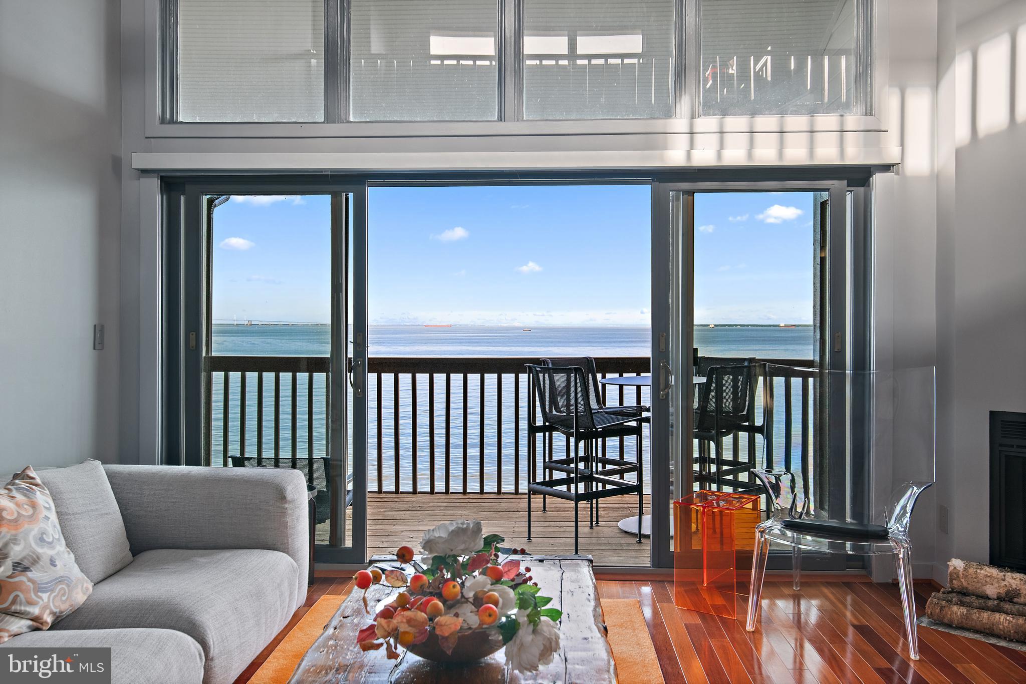 With just one look, you will fall in love! Vacation every day in your stunning two-level condo with exceptional views and amazing privacy! Wonderful open floor plan and walls of glass make you feel like you are on a boat and create outstanding views from every room. Exceptional features include smart technology throughout, a wood-burning fireplace, soaring ceilings, GE Cafe appliances (new in 2024), electric blinds, separate dining area with a glass wall that beautifully reflects the water and accentuates the gorgeous natural light. Designer-selected tones throughout the home reflect the changing moods of the outdoors — soft greys and grey blues echo the water and sky, while subtle sunrise-inspired oranges and purples bring warmth and character to the interiors. Cherry wood floors and rich wood accents create a seamless connection between indoor living and the surrounding waterfront setting. The unit has been redesigned to increase the storage, creating ample closet space.  Every day is a new opportunity to experience an incredible sunrise over the Chesapeake Bay Bridge and Eastern Shore, follow the tankers and watch the boat races. Chesapeake Harbour is a gated waterfront resort with outstanding water access, including private beaches, boat launch, and great piers for gathering with friends and neighbors to watch the races or cast a fishing line.  Choose which of the two waterside community pools suits your mood (one is heated),  enjoy a game of tennis on the multiple available courts, or launch your boat or board from the sandy beach and glide across the water. Take one of the many community paths to the marina (slips at Chesapeake Harbour Marina are available for a fee and NOT part of the HOA) or stop in for drinks or dinner at The Beacon harborside restaurant. Better still, stay home where you have the best view in the community and just relax.  This amazing haven is located within a few short minutes of fun Eastport, Downtown Annapolis and its many offerings, dozens of scrumptious close-by neighborhood restaurants, 5 minutes from multiple breathtaking parks (Quiet Waters, Thomas Point, EO Moyer, Carr's), and it truly feels like a world away from it all! Bonus-100% turnkey-furniture included! Ask for more details!