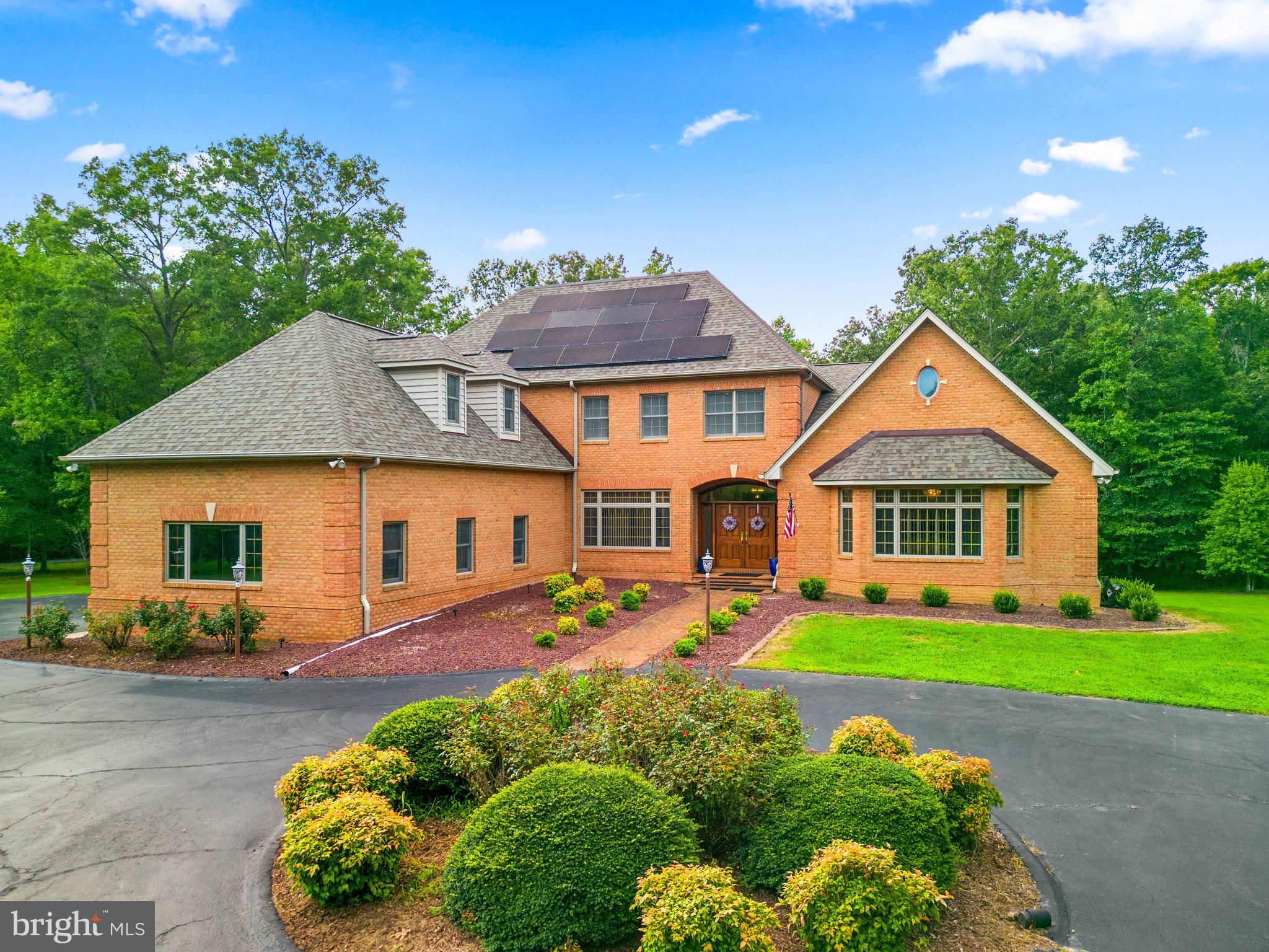 Applegrove Estates! If you're looking for a large home with space between you and your neighbors with no HOA, this home has it all! About the home: This custom home was built in 1998 by Bruce Schafer Construction. Solid, all-brick construction, custom windows, 3 car garage with Tesla charger, circular driveway for guest parking/arrival to your main entrance, geothermal HVAC system, lawn irrigation system and so much more. From the moment you arrive, the home grabs your attention. Open foyer is flanked on both sides by large living and dining areas and leads to a two-story open living area with a fireplace surrounded by granite. The main level owner's suite, and elevator make this floor plan easy to navigate. Beautiful hardwood flooring draws the eye to the custom, curved staircase climbing elegantly to the 2nd level. The kitchen is located on the main level and has expansive counter space, custom cherry cabinetry, center island and leads to a study/home office space with doors to access the rear deck/hot tub area, which can also be accessed from the opposite side of the home from the owner's suite. Laundry, mudroom, utility/storage room has a convenient side door access. The upper level has 4 BRs to include a very large finished room over the garage w/ detached WIC. Each of the 3 remaining upper level BRs have private, full bathrooms and WICs. The lower level can be accessed via stairs or elevator. Perfect for entertaining or multi-generational needs, there is a second full kitchen, 2 dens w/ closet (could be used as a BR) brick fireplace w/ gas log insert, large living area, large storage areas/mechanical room and a walk out level ingress/egress to the lower outdoor patio w/firepit. There are 2 walk-in storage areas, complete with dehumidifiers to protect your possessions. Full court basket-ball court installed and 2 playset areas will convey. Roof is less than a couple of years old, solar panels installed within the last year and attic was reconditioned to add door, insulation, attic fans, partial flooring and offers decreased utility costs and save big $$. About the neighborhood: Applegrove has 18 lots with large, custom-built homes and large lots. It is convenient to LaPlata, Waldorf and to those looking to get away from the hustle and bustle while still being close enough to commute to DC, Annapolis and areas of major employment.