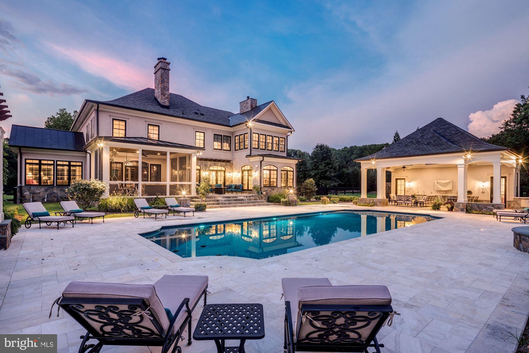 Extraordinary custom-built estate with immense privacy and resort inspired grounds. Beautifully landscaped, the circular driveway brings you to the welcoming entrance that leads you to the Foyer. The library features built-in shelves, fireplace and a cozy reading nook. The Sun Room has vaulted ceiling and ceiling fan. Family Room has a stone fireplace, coffered ceiling and French doors.  The gourmet Kitchen is adorned with granite countertops, custom cabinets, oversized center island and top-of-the-line appliances and opens to the breakfast room that is surrounded by windows. Also, on the Main Level is the formal Dining Room, Mud Room and screened in Porch. The Upper Level features a luxurious Master Suite that has a fireplace, sitting room, sauna, lavish Bath and magnificent walk-in Closet with custom cabinetry, backlit shoe display and two islands. The Lower Level is a dream with a Recreation Room, wet bar, Media Room, Fitness Room, Bedroom with full Bath and a Bonus Room. The fully fenced backyard is a retreat with a pool and spa, outdoor shower, Kitchen with grill, Pergola with fireplace, pool house with bathroom and changing room and vegetable gardens.