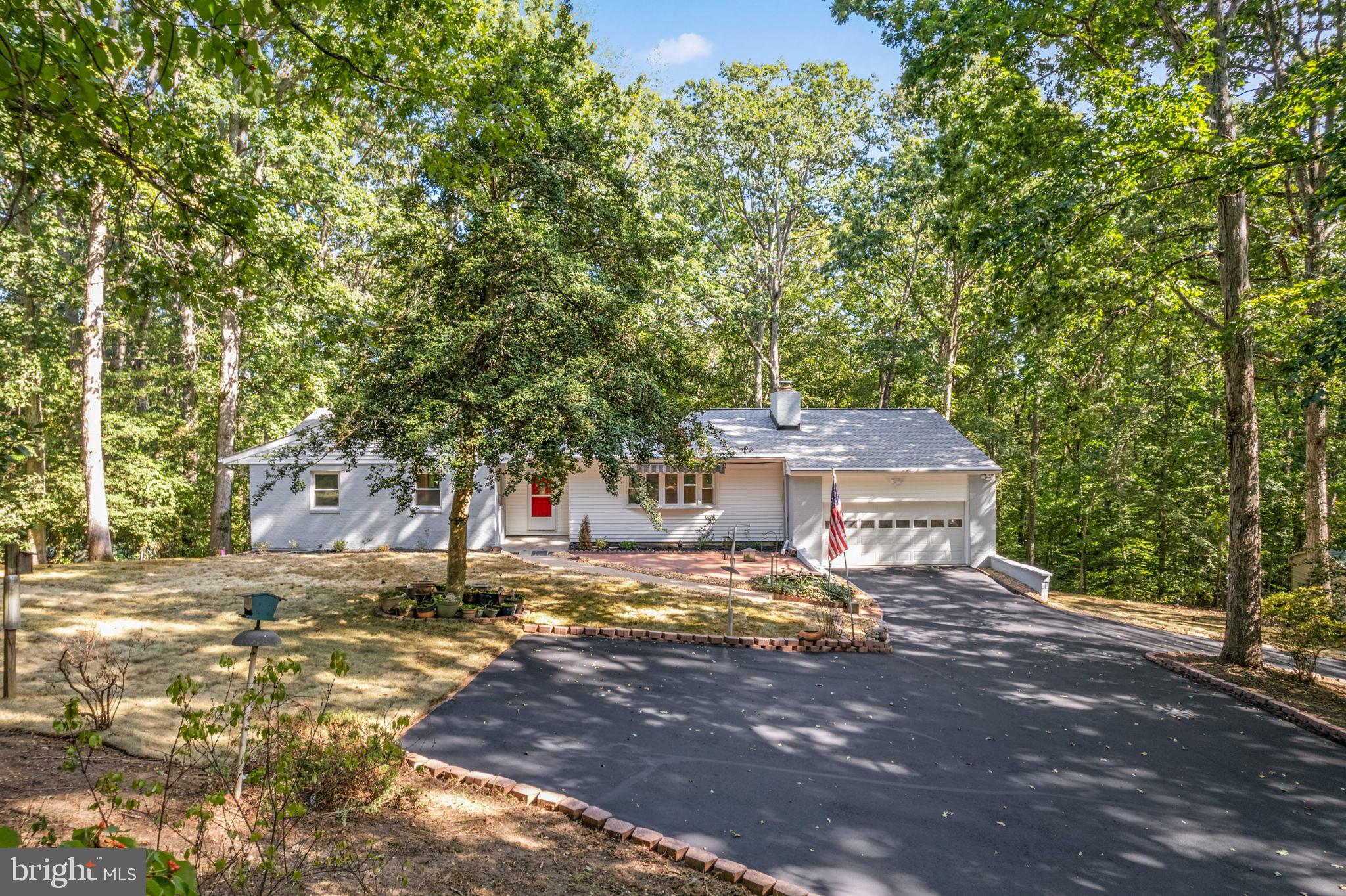 This stunning 5-bedroom, 3-bathroom ranch-style home offers a perfect blend of comfort and modern living. With major renovations completed in 2025, this property features a spacious open floor plan that seamlessly connects the gourmet kitchen with upgraded countertops and stainless steel appliances to the inviting family room, complete with a cozy brick fireplace. The interior boasts elegant wood and tile floors, built-ins, and 3 bedrooms and 2 luxurious bathrooms with a walk-in shower on main level.  In walkout basement enjoy 2 bedrooms and 1 full bath with soaking tub, sauna, and entertaining area with wet bar and additional built ins. Outside, the property spans 8.77 acres, offering a serene, secluded setting that backs to lush trees. Parking is a breeze with a front-entry attached garage and ample driveway space. Enjoy peaceful views of the wooded surroundings, making this home a perfect retreat while still being close to local amenities. This property is a rare find, combining spacious living with nature's tranquility. No HOA.
