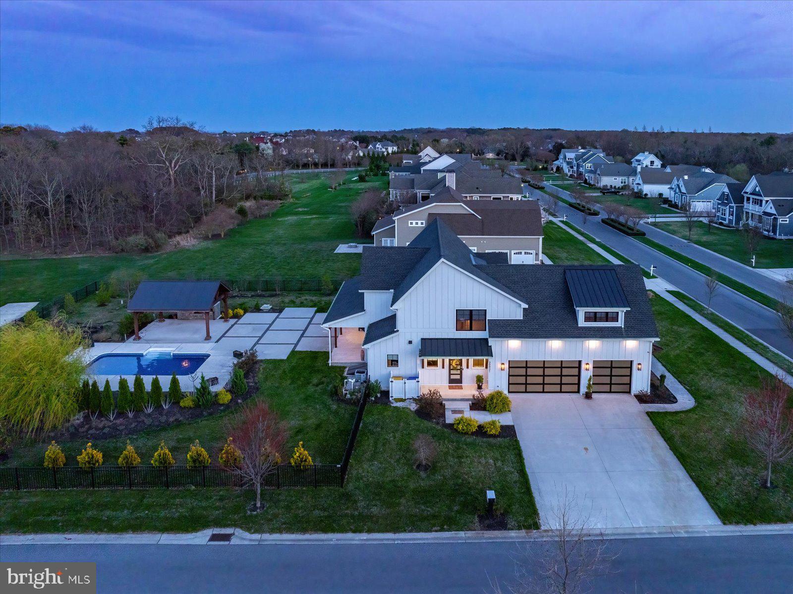 Gorgeous custom-built 4-bedroom 4/1 bath coastal farmhouse in the prestigious Show field community. Ideally located just minutes from historic downtown Lewes, the beaches, Cape Henlopen State Park, and the shopping and dining of Rehoboth Beach, this home offers convenient access to Delaware, Maryland, and even the Cape May–Lewes Ferry to New Jersey. Show field offers exceptional amenities, including a first-class clubhouse, resort-style pool, fitness center, and scenic walking trails surrounded by ponds and natural wildlife. This home, however, truly shines with its incredible private backyard retreat. Situated on a spacious corner lot, the outdoor living space is designed for both relaxation and entertaining, featuring a beautifully crafted pavilion with a stunning custom stone fireplace—creating a warm, inviting atmosphere year-round. The poolside setting offers the perfect place to unwind, host gatherings, or enjoy quiet evenings in a serene, resort-like environment. Thoughtfully designed landscaping enhances privacy while complementing the natural surroundings. Built by a respected local builder, this home showcases quality craftsmanship and thoughtful details throughout, with an emphasis on efficiency and durability. Offering approximately 3,300 sq ft of beautifully finished living space, plus an unfinished basement already plumbed for a bathroom—ready for your personal touch.