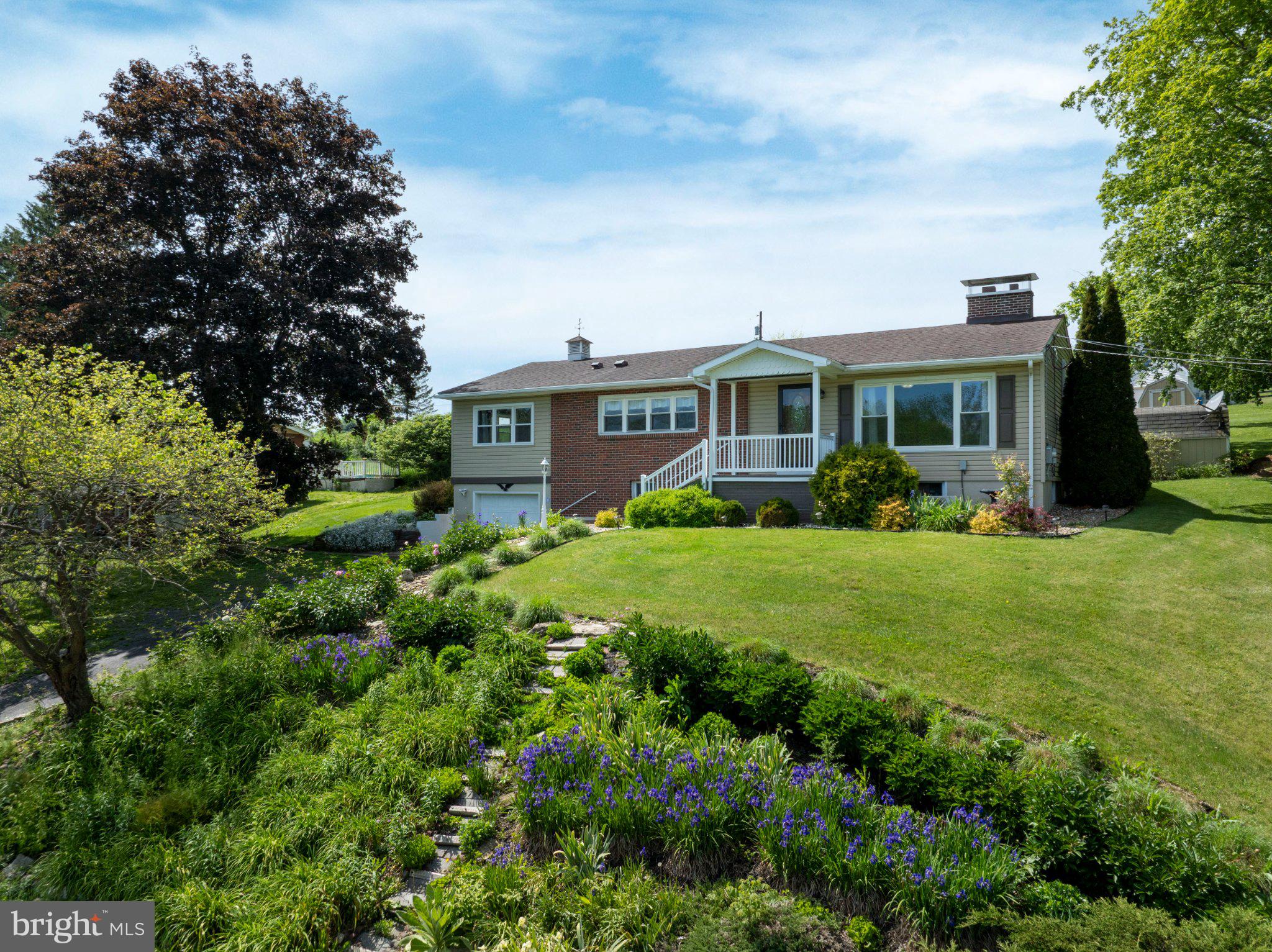 Ranch living with a view in Houserville! This 3-bed, 2 bath home offers one‑floor convenience, a comfortable layout, and a beautifully landscaped front yard with a charming porch overlooking Spring Creek. Inside, enjoy a bright living room with a brick‑surround wood fireplace and a large picture window framing the scenery. The eat‑in kitchen features granite countertops, tile backsplash, and stainless appliances. Three well‑sized bedrooms and a full bath complete the main level, along with a versatile bonus room off the kitchen—perfect as a family room, dining space, or more. The fully finished lower level is set up for fun with a family/rec room combo, pool table, built‑in wraparound bar seating, and an updated full bath. Outside, relax on the expansive patio with pergola and firepit, plus two sheds, a metal accessibility ramp, and a newly added gravel driveway. Additional highlights include fresh interior paint, a new water softener, and a 1‑car garage. Close to parks, shopping and Penn State attractions. Schedule your showing today!
