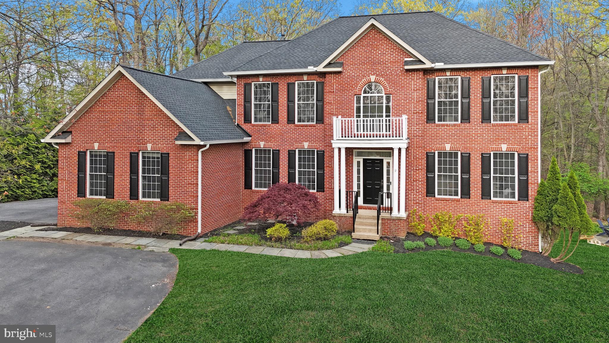 Welcome to 12651 W. Oak Drive — a timeless brick Colonial nestled on 2.49 acres of serene forested beauty, where luxury and comfort unfold in every detail. With a stunning red brick portico, classic black shutters, and a bold black front door, this home commands attention from the moment you arrive. A brand-new roof (2023) crowns the residence, setting the stage for the exceptional updates that await inside. Step into a grand two-story foyer, where you're greeted by freshly refinished hardwood flooring, brand-new paint and carpet, and a sweeping staircase accented by crown and chair rail molding. To the right, the sunlit formal living room offers elegance and charm with expansive windows and a ceiling fan. To the left, the formal dining room is perfect for entertaining, adorned with wainscoting, crown molding, a dazzling crystal chandelier, and direct access to the butler’s pantry. The heart of the home is the beautifully updated kitchen—an oversized culinary space with abundant cabinetry, stainless steel appliances, granite countertops, a JennAir cooktop with an exterior-vented hood, wall oven, and stunning picture windows overlooking your wooded backyard. The adjacent breakfast nook features a new chandelier and private access to the rear paver patio, seamlessly blending indoor and outdoor living. A huge walk-in pantry with accordion barn doors provides extra storage and connects to the spacious two-car garage. The inviting family room boasts a fireplace with a decorative mantle, walls of windows, and dual access to the patio—ideal for cozy nights or hosting gatherings. A French door study with Palladian windows and a custom accent wall offers a peaceful workspace, while a well-appointed mudroom with built-ins, a walk-in laundry area, and a powder room complete the main level. Upstairs, the massive owner's suite is a true retreat, complete with a spacious sitting area, a ceiling fan, and a fully renovated ensuite bath showcasing marble-style flooring, a double quartz vanity, soaking tub, oversized walk-in shower, and private water closet. The walk-in closet is impressively sized. Three secondary bedrooms feature brand-new carpet and paint, and two beautifully updated full bathrooms offer modern elegance with marble-style tile. The upper hallway continues the theme of quality with hardwood floors and a linen closet for added convenience. The lower level is fully finished with brand-new luxury vinyl plank flooring, fresh paint, and built-in speaker systems. Perfect for multi-generational living or entertaining, it includes a full second kitchen with quartz countertops, a stainless steel sink, and mini fridge, a full bath with a tub/shower combo, a bonus room, and expansive recreational space. Walk out to the paver patio with a built-in stone fireplace, curved seating wall, a playground, and total privacy—your backyard oasis bordered by forest and mature trees. With a 2024 HVAC system and a 2020 heat pump, this home is as functional as it is beautiful—offering peace of mind and energy efficiency. 12651 W. Oak Drive is more than just a residence—it's a lifestyle. Thoughtfully updated, meticulously maintained, and privately set, it’s ready to welcome you home. Schedule your private showing today.