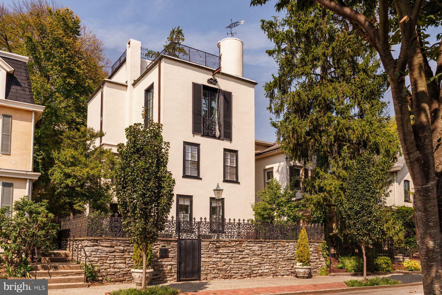 Welcome to 191 E. Evergreen Avenue, a rare architectural gem in Chestnut Hill. Built in 1885 by John W. Hottenstein as a modest Victorian, the home was reimagined in 1932 by distinguished architect Edmund B. Gilchrist, engaged by artist and collector Carroll S. Tyson, Jr., who purchased the property for his friend, renowned American modernist Arthur B. Carles, and oversaw its transformation into a luminous residence and studio which became the birthplace of many of Carles' celebrated works now held in major collections like the Philadelphia Museum of Art.


Set behind a handsome stone wall and wrought iron fencing, the home exudes European charm with tall windows, decorative balconies, and a private flagstone courtyard. Spanning over 4,400 square feet across three levels, it offers 4 bedrooms, 3 full and 2 half baths. Timeless details include original hardwood floors, custom millwork, and a graceful staircase with grasscloth wallpaper. Elegant living and dining rooms with a fireplace provide inviting entertaining spaces, while the renovated kitchen features white cabinetry, a marble peninsula, Viking range, and an adjacent family room. A private rear suite with its own entrance and kitchenette offers flexible living or work space, with a separate staircase leading to the bedroom and bath above.


Upstairs, three bedrooms and a second-floor laundry offer comfort and convenience. Architectural plans are available for future customization, thoughtfully designed to enhance the existing layout. The third-floor studio, now a stunning primary suite, remains the home’s centerpiece. Once the creative sanctuary of Arthur B. Carles, it still features his original drawing table, soaring ceilings, and soft northern light. With open-plan living, a half bath, and custom built-ins, this space is a true retreat.


A spiral staircase inside the home’s turret leads to a two-level rooftop deck with sweeping views of Center City and beyond, one of the highest single home private rooftops in Philadelphia. The outdoor areas are equally impressive, with brick and flagstone hardscaping, mature landscaping, and a lush garden setting. A rear wrought iron gate opens to two private parking spaces, an exceptional amenity in this walkable neighborhood.


Nestled in one of Philadelphia’s most beloved neighborhoods, this home supports a truly walkable lifestyle, just steps from charming boutiques, acclaimed restaurants, and the scenic Wissahickon trails. Professionals relocating from New York or D.C. will appreciate the home’s easy access to both Chestnut Hill East and West train lines, along with nearby regional highways. Come experience the warmth, beauty, and history of 191 E. Evergreen Avenue and make a timeless piece of Chestnut Hill your own.