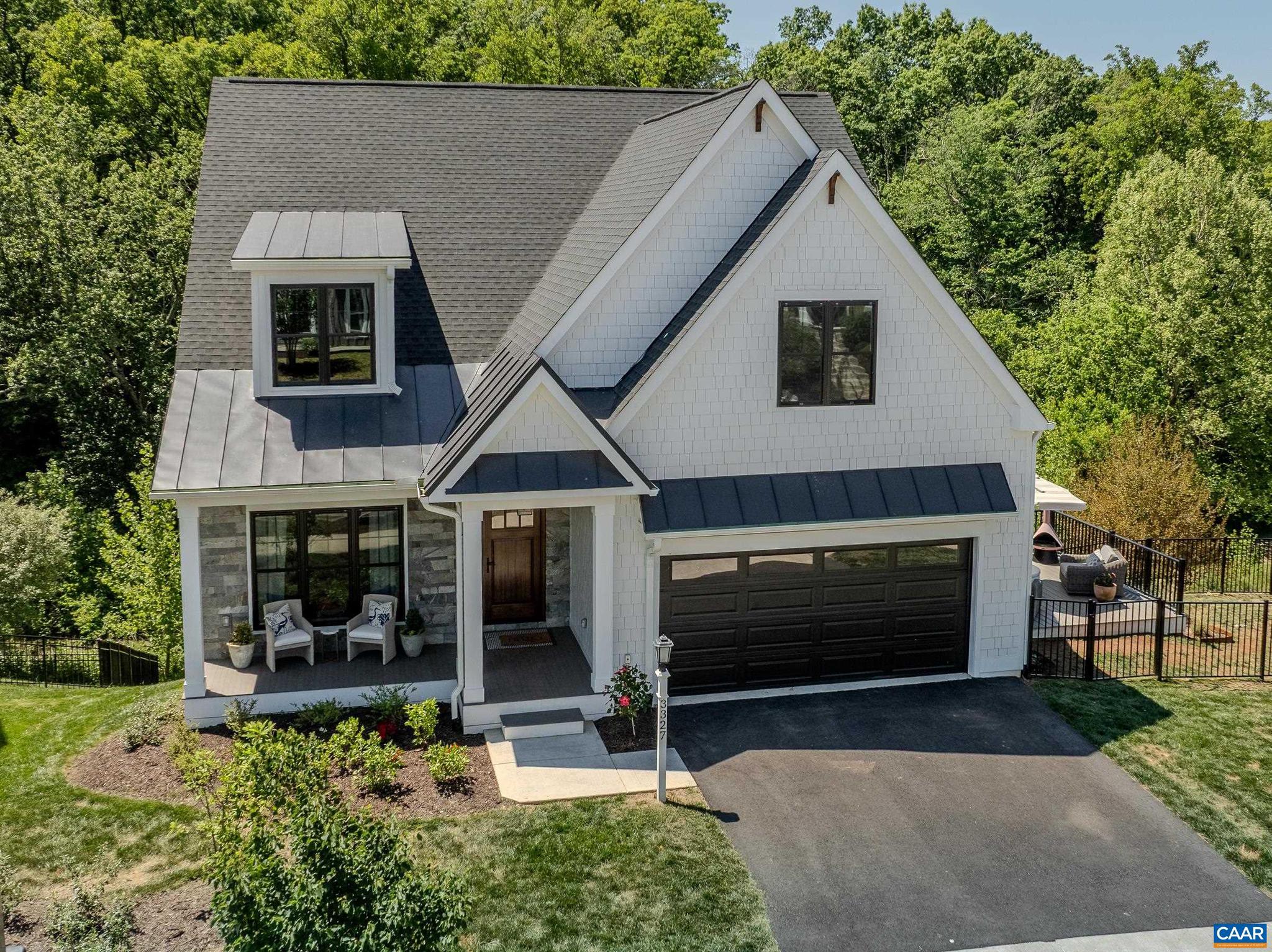 Like-new, stunning 3,700 sq ft modern farmhouse in Old Trail delivers 4 beds, 4.5 baths across three finished levels with designer finishes throughout. The soaring shiplap cathedral ceiling great room flows seamlessly into a chef's kitchen anchored by a La Cornue range, custom brass hood, Sub Zero refrigerator, quartz countertops, white oak island with farmhouse sink, walk-in pantry, and dedicated coffee station. The first-floor primary suite features a freestanding soaking tub, double vanity, and frameless glass shower. A dramatic home office with floor-to-ceiling built-ins, dining area, screened porch, and rear deck complete the main level. Upstairs, three well-appointed bedrooms share two designer baths. The finished basement is a true entertainment destination: a professional HD Golf simulator with movie theater and multi-sport packages - the same system installed in the private residences of top professional golfers worldwide - plus a full wet bar, recreation lounge, private bath, balcony, and unfinished storage space. Lennox HVAC, stacked LG laundry, oversized 2-car garage. Wooded walking trails behind the home offer privacy, Minutes to Downtown Crozet; 20 min to UVA and Charlottesville's Downtown Mall via I-64.