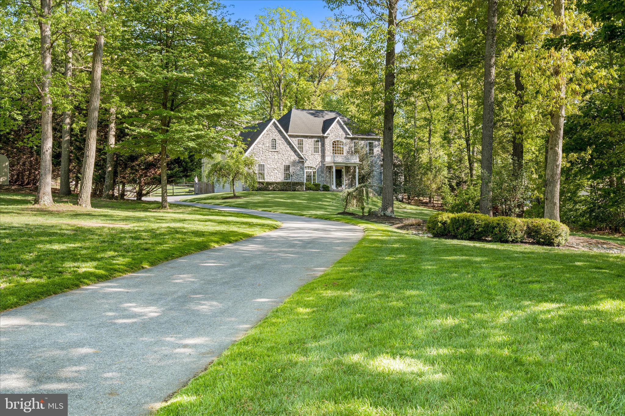 Price Refined! Welcome to 13903 Mitchell Court, an extraordinary luxury residence ideally situated on the highly sought-after Frederick County side of Mount Airy. Expertly crafted with timeless design, exceptional attention to detail, and upscale finishes throughout, this stunning home seamlessly blends elegance, comfort, and modern functionality. From the moment you arrive, the home’s impressive curb appeal sets the tone, featuring a striking custom stone elevation, professionally landscaped grounds with multiple electric access points in both the front and rear yards, and a welcoming covered entry. Step inside to discover a grand interior highlighted by a dramatic two-story foyer, 10-foot ceilings on all three levels, gorgeous hardwood flooring, abundant natural light, and an open, flowing floorplan designed for both everyday living and sophisticated entertaining. The main level offers beautifully defined yet connected spaces, including formal living and dining rooms perfect for hosting gatherings or enjoying quiet evenings at home. The spacious sunroom provides incredible flexibility and could easily accommodate a pool table, shuffleboard, grand piano, or simply serve as a tranquil sitting area surrounded by natural light and greenery. At the heart of the home, the gourmet chef’s kitchen is designed to impress, showcasing custom cabinetry, under-cabinet and in-cabinet lighting, granite countertops, premium stainless steel appliances, oversized center island with seating, walk-in pantry, elegant butler’s pantry, and seamless connection to the surrounding living and dining spaces. The adjacent breakfast room is flooded with natural light and features vaulted ceilings and stunning rounded windows that create an airy, elevated atmosphere. The inviting family room is anchored by a custom floor-to-ceiling stone wood-burning fireplace and complemented by expansive, thoughtfully designed living space ideal for entertaining or relaxing. A private main-level office with French-door entry provides the perfect work-from-home setup with both style and functionality. Upstairs, retreat to the luxurious primary suite featuring cathedral ceilings, a spacious sitting area with skylights and a cozy gas fireplace, two oversized walk-in closets, and a spa-inspired ensuite bath complete with a soaking tub, oversized Roman-style walk-in shower, dual vanities, and beautifully curated finishes. Additional bedrooms are generously sized and offer ensuite or convenient hall bath access, providing exceptional comfort and privacy for family and guests alike. The fully finished lower level expands the home’s versatility with an ideal setup for entertaining, extended stays, or multi-generational living. Highlights include a brand-new gourmet second kitchen, updated full bathroom with modern finishes, expansive recreation and living spaces ideal for a media room, gym, or play area, a fifth bedroom perfect for an in-law suite, and abundant storage throughout. Outdoor living is equally impressive, offering a private backyard retreat complete with a covered Trex deck, extensive hardscaped patio, permanent fire pit, and fully fenced yard surrounded by mature landscaping for added privacy and enjoyment. Additional notable features include a 3-car side-load garage with at-home electric vehicle charger, shed with electric, 400-amp electrical service, built-in surround sound, automatic lighted window candles, full water softener system, built-in shelving, brand-new double oven and refrigerator, and dual-zone HVAC systems replaced just two years ago. Conveniently located near Downtown Mount Airy, major commuter routes, shopping, dining, healthcare, and local favorites including Linganore Winecellars, Red Shedman Farm Brewery, and Black Ankle Vineyards, this is a rare opportunity to own a truly exceptional property where luxury, comfort, and lifestyle come together seamlessly. Schedule your private tour today.