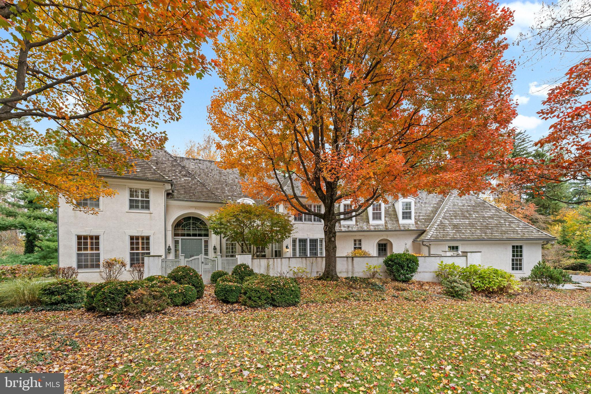 Welcome to 841 Mt. Moro Road, a beautifully crafted E.B. Mahoney home offering 5 bedrooms, 4 full and 2 half bathrooms in a scenic and private Villanova setting. Tucked along a quiet lane in Lower Merion Township, this move-in-ready residence blends timeless architecture with thoughtful updates and exceptional craftsmanship throughout. A stone walkway leads to a gated front terrace and covered entry, setting a gracious tone from the start. Step inside to a grand two-story foyer with a curved staircase and detailed millwork — a hallmark of Mahoney construction. Throughout the home, you’ll find extensive built-ins, decorative trim, and hardwood floors that unify each space. To the left of the foyer, a private home office features custom cabinetry, plantation shutters, and access to one of two main-level powder rooms. The formal living room offers oversized windows framing views of the tree-lined rear yard, a gas fireplace, and more built-ins. Through a wide cased opening, a sunlit sitting room provides the perfect nook for reading or morning coffee, with French door access to the rear deck. Designed for both daily living and entertaining, the formal dining room features arched windows, plantation shutters, and another set of French doors opening to the deck for effortless indoor-outdoor flow. The gourmet kitchen is anchored by a large island and abundant prep space, complete with granite countertops, Wolf, Thermador, and Sub Zero appliances, gas cooking, double ovens, and a generous pantry. The adjoining breakfast area opens to the front terrace — an ideal spot for casual meals or quiet mornings. The great room offers a soaring vaulted ceiling, built-ins, and a floor-to-ceiling brick hearth surrounding one of the home’s four gas fireplaces. A tiled mudroom connects the 3-car side-entry garage, includes a secondary powder room, storage closet, and convenient laundry closet with stacked washer & dryer. Upstairs, the primary suite serves as a true retreat with a Juliet balcony, sitting area, and a gas fireplace. The en suite bath features dual vanities and closets, a jetted soaking tub, and a step-in shower. Two additional bedrooms share a Jack-and-Jill bath, while the fourth is a spacious junior suite. The large main laundry room with Bosch washer & dryer, cabinetry and counter space completes the upper level, along with walk-up access to a floored attic with two cedar closets for additional storage. A rear staircase conveniently connects the upper level to the kitchen. The finished lower level offers incredible flexibility with a den and the home’s fourth fireplace, a private 5th bedroom or flex room overlooking the yard, a full bath, sauna, and a rubber-floored gym with walkout access. The unfinished areas provide abundant storage and utility space. Additional highlights include four-zone HVAC, a whole-house generator, and a central vacuum system. Perfectly located just minutes from Villanova University, top-rated Lower Merion schools, local shops, and major commuter routes, 841 Mt. Moro Road offers refined living in a highly desirable Main Line setting. **Please do not drive down private lane without an appointment.**