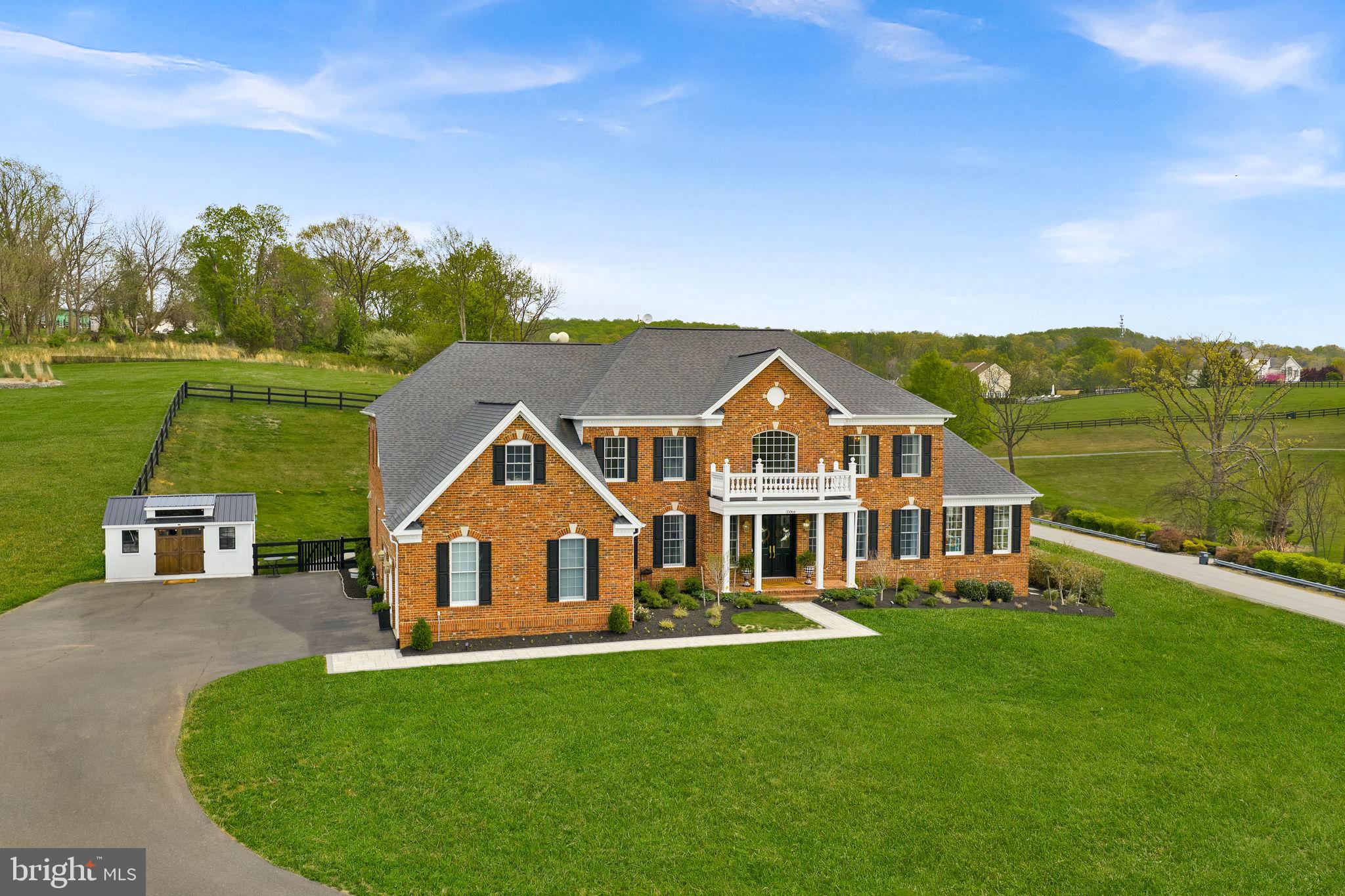 Price Just Reduced on this Gorgeous Estate with Blue Ridge Mountain Views set on 3.06 acres in Western Loudoun County . This exquisitely renovated estate offers nearly 8,300 square feet of luxurious living, thoughtfully designed to capture both natural beauty and architectural presence; offers the rare balance of peaceful countryside living with remarkable everyday convenience. Just minutes from major commuter routes ie. Rt 7, Rt 9, and the Dulles Greenway, the property is approximately 30 minutes from Dulles International Airport and within close proximity to shopping destinations such as Whole Foods, Wegmans, Costco, Target, Trader Joe’s, Leesburg Premium Outlets and more. Residents enjoy easy access to acclaimed wineries, charming floral gardens and flower farms, fine dining, schools, and the historic villages of Waterford and Leesburg.
A grand arrival begins with new double entry doors opening into a dramatic two-story foyer, where a striking double-sided curved staircase creates an unforgettable first impression. From this central vantage point, the home immediately reveals its scale and intentional design. Formal living and dining rooms gracefully flank the foyer, while a sun-drenched conservatory and expansive windows fill the home with natural light throughout the day. At the heart of the home, the gourmet chef’s kitchen is both sophisticated and functional—anchored by an impressive 11-foot island with seating and appointed with a curated suite of Café appliances, including a French-door wall oven, built-in microwave, French-door refrigerator, a custom vented hood, and 36-inch commercial-style gas range. The kitchen also features an expansive Breakfast Room area that easily accommodates a table for 12, as well as a built-in desk area that adds convenience for daily living. Designer lighting and hardware, marble tile and luxurious countertops complete the space, while the adjoining Sunroom and the Breakfast Area overlooks the grounds and opens to a new Trex deck, seamlessly connecting indoor and outdoor living and leading to a beautifully crafted flagstone patio. The main level is completed by a 2-story family room, back stairwell to the upper level, private office, mudroom, and laundry room, plus powder room, thoughtfully designed with elevated finishes to reflect the home’s cohesive sense of luxury.
Upstairs, the primary suite serves as a true private retreat, offering both scale and thoughtful design. The suite features a separate sitting area, a generously sized secondary walk-in closet (approximately 9' x 7') within the bedroom, and an exceptional primary dressing room accessed through the ensuite bath measuring approximately 24 feet by 10 feet—creating a boutique-style wardrobe experience rarely found in residential design. The spa-inspired bath is equally impressive, showcasing a freestanding soaking tub, dual vanities positioned opposite one another, TWO water closets, and a double walk-in shower—delivering a retreat-like experience within the home. Three additional bedrooms and fully renovated ensuite bathrooms continue the home’s elevated design throughout the upper level.
The fully finished lower level, spanning approximately 2,600 square feet, offers exceptional flexibility for multigenerational living and/or entertaining. This level features a second gourmet kitchen with a 10-foot island, expansive living and entertaining areas, a private suite with custom walk-in closet and ensuite bath, two additional bedrooms with shared full bath, storage, media room, and additional flexible spaces. Direct walk-up access provides seamless connection to the backyard. Outdoors, enjoy over 3 acres of peaceful countryside, including a 1-acre fenced yard with a county-approved pool fence and gates, offering both privacy & future potential.
New: Hot Water Heater. 2 HVAC. Well Pump. Double Front Entry Doors. Hardscape. Workshop. Extensive Renovations. Plus more.
