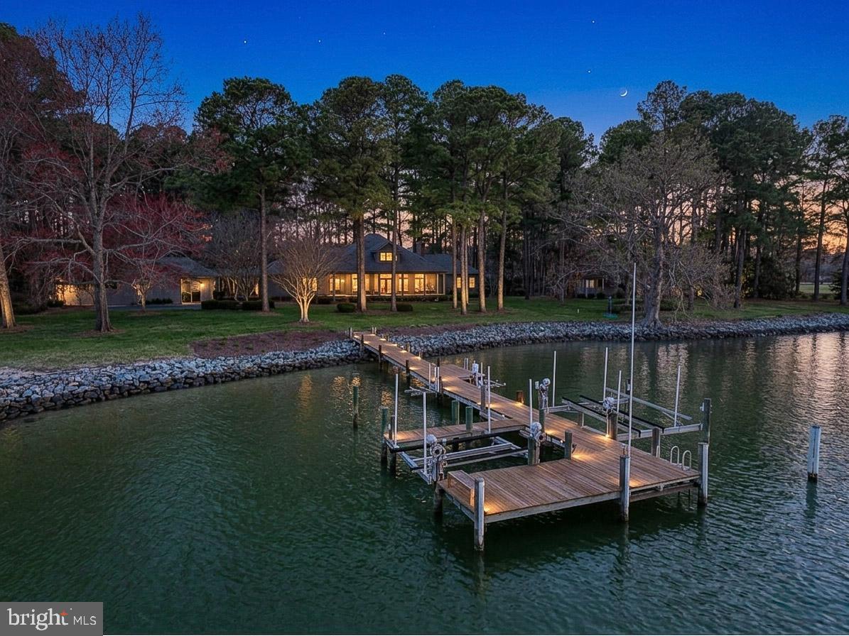 Experience refined waterfront living in this stunning Lowcountry-style estate, gracefully set on an exceptional waterfront lot among mature Loblolly pines with a coveted southern exposure.  Offering sweeping, unobstructed water views, and a rare sense of privacy, the property is bathed in natural light throughout the day, with breathtaking sunrises and and warm, golden reflections in the evening.
This 3,800 square foot main residence is complimented by a beautifully appointed 1,200 sq. foot guest cottage, creating an ideal balance of elegance and hospitality.  The guest cottage serves as a private retreat, complete with a comfortable living room, galley kitchen, three bedrooms, and a screened porch for quiet relaxation.
Inside, timeless craftsmanship defines every space, from reclaimed oak flooring to granite countertops and a meticulously maintained cedar exterior.
Outdoors, the lifestyle continues with resort style amenities, including a sparkling in-ground pool, hot tub, firepit and a private 120 foot pier with approximately 7 feet of depth at mean low water- offering effortless access for boating fishing, and enjoying the very best of waterfront living.

A rare offering where exceptional land, elegant design, and an unparalleled coastal lifestyle come together.