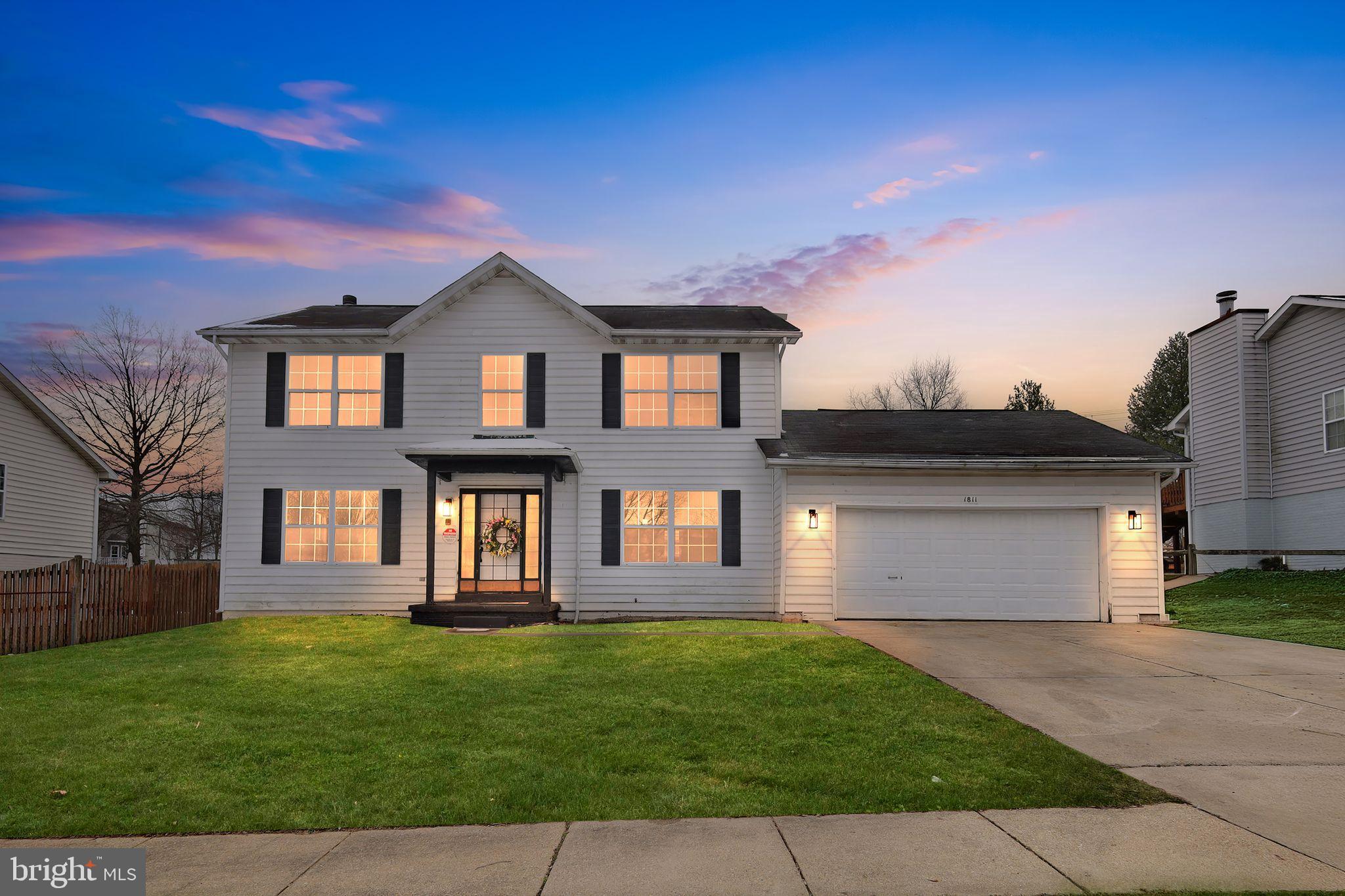 A modern three-story home showcases a clean white exterior complemented by a spacious two-car garage. Inside, the kitchen features crisp white cabinetry, sleek black countertops, artisan backsplash, and a striking gray marble island, all anchored by a gas range—ideal for both everyday cooking and entertaining. The open-concept layout seamlessly connects the kitchen to the living room, where warm wooden floors create a welcoming and cohesive atmosphere throughout the main living space. Three full bathrooms are designed with a spa-like feel, featuring elegant marble tile, a walk-in shower, a sunken tub, and a double-sink vanity for added comfort and convenience. The basement provides versatile additional space, complete with gray flooring and a distinctive accent walls, making it perfect for a variety of uses such as a home office, gym, spill-over sleeping spaces, or recreation area.