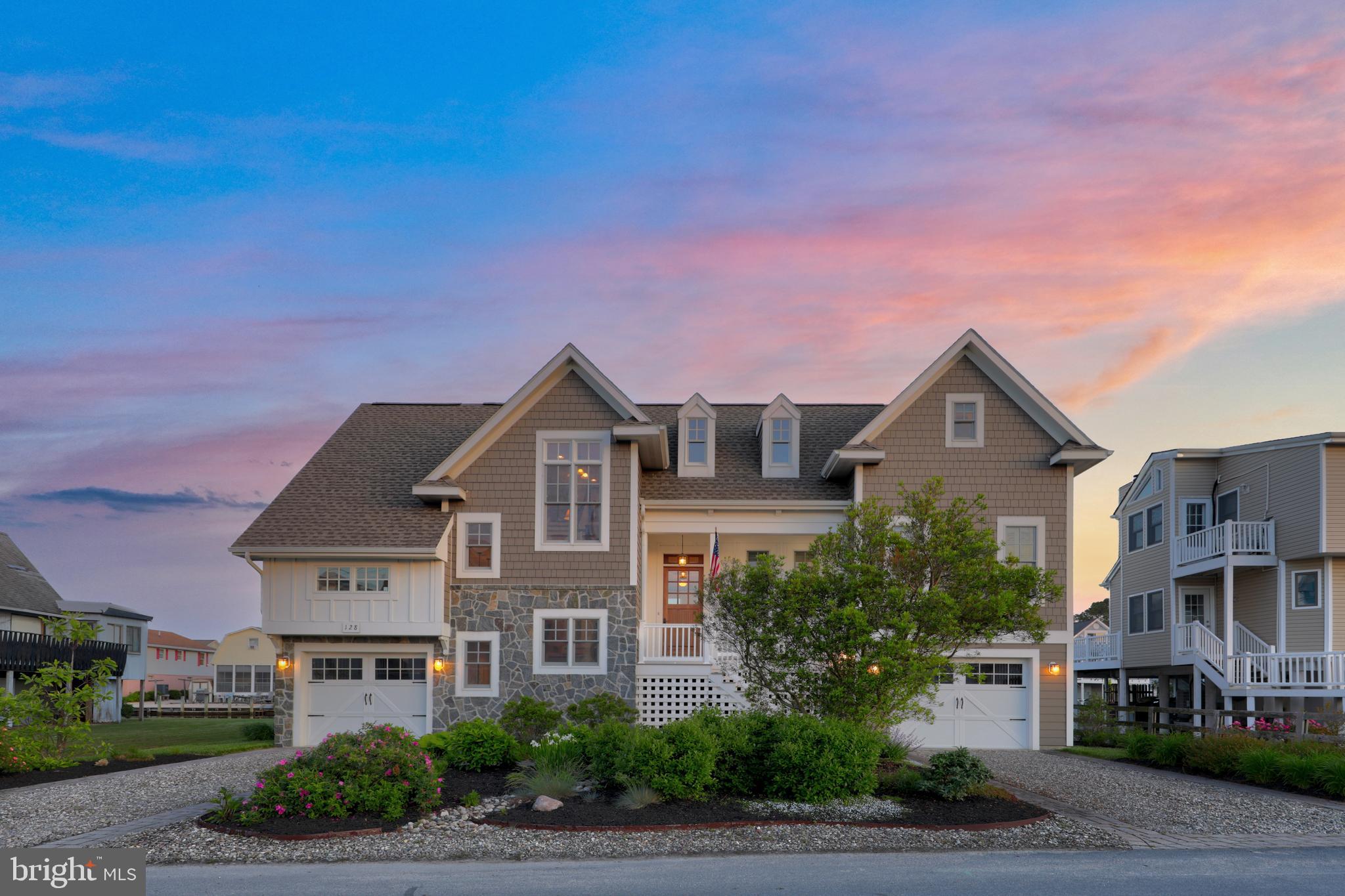 Introducing 128 Layton Drive, a luxurious waterfront residence nestled on an oversized bulkhead lot, just a short stroll from the pristine beaches of South Bethany. This custom-designed coastal haven showcases meticulous architectural details, stunning finishes, and open-concept layouts on each level, seamlessly blending indoor and outdoor entertainment spaces. Upon entering, you'll find a coastal retreat epitomizing luxury living. The main level features an open concept perfect for seamless entertaining, with milled wide plank character white oak floors unifying the space. A wall of atrium sliders floods the area with natural light, offers panoramic views, and opens to the expansive outdoor living space. The living room is centered around a floor-to-ceiling, raised-hearth fireplace, flanked by custom built-ins for displaying treasures and concealing less frequently used items. The gourmet kitchen is a culinary dream, featuring 42” custom display cabinetry that conceals and accentuates the built-in Sub-Zero refrigerator and double drawer dishwasher. Top-of-the-line appliances also include a Wolf 48”, 6-burner range with griddle and hood, and a drawer microwave. Granite surfaces extend across the kitchen, including a substantial island with custom built-ins and a breakfast bar, as well as a wet bar with a beverage fridge, wine storage, and a planning station for your next dinner party. No gourmet kitchen would be complete without a chef’s pantry and this kitchen does not disappoint offering an entire expanse of floor to ceiling custom storage options for all of your culinary gadgets, dry goods, and more! For dining, you have multiple options: the breakfast bar, the adjacent spectacular dining room, or the screened porch where you can dine while enjoying coastal breezes and waterfront canal views. The primary bedroom sanctuary features private balcony access, a make-up vanity area, a convenient wall safe, and a laundry center. The luxurious ensuite includes dual vanities, heated floors, a frameless glass shower, a walk-in closet with custom storage, every surface and finish in this oasis accentuates the lavish experience. The upper level, accessible by elevator or the switch-back staircase off the foyer, includes a family room perfect for movies, games, or enjoying Delaware sunsets from the balcony. A second primary bedroom offers private balcony access and a well-appointed ensuite with premium finishes. Two additional guest bedrooms, a hall closet plumbed for a second laundry, and a deep storage closet with additional finished storage complete the upper level. The outdoor living experience boasts three levels of balconies and covered patio space designed for grand entertaining and embracing the coastal lifestyle. The ground level features a spacious covered patio area with zones for dining, lounging, and enjoying the homes waterfront location. Multiple secure storage areas, a dedicated workshop with a workbench and shelving, an outdoor shower, and two separate garages provide ample space. The foundation level was constructed in accordance with flood regulations giving you peace of mind for years to come. The rear yard offers 75 feet of bulkhead canal front, a private boat lift, and a green expanse for enjoying coastal life to the fullest. Schedule your appointment now to experience the charm and luxury of this waterfront gem firsthand.