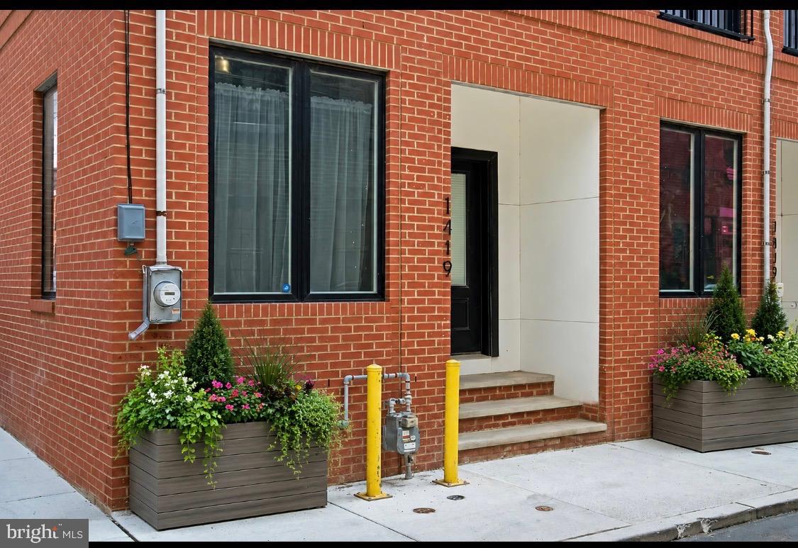 **1419 Orange Street | Refined Luxury in the Heart of Fishtown**

Tucked along one of Fishtown’s most charming and secluded streets, 1419 Orange Street is a distinctive end-of-row residence that seamlessly blends sophisticated design with modern city living. Bathed in natural light from an abundance of side-facing windows, this exceptional 3-4 bedroom, 4 bath home offers a rare sense of openness and privacy.

The main living level is designed for both elegant entertaining and everyday comfort, featuring soaring ceilings, wide-plank light oak hardwood flooring, and an airy loft-inspired aesthetic. The spacious living room flows effortlessly into a generous dining area and a beautifully appointed chef’s kitchen, complete with premium KitchenAid appliances, sleek flat-panel cabinetry, quartz countertops, and a substantial center island with seating.

Just beyond the kitchen, a private fenced courtyard provides the perfect setting for al fresco dining, summer gatherings, or a peaceful retreat for pets and their owners alike.

The second level offers two generously proportioned guest suites, each with its own en-suite bath and custom-designed closets. The front suite is enhanced by French doors opening to a Juliet balcony, creating a charming European-inspired ambiance overlooking the picturesque street below. A dedicated laundry room with side-by-side Electrolux appliances and custom storage completes this floor.

Occupying the entire third level, the primary suite is a true sanctuary. The spacious bedroom enjoys soaring ceilings and captivating city views, while the custom dressing room is thoughtfully designed with extensive built-in storage and bespoke closet systems. The spa-inspired bath features Carrara marble mosaic flooring, a frameless glass shower, dual vanities, a private water closet, and a luxurious soaking tub designed for relaxation.

Above, the expansive rooftop terrace showcases breathtaking skyline and bridge views, offering an extraordinary setting for entertaining or enjoying Philadelphia’s spectacular sunsets.

The finished lower level provides exceptional flexibility and can serve as a fourth bedroom suite, media room, fitness studio, home office, or playroom, complete with a full bath.

Ideally positioned just moments from Fishtown’s acclaimed dining, shopping, and cultural destinations along Frankford Avenue, while offering convenient access to Center City, major highways, and regional transportation, 1419 Orange Street presents a rare opportunity to enjoy luxury living in one of Philadelphia’s most sought-after neighborhoods.

A sophisticated urban retreat where contemporary design, exceptional light, and an unparalleled location come together beautifully.

There are also three years remaining on tax abatement.