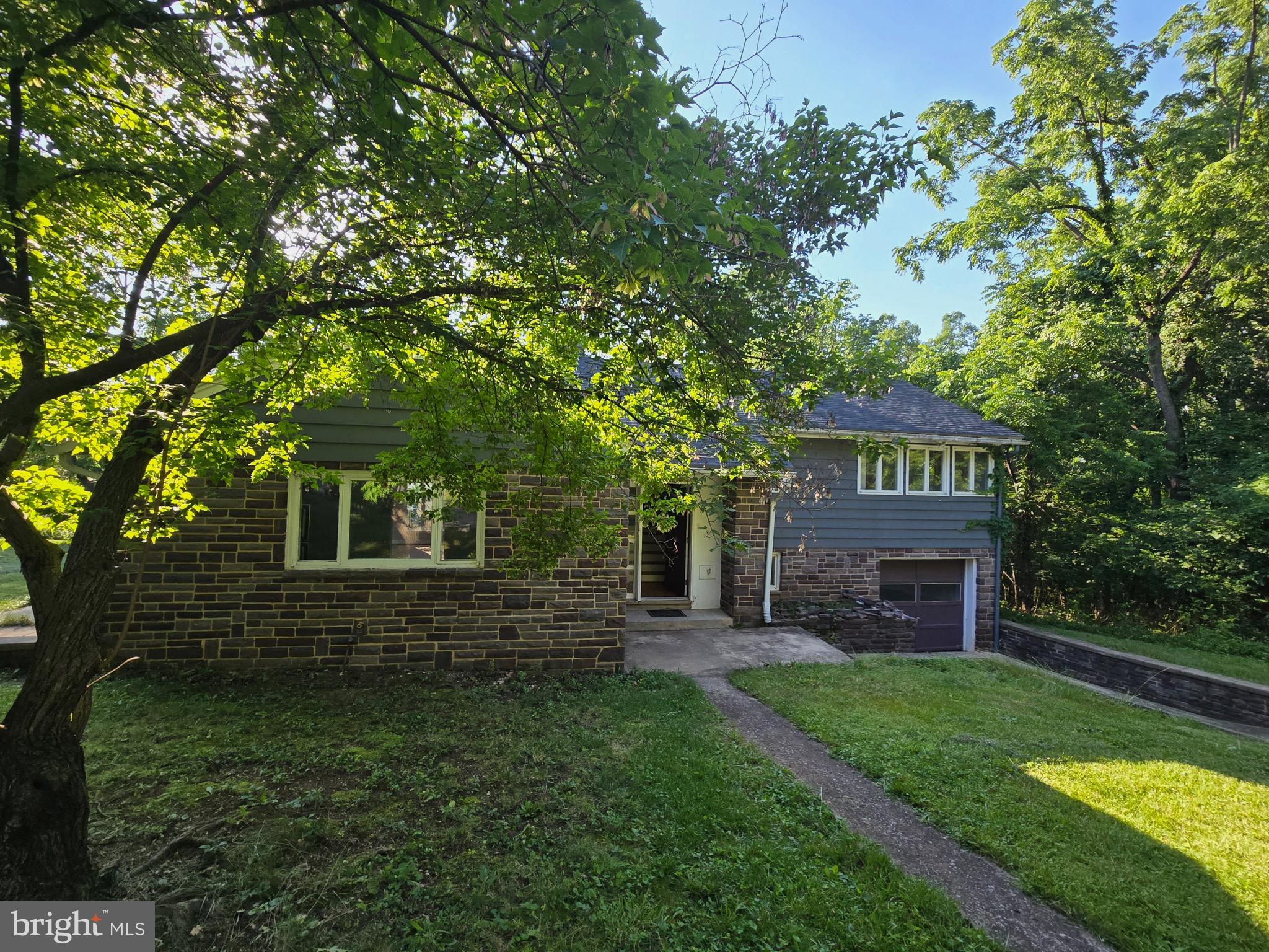 One of a kind, hidden gem in the heart of the Town of Woodstock.    This 4 BR, 2 Bath split level home with garage is perfectly sited on a private, 3.2-acre wooded homesite. A truly scenic vista located so close to the  the Town of Woodstock.  There is always something fun to do and enjoy in Woodstock--where vineyards, hiking,, fine restaurants, and quaint cafes are located very nearby.  The Valley Health Shenandoah Hospital is located across the street.  You love to explore your own nature trails and also visit the Indian Spring Wetland park directly across the street.   Grocery, banks, quaint dining, and recreational opportunities are within minutes.  This home features an upgraded kitchen and baths, a newer roof in 2019, HVAC- furnace replaced in 2022.  This multi-level split home has a sunny primary bedroom with French doors leading to a private deck.  You'll love morning coffee or evening cocktails on the deck while enjoying the sounds of nature. Three additional bedrooms, including the attic space, which will easily serve as a home office.  The living and dining room open with French doors to a patio--ideal for entertaining.  The living room has a wood-burning fireplace with built-in bookcases on either side.  Gleaming hardwood flooring is found in this area, as well as in the 3 bedrooms.  The upgraded kitchen is a chef's delight with custom cabinetry, upgraded countertops, ceramic flooring, and stainless steel appliances.  Now is the time to discover this private oasis located in the heart of the Town of Woodstock within the beautiful Shenandoah Valley.  The property is a mix of ferns, mature hardwood trees, a meandering stream and a cleared lush lawn.  Wildlife abounds with new fawns frolicking through the yard.  A natural stream originates on the property and runs to the Indian Spring Wetland Park area. Huge rock and boulders dot the landscape throughout the woods.  You can expand the house--consider all the opportunities to design and build out this property to your absolute heart's content.  Schedule a Tour today!