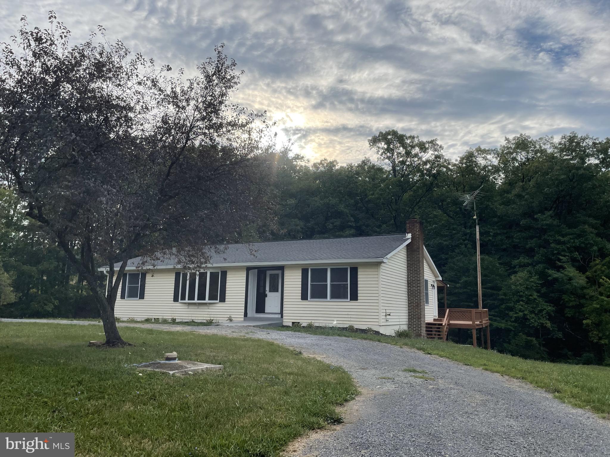 This meticulously reconditioned home is waiting for you to call her home. She is BEAUTIIFUL! She offers you the best of all the worlds. She sits 2 minutes from the Berkeley County Line in Hedgesville on the Morgan County Side. She offers you 2.583 unrestricted acres of pure, clean living. She has a circular driveway  for easy access.  She is maybe a 7 minute drive to public access of the Potomac River.  She also has a secondary driveway for overflow parking and a pad for a 24X24 detached garage if you choose to add one when she is yours.  Aside from her beautiful new door, she also has a door which provides direct access to beautifully appointed kitchen with an island and wine bar (all stainless steel appliances).  Around the corner from the kitchen is a hallway which will connect you to the family room. The family has beautiful faux exposed beams, remote control ceiling fan with lights and access to your deck which is the full length of the house offering panoramic views of you wooded back yard. Coming in from the front door you have a full size coat/storage closet and your formal living room to the left and a formal dining room to the right with a beautiful modern chandelier. Who said country living could not be fancy? The home further offers 3 very comfortable main level bedrooms and two very well appointed bath rooms. Downstairs you get to experience open comfortable spaces as well as a very spacious full bath and another bonus room which could be an office. You access to your back yard via a walk door as well as a very ample storage area and generous mechanical room. No one piece of carpet through out this home.  Talk about a clean home.  This home has it ALL! Convenience, Comfort, Well Appointed and Well Priced. Best is there is no HOA and your neighbors are super friendly. She is definitely on e of the prettiest girls at the ball. Please call for your appointment and be very pleasantly surprised. She will not be single long.