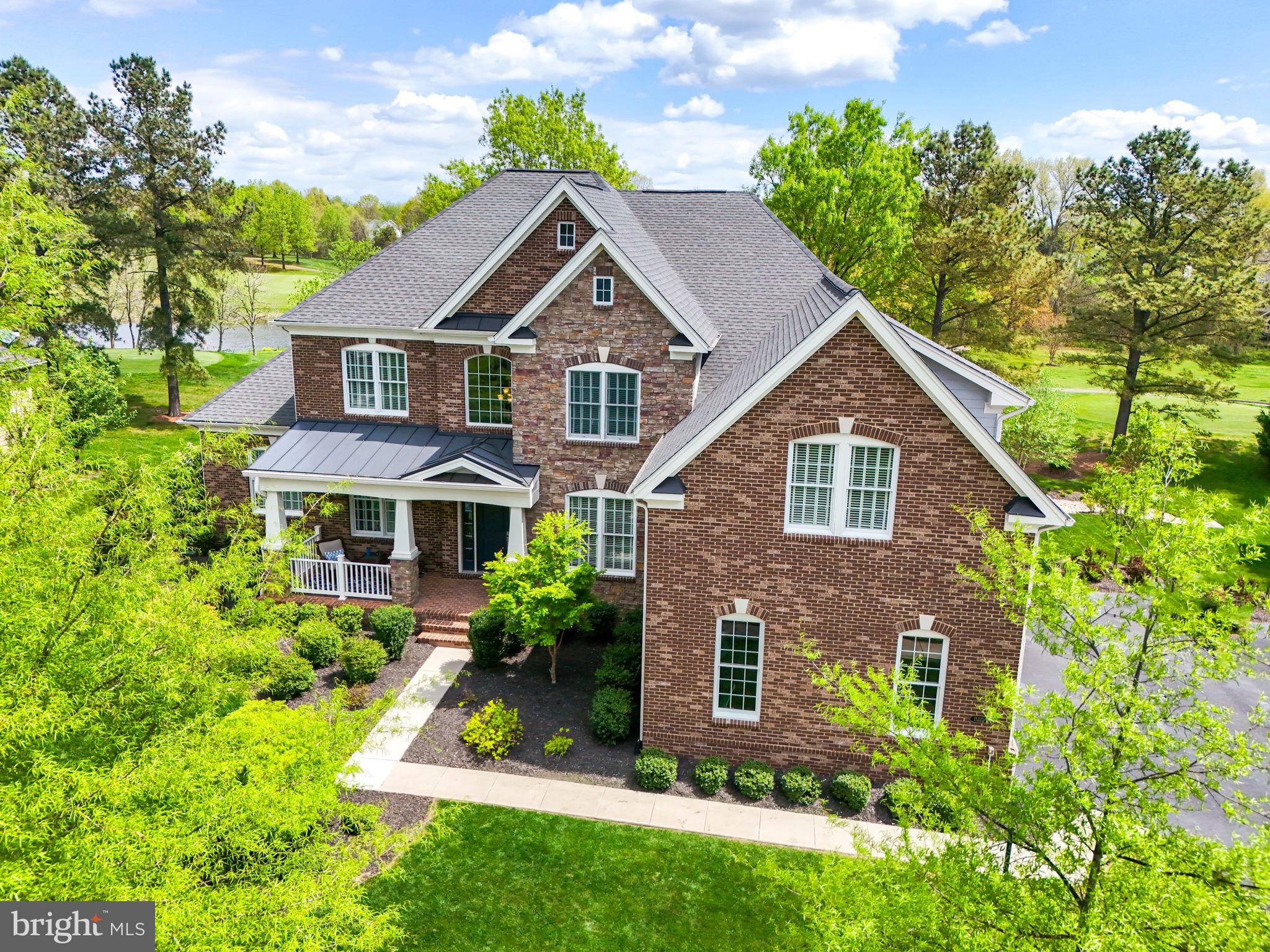 Welcome to luxury living in Dominion Valley Country Club, an exclusive gated golf course community where elegance meets modern sophistication. This stunning 7-bedroom home highlights unparalleled features, perfect for those families seeking a blend of comfort and functionality. As you step inside, you are greeted by a spacious main level, featuring  a private owners retreat with attached sitting room, perfect for convenience and relaxation.  The upgraded trim package and custom paint color, as well as high ceilings and doors add a sense of grandeur to every room. The heart of this home is its gorgeous kitchen, showcasing upgraded white cabinetry, top-of-the line stainless steel appliances, skylights that flood the space with natural light, and a large walk-in pantry for added storage and convenience.  Adjacent is a private office for productive work days and a separate dining room for elegant entertaining. The family room is spacious, with a floor to ceiling stone fireplace, Perfect for all your family gatherings.
The upstairs of the home has 5 bedroom, and 3 full baths.  The largest bedroom upstairs, could have multiple functions, as its SO large.  a bonus room, kids playroom , or work from home business space. It also has an en suite bath.  The other 4 bedrooms are set up Jack-n-Jill style. with the additional 2 full baths. Every bathroom has gorgeous granite countertops, and upgrading ceramic tiling. 

The basement is an entertainment haven, offering ample open space, as well as a dedicated movie room.  Additionally, there is a full bedroom and bath in the basement.

Step outside to enjoy gorgeous views of the 2nd tee box and the Arnold Palmer Signature golf course from your maintenance free deck and patio, complete with a built-in firepit and hot tub for ultimate luxury.   All this within walking distance to the country club and all the great amenities DVCC has to offer. The home has a beautiful brick facade, as well as a brick wrap all around the foundation of the home. A three car side-load garage, as well as plenty of room to park an additional 5 cars in the driveway. An underground 6 zone sprinkler system. 

Dominion Valley isn't just a neighborhood, its a lifestyle.  There is an indoor pool to use year round, an indoor basketball court, 4 outdoor pools to choose from, lighted tennis and pickleball courts, miles of walking/biking trails, tot lots, 18 hole golf course, award winning swim team for the kids to join.  All the schools are located within the neighborhood,  and easy access to I-66 and commuter routes into the Washington DC area.