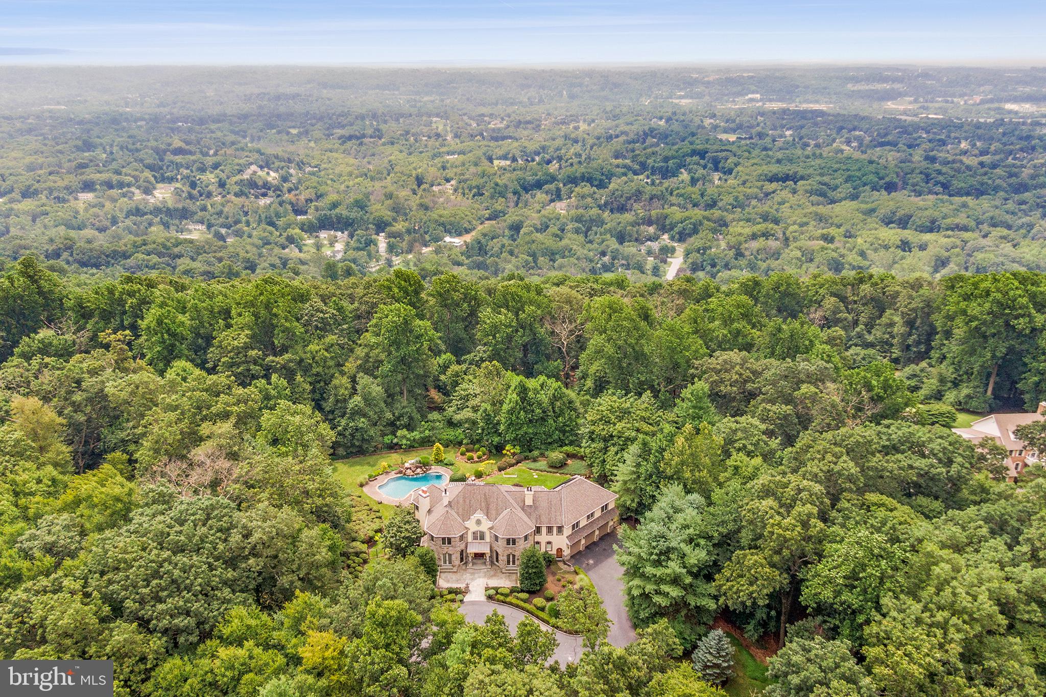 1900 Chautauqua Trail, even the name sounds rich with history and luxury. This mini estate sits
on 6+ acres in the award-winning and highly sought-after T/E School District. This exceptional
property offers 4 beds (one of which is a 2-room suite!), 5 full and 2 half baths, and over 7000+
sq. ft of living. Outside, admire the professionally landscaped property with a circular driveway to
the welcoming custom front door. Enjoy outdoor living at its best with a custom inground pool, a
waterfall and spa, and multi-level patios and walkways, all accented by tasteful landscape
lighting. This is your own year-round retreat located at the end of a quiet cul-de-sac in Malvern,
near the historic Octagon school house and Wharton Esherick Museum.
Step inside to a dramatic two-story foyer with a baby grand piano, all open and overlooking the
spectacular lush outdoors of the home’s rear yard with valley views. The inside floor plan offers
the perfect harmony of everyday living and entertaining. The foyer leads to a large living room
with a stone fireplace, a built-in bench, and a wall of windows overlooking the rear yard with
year-round sunny views. Work hard or hardly in this first-floor office with a fireplace and French
doors leading to a front patio. The dining room is beautiful, with another gas fireplace and
French doors to a stone patio with sunset views. Adjacent to the dining room is a large butler
pantry with a wine fridge, sink, and lots of cabinetry.
The open and spacious kitchen is a chef’s dream, featuring top-of-the-line appliances, including
a Viking range and ovens, a warming drawer, a full-sized Subzero refrigerator and freezer, a
Bosch dishwasher, a built-in microwave, and more. There is an oversized island and a breakfast
room area with walk-out access to the stone patio (perfect for grilling and alfresco dining!).
There are two access doors to the garage with a large mudroom and half bath and another door
from the garage leading to the finished lower level. The garage is oversized and features
beautiful wood doors with electrical hook up for EV car charger, sink, workstation, and more.
The lower level is fully finished, with ground-level outside access to the pool and yard. There is a
family room with another stone fireplace and a full wet bar with a sink, fridge, dishwasher, and
game room area. This level also includes a full bath with a steam shower and sauna. A theater
room with movie-style seating and a large screen offers the perfect in-home entertainment.
Upstairs in the living quarters, the primary bedroom offers its own retreat with double doors,
vaulted ceiling, gas fireplace, new sliding doors to a secluded deck overlooking rolling hills and
lush greenery with a retractable awning. The primary closet features an expansive organizing
system with island cabinetry and plenty of room for all seasonal clothing. The bathroom features
a soaking tub, a large walk-in shower, two vanities, and circles around with two entryways. The
second bedroom down the hall offers an en-suite bath with tub/shower combo and a walk-in
closet with custom cabinetry. There is a second-floor laundry room near the rear staircase.
Beyond you’ll find two and/or three more-bedroom suites and two more full baths. There is a
staircase to a semi-finished third-floor attic, offering plenty of storage opportunities and room for
future bedrooms or living space if desired.
This home features green energy living with rear house solar panels that offer incredibly low
energy costs year-round, a bonus to this beautiful resort-style living. No matter where you turn
on this property, you’ll be blown away by the style and sophistication, unbeatable views, and
deluxe amenities. Simply unpack and start enjoying resort-style living at its best!