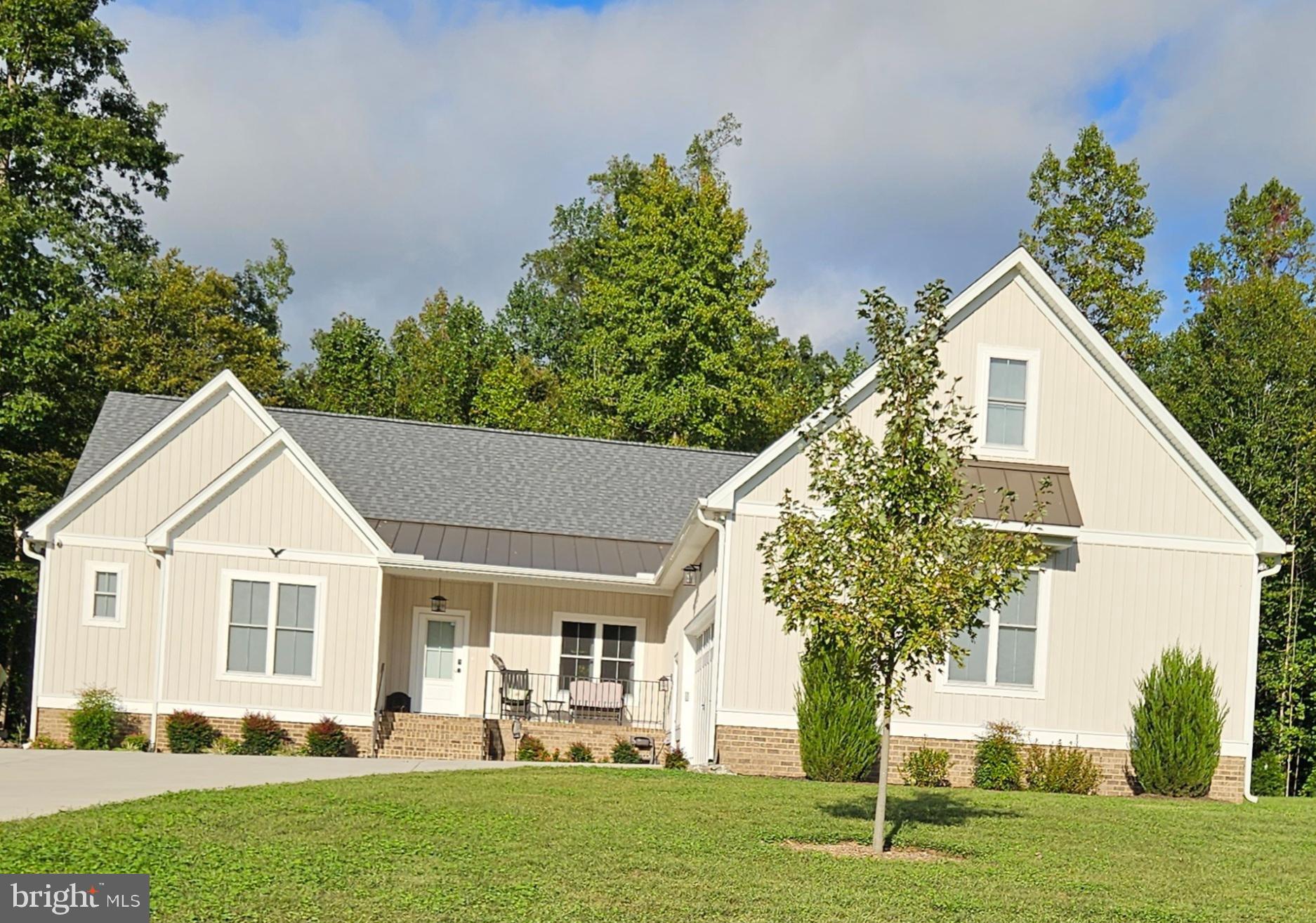 Welcome to this lovely 2325 sq ft custom-built 4 bedroom 2 bath ranch on 2.1 acres in Maplewood Forest community. It’s like new at just 3 years old. Located a mile off Route 360 with high-speed FIBER internet. Upon entering this one level open concept floor plan, you will enjoy the great room that opens to the kitchen and dining room with a split bedroom design and private wooded backyard. Additional features include an attached oversized 2 ½ car garage with extra room for storage or a work area with a wide concrete courtyard-style driveway. It also has a bonus room upstairs with a large insulated walk-in storage room. It has a completely conditioned crawl space and tankless water heater and is pre-wired for a generator with a transfer switch. Also is an owned buried 500-gallon propane tank for heating, cooking and hot water. Main living area has vaulted ceiling, ceiling fans, recessed & custom lighting, gas fireplace & custom built-in cabinets with bookshelves. This home has real ¾ inch hardwood flooring throughout with specialty floor tile in the baths and utility. All cabinetry is custom-made. The kitchen has custom cabinets with lighting, upgraded Italian quartz counters & oversized island with lots of storage and overhang for stools. It has gas cooking range, deep farmhouse sink, stainless appliances with vented hood exhaust & custom lighting. The master bedroom has large walk-in custom closet with wood shelves, hardwood flooring, ensuite bath with oversized glass ADA shower & double sink vanity. Opposite end of the home has two large bedrooms with walk-in closets that share a full bath with 5-foot ADA shower. The back porch is beautiful stamped concrete with a 12-foot cathedral A-frame ceiling w/ ceiling fan. Also is a stamped concrete patio with an outdoor shower for hot days and custom-built sauna for cold days. Perfect private wooded backyard. The laundry room and coat closet area are located between garage and kitchen. Come see this great property and all it has to offer!
