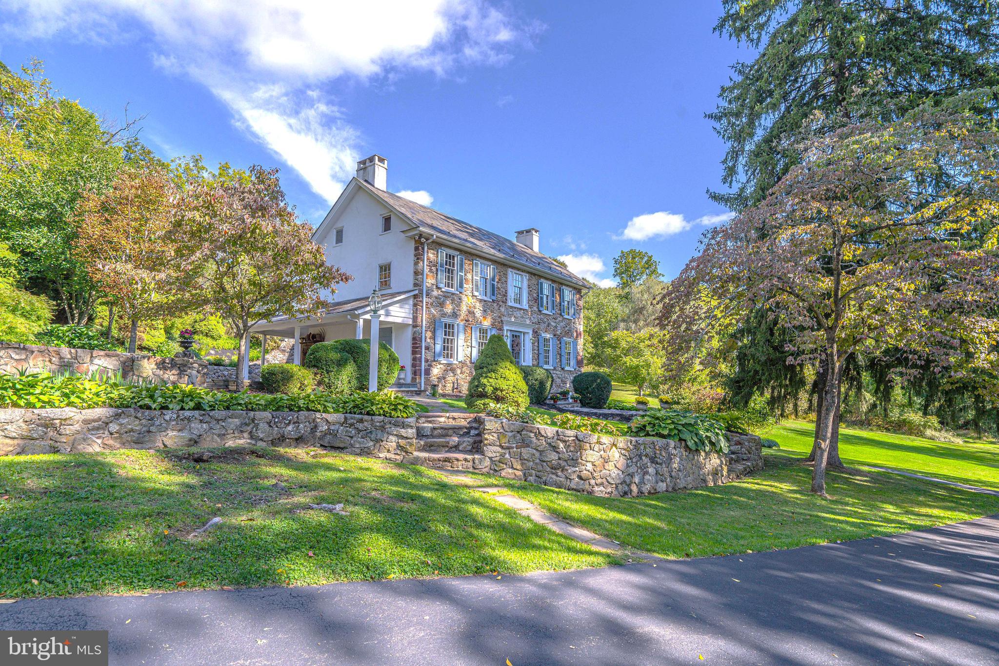 Nestled among twenty private acres of woods, lawns, and gardens, this elegant c1820 stone farmhouse began with just three rooms. Today, this sprawling home of over 4000 s.f. offers the perfect blend of intimate and grand spaces. The formal living room features a wood-burning fireplace, deep window sills, and access to a covered patio. With a beamed ceiling, wide-plank floors, and walk-in fireplace, the dining room is the heart of the home and perfect for festive dinner parties and memorable family gatherings. The library provides a quiet place to relax by the fire with a great book and your favorite drink. The sunny eat-in kitchen and family room are complemented by magnificent views of lush lawns, fruit trees, and perennial flower beds. 4 spacious bedrooms, 4 full & 2 half bathrooms, and 2 offices complete this home's interior. A lovingly-restored bank barn with stables, spring house, smokehouse, garage, and a small stream all add to the charm and beauty of this exceptional property.
