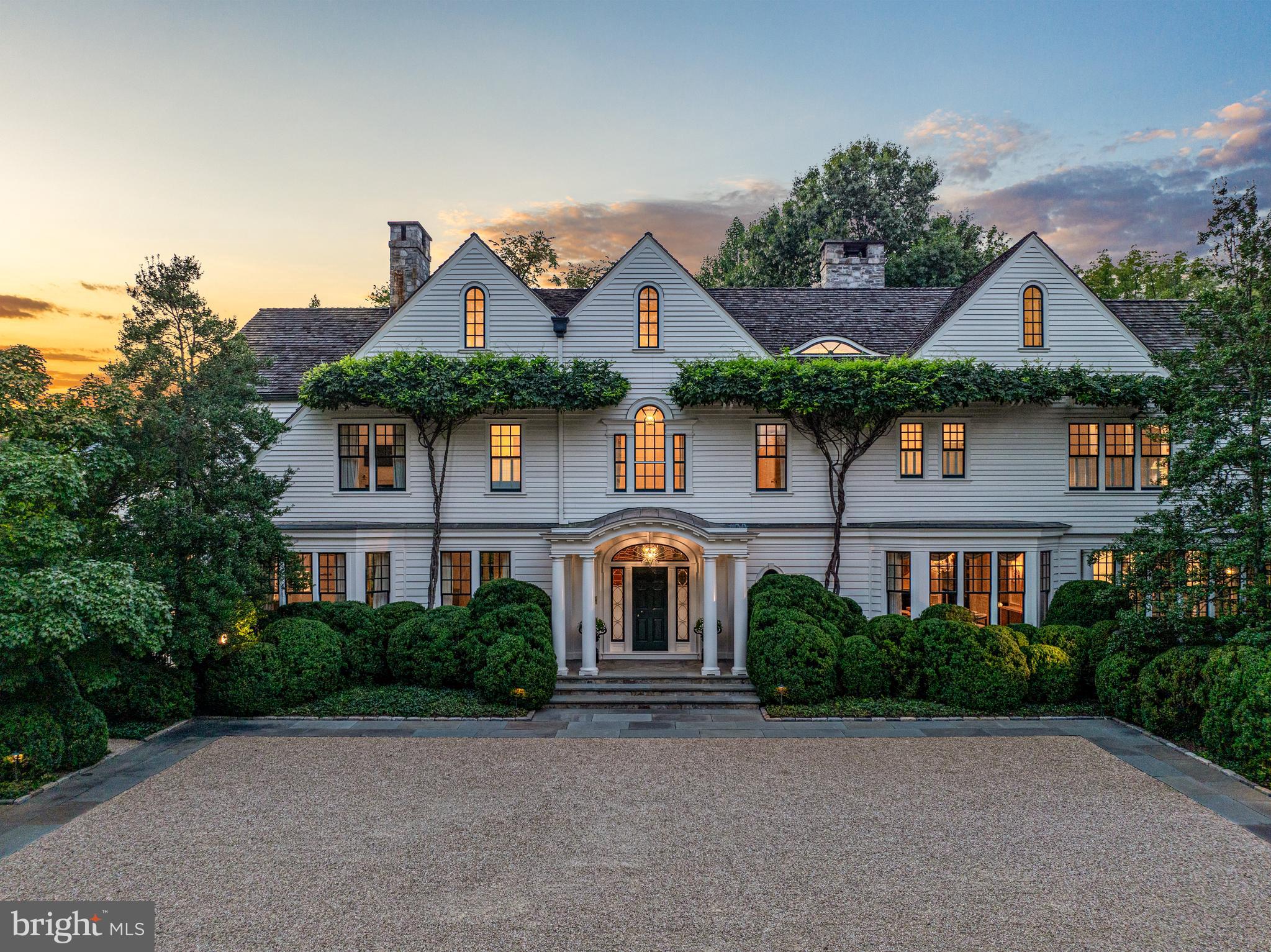 Located in the heart of prestigious Langley Farms, 1150 Chain Bridge Road exemplifies the timeless, understated elegance of the New England architectural style.  A subtle stone wall covered with ivy embraces the estate and sets the stage for the exceptional landscape beyond.  Gates open to reveal a carefully curated sequence of natural rooms, replete with boxwoods and specimen trees, which eventually reveal the residence.  

The landscape represents the inspired talent of English born landscape architect, Peter Cummins, who worked for years with the owner to create what has been described as one of the most beautiful gardens in Washington.  The arrival court is finished with granite and carefully selected pea gravel to introduce the carefully curated specimen plants which compose a natural tapestry of color and texture.

A discrete stone path leads to the southern garden revealing the sublime pool and tea house.  Adjacent to the pool, stone walls frame the rose gardens which are filled with specimen plants collected from around the world.  A koi pond centers the rose gardens creating yet another moment of visual beauty.  

To the north, the expansive lawn reaches to the edges of the estate to create the perfect place for a game of croquet or garden party.  These outdoor rooms were specifically designed to provide multiple venues for outdoor entertaining as well as a place to play, stroll or simply stargaze with friends and family.

Upon acquiring the estate in 2000, the current owner engaged renowned Boston interior designer, William Lewis Hodgins, to lead a multi-year effort to create timeless and elegant interiors. The house was effectively rebuilt from the inside out to perfect the scale and flow of the rooms in a manner which is evident immediately upon entering the front door.  Hodgins worked closely with the New York firm of Fairfax and Sammons to detail the proportion and order of not only the rooms, but also the extensive yet understated millwork throughout the residence.  The finely executed project was prominently featured in a number of books and publications, including Architectural Digest.

Few estate residences in Washington capture the perfect flow and proportions found at Chain Bridge Road.  The reception hall flows the width of the residence and provides the ideal point of introduction to the public rooms beyond.  A gracious living room centers on a fireplace encased by an antique mantle piece from France.  Just beyond, double doors reveal a library with built-in bookcases and another fireplace with an understated stone mantle piece.  On the south end of the residence, a semi-circular garden room overlooks a southern terrace and the garden beyond.

In the center of the house, an expansive kitchen affords space and amenities for the most ardent chef.  The kitchen is flanked by a comfortable breakfast area on one side and a generous sitting area and work station on the other.

A wide, gentle staircase leads to the private family bedrooms, including the primary suite which spans the southern end of the house.  Double dressing rooms with custom wardrobe closets and cabinets are positioned beyond double doors.  The primary bedroom is enveloped in a quiet mural depicting the Virginia countryside.

On the lower level, an expansive gathering room centers on a fireplace and wet bar.  An adjoining game room and exercise room benefit from french doors leading to the garden.  A full cabana bath and changing room is equipped with a sauna.  This level also features exceptional storage rooms for seasonal decor and the option of adding another full bath.  

The estate features impeccable systems, including medical grade HVAC, extensive security, and a whole house generator.  Above the garage, an expansive suite with a living room, bedroom and full bath is accessible via a separate entrance providing staff quarters or a family office.  Located just minutes from Washington, Chain Bridge Road is a timeless estate with no peer.