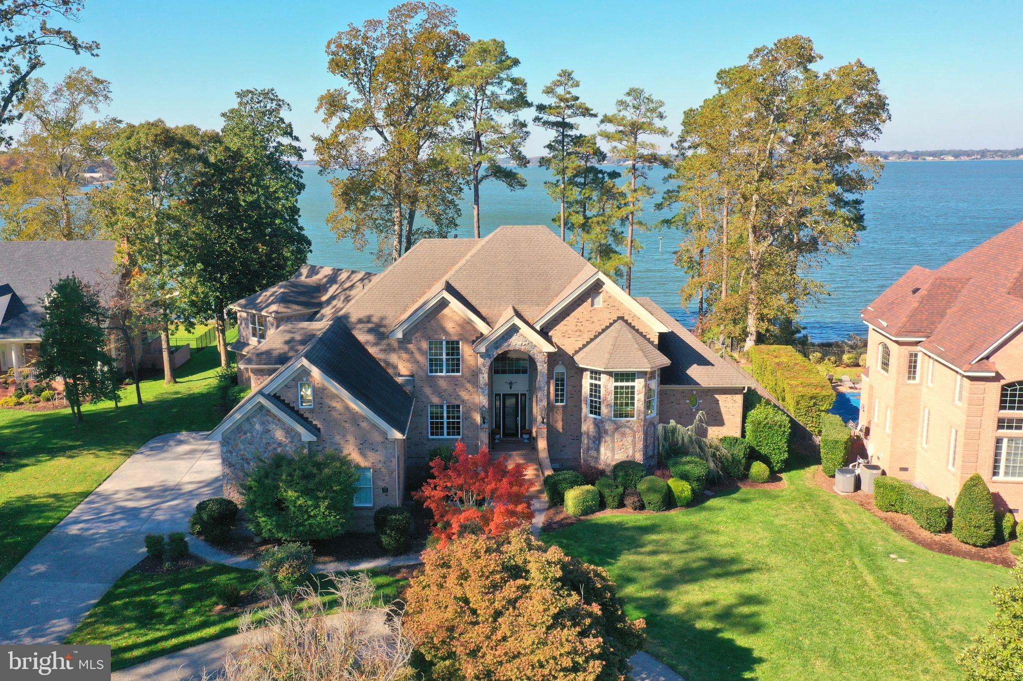 Opportunity knocks, priced  below appraisal!  Just in time for fun on the water!  Waterfront perfection with breathtaking panoramic views of the scenic Nansemond River.  Ideally situated on a premiere lot designed to maximize the majestic scenery in coveted The Riverfront at Harbour View .  Upon entering the two and a half level foyer you are greeted by panoramic water views from floor to ceiling windows. Custom built for the current owners by acclaimed Eric Sasser Construction, this almost 7,000 sq. ft home, boasts 6+ bedrooms, 4 full and 2 half baths with exceptional attention to detail throughout.  

Entertain in style and ease from the open concept gourmet kitchen with island and large eat-in dining area with stellar views. The kitchen flows into the formal living room with a handsome stone fireplace (gas) and formal dining room with lots of light perfect for large gatherings.  A spacious Great room features floor to ceiling windows providing breathtaking water views and a soaring stone fireplace (gas) creating a captivating focal point.  The large screened in patio off the gourmet kitchen is perfect for dining al fresco and entertaining and has been customized with electric storm shutters. The main level of this home further extends to two primary suites on each end of the home  with shower and separate jetted tub in the primary bath and a second primary bedroom suite with stand up shower.  A forward thinking built-in elevator shaft, designed to run from the garage to the main and upper levels of the home, is installation ready.  A versatile library, study or home office is located mid level up the impressive side hall staircase. 

The expansive upper level of the home features four bedrooms, two full baths and one half  bath, a separate steam room/spa and a large recreation or sitting area with french doors opening to a spacious terrace featuring more fantastic water views.  Re-enact your most beloved operas and theater from the interior half moon "Juliet" balcony overlooking the main level great room and a picturesque view the the Nansemond River.  Large studio or home office is located mid level and accessible through the upper level, main level or a private side entrance.   Plenty of storage, closets and custom built-ins throughout home.  Walk-up stairs to unfinished attic.  Multi-zone top of the line HVAC system is four years young. 

Fully landscaped backyard features a porch, brick terrace, fire pit and fenced elevated spa area for relaxing while watching the activities and wildlife on the Nansemond river.  Step out onto the upper terrace or stroll down the brick walking paths to the illuminated pier to experience spectacular sunsets and photograph majestic native waterfowl and dolphins swimming in the river.  Other features of this home include a circular driveway and side loading three car garage with access to the elevator shaft, kitchen and private office/loft.  
An expansive pier with built-in benches, a fish cleaning area and a boathouse with hydraulic boat lift rounds out this fantastic property.  Come for the views and sunsets and invest in your quality of life!

The award winning Riverfront at Harbour View community is a lifestyle.  

Located in the heart of Hampton Roads, fifteen minutes from Downtown Norfolk and the Peninsula.  Community amenities include an 18-hole championship golf course (additional membership available), two pools, two fantastic clubhouses, an amphitheater and walking trails. Great local eateries and shopping options abound within walking or biking distance.