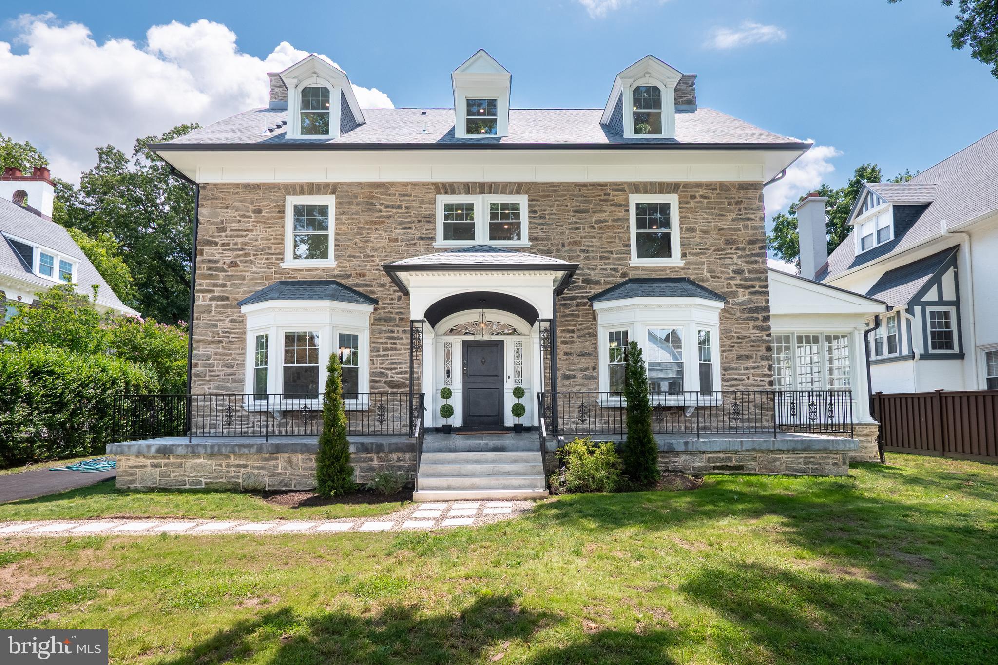 Among West Mount Airy's most distinguished historic stone residences, this extraordinary estate has been carefully restored for modern living. Gracefully positioned on nearly half an acre in one of Philadelphia's most sought-after neighborhoods, the circa-1890 residence pairs enduring craftsmanship with sophisticated contemporary design. Set among West Mount Airy's mature tree canopy, it enjoys an extraordinary setting convenient to Center City, a connection beautifully illustrated by the dramatic skyline views captured from above.

Built circa 1890 on land that was once part of the historic Upsala estate, the home has been thoughtfully updated while honoring its architectural heritage. Constructed of iconic Wissahickon schist, this stately residence is introduced by a gracious covered porch and inviting Dutch door, creating an unforgettable first impression. Inside, sun-filled interiors showcase soaring ceilings, beautifully refinished hardwood floors with walnut inlay, handcrafted millwork, fireplaces, French doors, deep window sills, and an elegant center hall staircase that showcases the craftsmanship of another era.

Designed for both everyday living and memorable entertaining, the main level flows effortlessly from gracious formal rooms to a spectacular chef's kitchen featuring custom ceiling-height cabinetry, premium appliances, an oversized island with a farmhouse sink, abundant workspace, and effortless flow to the dining room, living room, and light-filled sunroom.

The upper floors offer exceptional accommodations, highlighted by a luxurious primary suite featuring a spacious bedroom with a fireplace, a custom walk-through dressing room, a spa-inspired bath with a soaking tub, oversized walk-in shower, dual vanities, and a private water closet, along with an adjoining sleeping porch -an idyllic retreat for morning coffee, reading, or working from home. Four additional generously sized bedrooms, beautifully appointed baths, and a conveniently located second-floor laundry area provide flexibility for today's lifestyle.

The grounds are every bit as captivating as the interior. The expansive rear lawn, an increasingly rare offering within Philadelphia, provides endless opportunities for recreation, outdoor entertaining, and gardening. A detached stone carriage house, currently configured as garage space, offers remarkable versatility for vehicle storage, a workshop, artist's studio, fitness room, or future creative use.

Thoughtfully updated from top to bottom, the residence features a new roof, new HVAC, updated electrical and plumbing systems, and many new windows, allowing the next steward to enjoy the beauty of a historic home with the comfort, efficiency, and peace of mind expected today.

Life here extends well beyond the front door. Known for its vibrant sense of community, tree-lined streets, distinctive architecture, and welcoming spirit, West Mount Airy remains one of Philadelphia's most beloved neighborhoods. Stroll to neighborhood favorites including Weavers Way Co-op, local coffee shops, bakeries, ice cream shops, restaurants, playgrounds, and the library. Located just moments from SEPTA Regional Rail, bus routes, and the miles of trails through Wissahickon Valley Park, this location offers the perfect balance of neighborhood charm, outdoor adventure, and convenient access to Center City.

More than a home, this is a rare opportunity to become the next steward of a remarkable piece of West Mount Airy's history.