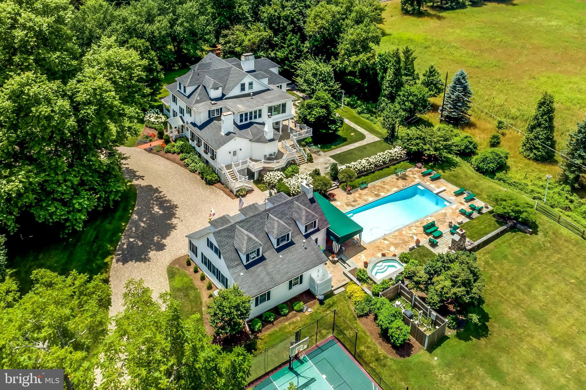 A warm six-bedroom Greenspring Valley home situated on two private acres with views of neighboring farm, pond and golf course. Historic elements blend with masterfully executed contemporary updates in this charming and inviting home. Indoor and outdoor entertaining spaces flow seamlessly - uniting light-filled formal rooms, sun rooms, comfortable casual spaces, spacious covered porches, and an expansive stone terrace surrounding a heated pool and spa, and outdoor fireplace. Grand foyer and timeless formal rooms feature high ceilings, wood burning fireplaces, exquisite mill work, display cabinetry and French doors leading to lush gardens. The gourmet kitchen with stainless appliances and new gas range opens to spacious breakfast and family rooms both with fireplaces. Handsome study, home office, and solarium offer quiet retreat. The spacious master bedroom suite features two baths and two dressing rooms near the second level laundry room. A remarkable guesthouse features great room with fireplace, complete kitchen, game room, bedroom, full bath and laundry. Sport court and level yard for play. Close to Metro Baltimore and minutes to I-695, great shopping and restaurants. Enjoy resort living at home!