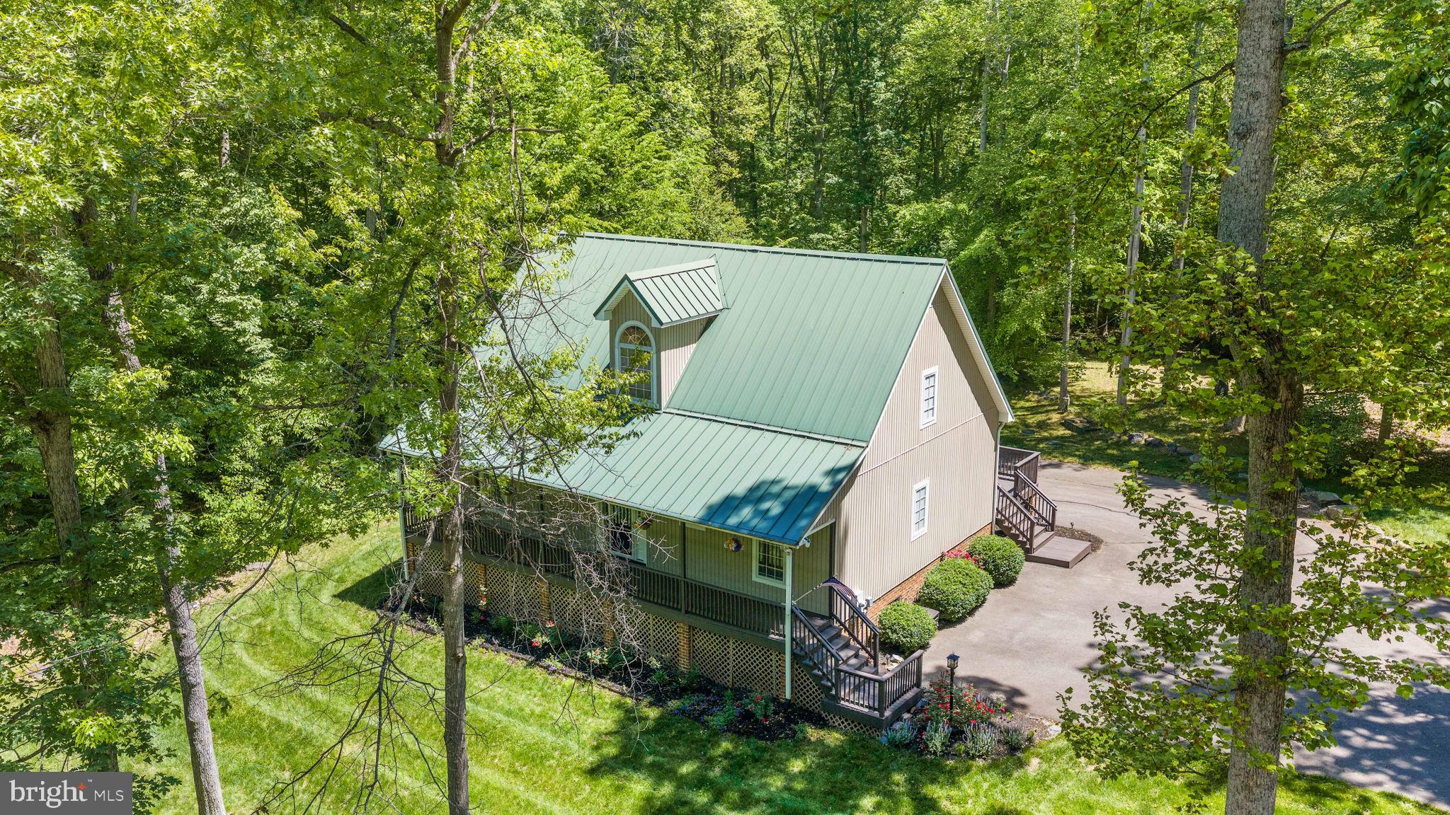 Beautifully maintained Lake Anna water-access residence located on the private side of the lake, featuring assigned boat slip #16 and situated within the desirable gated community of Oakleigh II. Residents enjoy access to exceptional community amenities including a waterfront common area with boat slips, private boat ramp, picnic area, and golf cart-friendly roads. Positioned on a serene .92-acre lot, this property offers the perfect blend of peaceful lake living and everyday comfort, ideal as either a full-time residence or weekend retreat. Thoughtfully designed with both functionality and entertaining in mind, this bright and inviting home offers 5 bedrooms, 3 full bathrooms (3-bedroom septic), and an open-concept floor plan filled with natural light. The spacious family room showcases vaulted ceilings and a corner gas fireplace, seamlessly connecting to the kitchen and dining area to create an ideal gathering space for family and guests alike. The main-level primary suite provides a relaxing retreat with a walk-in closet, stand-alone clawfoot soaking tub, and separate shower. Two additional bedrooms and a full bath complete the main level. Upstairs, two generously sized bonus rooms offer flexible living options perfect for guest accommodations, home offices, recreation space, or hobby rooms. The finished lower level includes a versatile flex room, full bath, utility area, laundry room, and an oversized 2.5-car built-in garage with ample storage. Additional features include Corian countertops, center island, tile flooring, central vacuum system, metal roof, extensive exterior lighting, mature landscaping, and a large, paved driveway.
Outdoor living is equally impressive with a full-length covered front porch, screened porch, and rear deck, providing multiple spaces to relax and enjoy the tranquil surroundings.  There is a list of recent property improvements. This exceptional Lake Anna property presents a rare opportunity to enjoy refined lake living in a highly sought-after community.