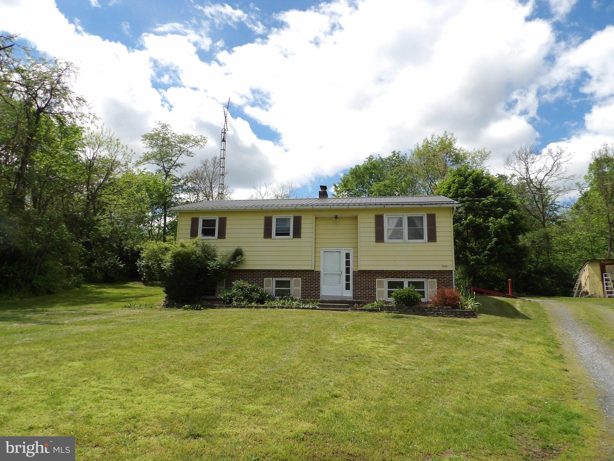 Discover this charming bi-level home nestled in a serene rural setting, offering stunning mountain views and a spacious lot of 0.7 acres. Built in 1980, this detached residence features a practical layout with 1,153 finished square feet, perfect for comfortable living. Step inside to find a cozy interior equipped with essential features such as ceiling fans and a combination kitchen/dining area, ideal for entertaining. The kitchen comes complete with essential appliances, including an electric oven/range, refrigerator, and washer/dryer, ensuring convenience for everyday tasks. A unique laundry chute adds to the home's functionality. The property boasts three well-sized bedrooms and a full bathroom, providing ample space for relaxation. The daylight basement offers potential for customization, with options for additional living space or storage, featuring windows and an outside entrance. Enjoy the outdoors with a gravel driveway accommodating up to four vehicles and a shed for extra storage. The replacement windows enhance energy efficiency while allowing natural light to fill the home. Located in a peaceful rural area, this property combines the tranquility of country living with easy access to nearby amenities. Whether you're looking for a primary residence or a weekend retreat, this home offers a perfect blend of comfort and potential. Don't miss the opportunity to make it yours!