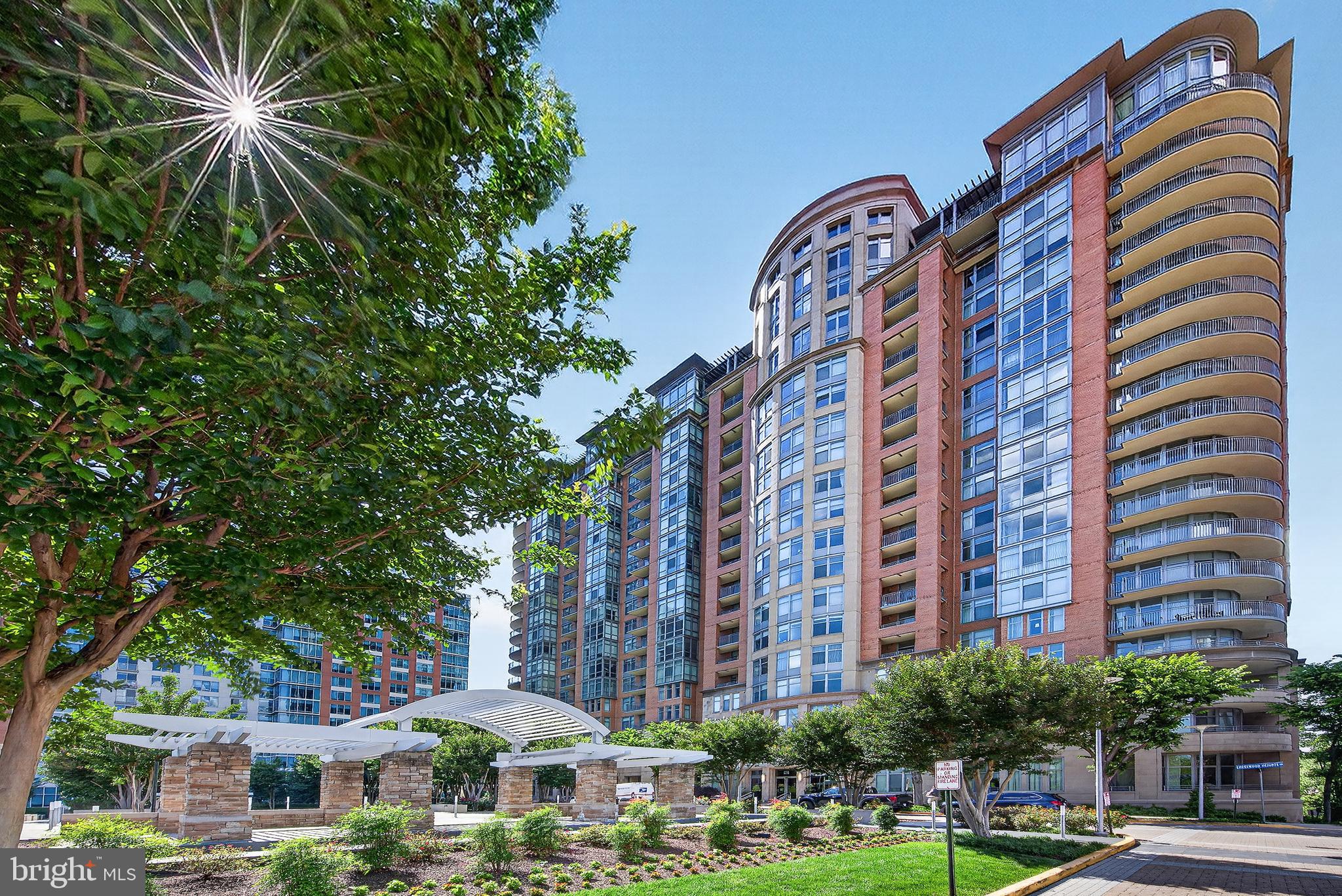 Rarely available corner unit at One Park Crest offering over 1,700 sq. ft. of luxury living and 2 coveted parking spaces just steps from the building entrance!  All of the panoramic windows overlook a huge open space grass areas.  Bright and spacious, this 2BR/2.5BA residence features floor-to-ceiling windows, hardwood floors, a curved private balcony, and an open-concept layout filled with natural light. The gourmet kitchen boasts 42" cherry cabinets, granite countertops, stainless steel appliances, a gas cooktop, and a wall oven. Spacious bedrooms with ensuite baths and generous closet space. New HVAC installed in 2024. Enjoy premier amenities including a rooftop pool(18th Floor), fitness center, party room(18th Floor), meeting room, and 24-hour concierge. Ideally located next to Harris Teeter and Starbucks, and minutes to Tysons Galleria, Tysons Corner Center, Metro, I-495, I-66, Route 267, shopping, dining, and entertainment.