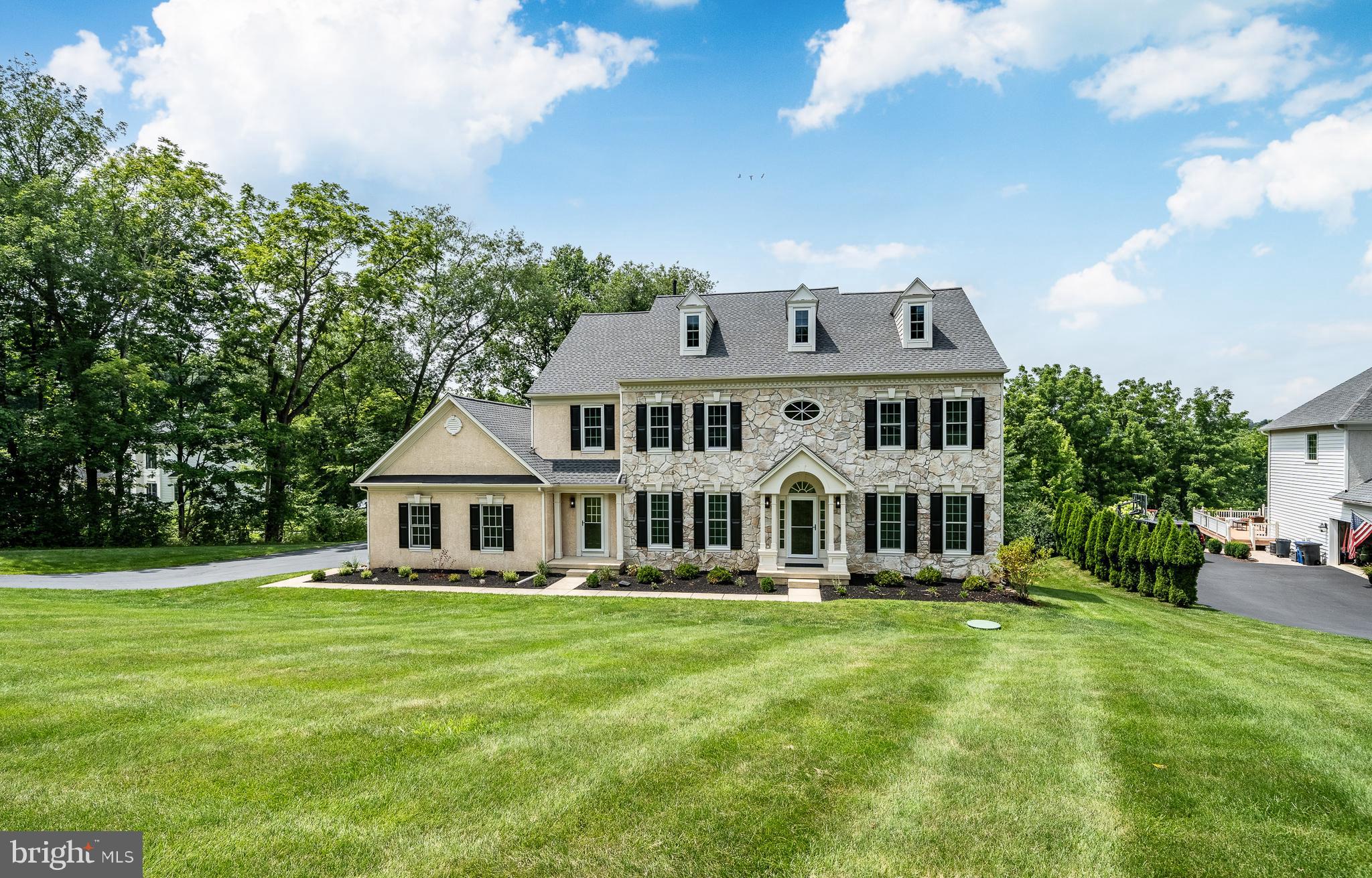 A rare opportunity awaits to live in Brandywine Overlook in this beautiful turn-key home.  The original owners have lovingly maintained and recently refreshed, renewed and updated almost everything!  It's the perfect combination of  country meets city where this grand home sits back on 1.4 sprawling acres  with mature trees,  fresh landscaping  and yet is only minutes from wonderful bustling West Chester Borough, the county seat.  
Enter through the covered front door entry to a two-story foyer.  The Living  Room opens to the right and oversized Dining Room to the left with wainscoting, crown molding and updated lighting fixtures.  Go straight ahead to the first part of a dual staircase or to the Family Room with gas Fireplace.  Go right down the hall to a private study or office with deep windows, double closets across the hall and a just renewed Powder Room. Go Left to the beautiful Kitchen  with just refinished cabinets, Butler Pantry, walk-in pantry, all NEW appliances, Island with Breakfast Bar, double-sink and all granite counters.  The  Eating Nook boasts the other half of the two-sided fireplace.  Continue to the Enclosed Porch with fan and brand new carpet tiles which leads to the newer Deck made of composite wood looking over the open back yard space with private, peaceful woods.  The Laundry Room has built-in cabinets, a laundry tub and tile floor.   It has a private entrance out to  front and another out to the  3-Garage with opener.  The second level has huge primary Bedroom tray ceiling,  Sitting Rm and recently renovated  En Suite Bath with walk-in  closet.  Second Bedroom has its own private Bathroom as well.  Down the hardwood hallway is Bedroom Three and Four that share a Jack n Jill Bathroom with double-bowl sinks.  All bedrooms have great closet space and ceiling fans.
The Basement is finished with a Fireplace, Bedroom Five with windows and En Suite Bathroom.  A stone Patio finishes off this level if you go out the sliding glass doors.
The house has been freshly painted throughout.  The hardwood floors have just been sanded and refinished with a new fabulous updated color and all carpeting has been replaced.  It has a newer roof,  2024, windows (other than garage),2018 and  hot water heater, 2026.  Close to Rts 202, 322, 1 and the turnpike, bus, or train, loads of restaurants, community theatre, West Chester University,  acclaimed West Chester Area Schools and let's not forget King of Prussia world-class shopping.
It's light and bright and fresh and can be yours.