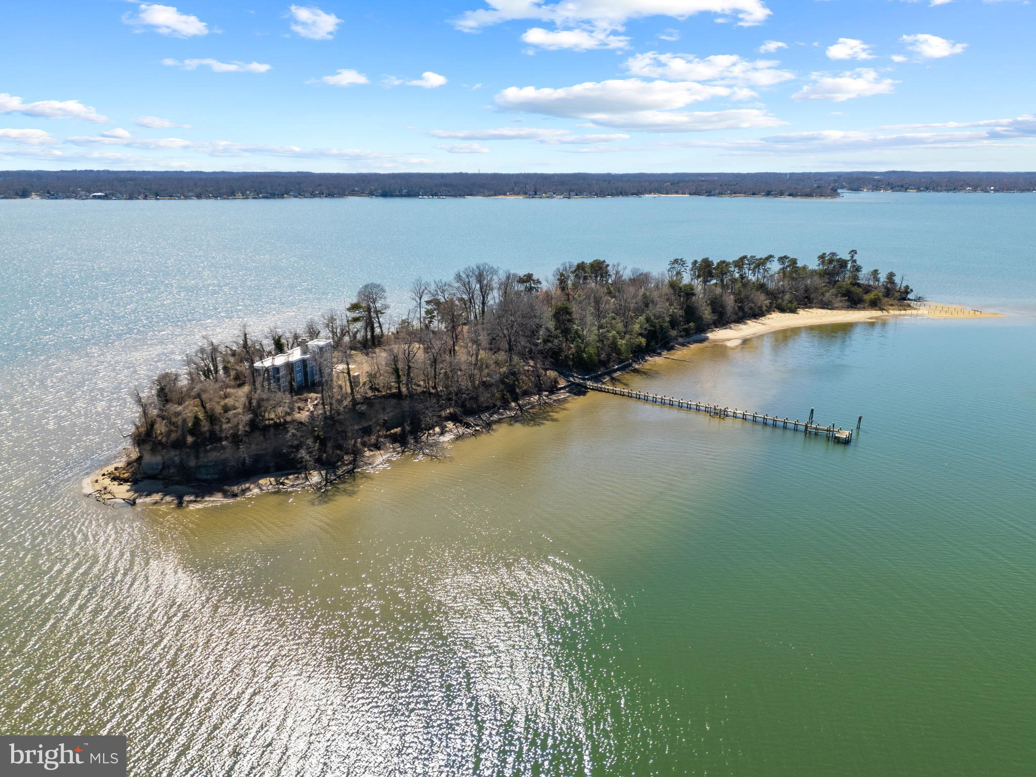 DOBBINS ISLAND!  Discover a once in a lifetime opportunity to own a private island retreat in the heart of the Chesapeake Bay region. The Magothy River's renowned Dobbins Island is a breathtaking 7.2 acre waterfront sanctuary, offering unmatched seclusion and stunning natural beauty. Accessible only by boat and just minutes from the mainland, this exclusive property is designed for those who seek a truly unique waterfront lifestyle. The newly constructed (2019), 4,000+ sq. ft. custom home features 3 bedrooms and 3 baths, complete with an elevator. It is thoughtfully crafted to highlight its spectacular 360 degree water views, extending from the Magothy River to the Chesapeake Bay Bridge. With a gourmet kitchen, multiple living spaces with fireplaces, soaring 10 foot ceilings, expansive windows, and ultra luxe finishes, the home seamlessly combines coastal elegance with modern luxury. The elevator provides easy access to every level, while various balconies and a rooftop deck create ideal spaces for soaking in sunrises, sunsets, and stargazing over the river. Outdoor living is truly exceptional, boasting over 4,000 feet of pristine water frontage, a private deep water dock with 8’ MLW for large boats, and a crescent shaped sandy beach perfect for swimming and sunbathing. A winding trail traverses the island’s scenic wooded ridges, where wildlife sighting... including ospreys, herons, and even a resident bald eagle, are part of everyday life. For added convenience, the property includes a dedicated private dock and parking on the mainland, ensuring seamless access to your island escape. An optional 2.5 acre waterfront parcel in North Beach is also available, presenting an opportunity to build an additional estate or guest retreat. Whether you’re fishing off the dock, sipping a glass of wine on the rooftop deck, or hosting unforgettable gatherings under the stars, Dobbins Island represents a once in a lifetime chance to own a legacy property that embodies the ultimate escape for enjoying waterfront living at its finest. Welcome Home!