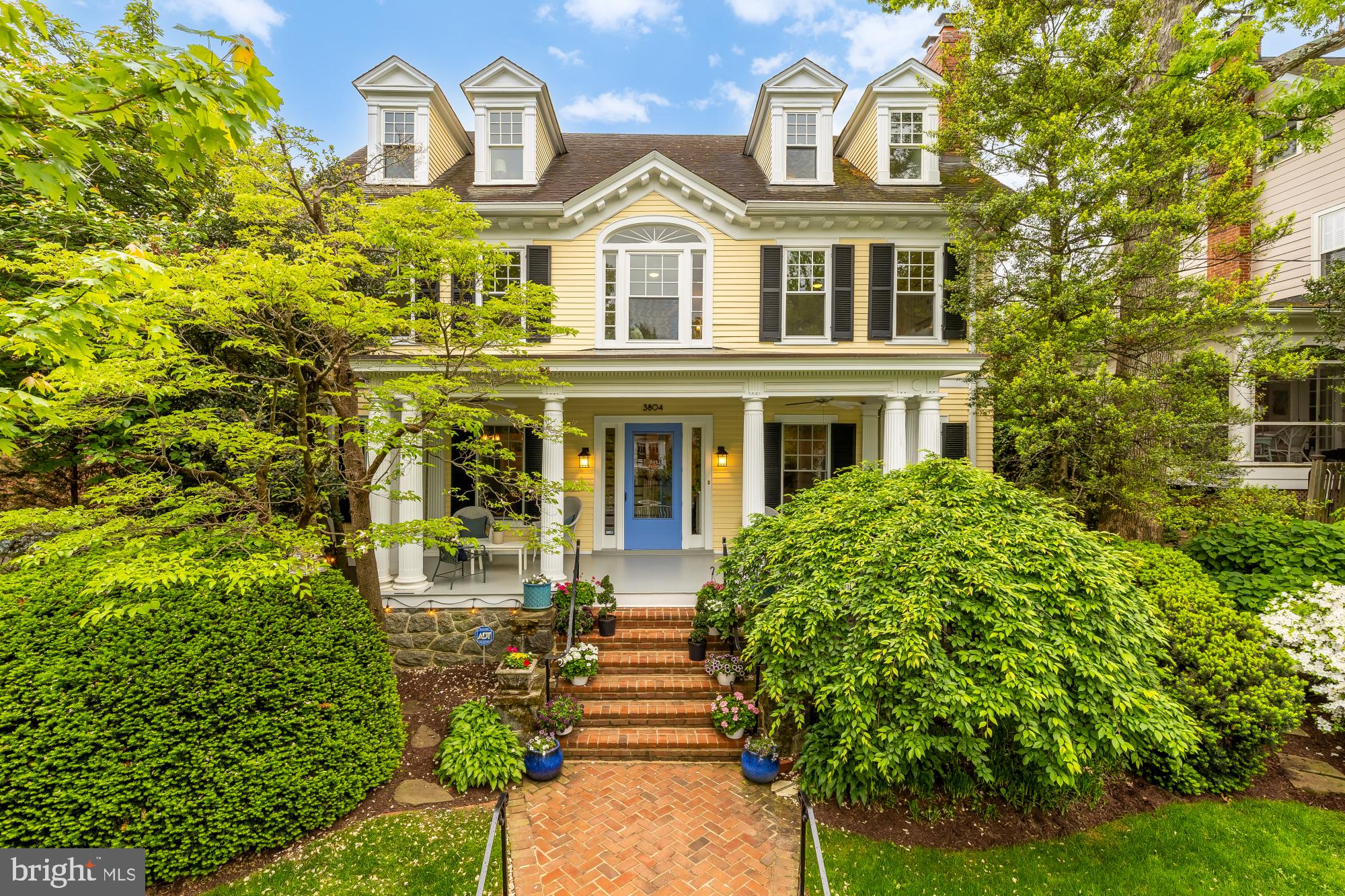 Welcome to 3804 Jenifer Street NW, a stately 1912 Adams Colonial Revival residence featuring a private elevator on one of Chevy Chase’s prettiest and most iconic streets. Designed by architect A.E. Landvoigt, who helped shape the neighborhood’s character, this historic block has long been part of Washington’s social fabric, once hosting evenings where President Truman played poker and frequented by figures like John Kerry and John Lindsay. Rich in legacy, the home embodies the grandeur and architectural distinction of classic Washington living. A gracious covered front porch with fans, original fluted columns with carefully restored bases, and Brazilian hardwood flooring introduces the home with timeless elegance. The entry door is framed by classic leaded glass, echoed by matching glass in the dining room. Inside, 9-foot ceilings, original dark oak floors, crown molding, custom wood radiator covers, and preserved millwork highlight enduring craftsmanship. The formal living room boasts a beautifully carved original mantle with pillars mirroring the porch columns, surrounded by elegant green marble. Solid oak pocket doors connect the living and dining rooms, creating spaces both open and intimate for entertaining.

At the rear, a stunning family room unfolds beneath 12-16-foot vaulted ceilings and dramatic floor-to-ceiling windows that flood the space with light. Built-in bookcases throughout the home add character and utility, including eight floor-to-ceiling cases in the family room/library. A distinctive sunburst window in the family room addition echoes the Palladian window at the front of the home, where a generous second-floor seating area overlooks the street. The adjacent kitchen is thoughtfully designed with white cabinetry, granite countertops, stainless appliances, glass tile backsplash, and a butler’s pantry. A laundry area sits conveniently off the kitchen hallway. French doors lead to a beautifully designed outdoor setting featuring a Trex rear deck, bluestone slate terrace with a dedicated gas line, fire pit, and a lush garden of hydrangeas. The landscaped backyard is fully enclosed for privacy with access to the shared alley beyond. Potential for easy off-street parking with a rear fence alteration. Spanning six bedrooms and 4.5 baths, the residence offers remarkable flexibility. The second floor includes three spacious bedrooms and two full baths, along with the large seating area beneath the Palladian window. The extra-large primary suite features a walk-in closet and a beautifully appointed en-suite bath with double sinks, a soaking tub, and a glass-enclosed shower. Two additional large bedrooms and a hall bath complete this level. The top floor provides two more bedrooms, a full bath, and large storage eaves.

The lower level includes a fully self-contained in-law suite with a private entrance, kitchen, living area, bedroom, and bath, ideal for guests or potential income. A standout feature is the large heated elevator added in 2022, servicing three floors (excluding the basement). Designed for accessibility while blending with the home’s architecture, it provides practical convenience for transporting suitcases, equipment, and accommodating guests. Recent improvements include a newly lined/rebuilt fireproof fireplace, a new gas boiler, all new windows, and an updated HVAC system, ensuring modern efficiency while preserving historic integrity. The setting offers outstanding walkability, with Metro access and multiple bus routes just moments away. Enjoy effortless proximity to the boutiques and dining along Connecticut and Wisconsin Avenues, as well as neighborhood institutions like Politics and Prose and an array of acclaimed restaurants. Throughout 3804 Jenifer Street NW, preserved architectural elements reinforce a historic pedigree while delivering the scale and comfort expected today. A rare opportunity to own a residence of such stature in on one of Washington’s most distinguished streets.