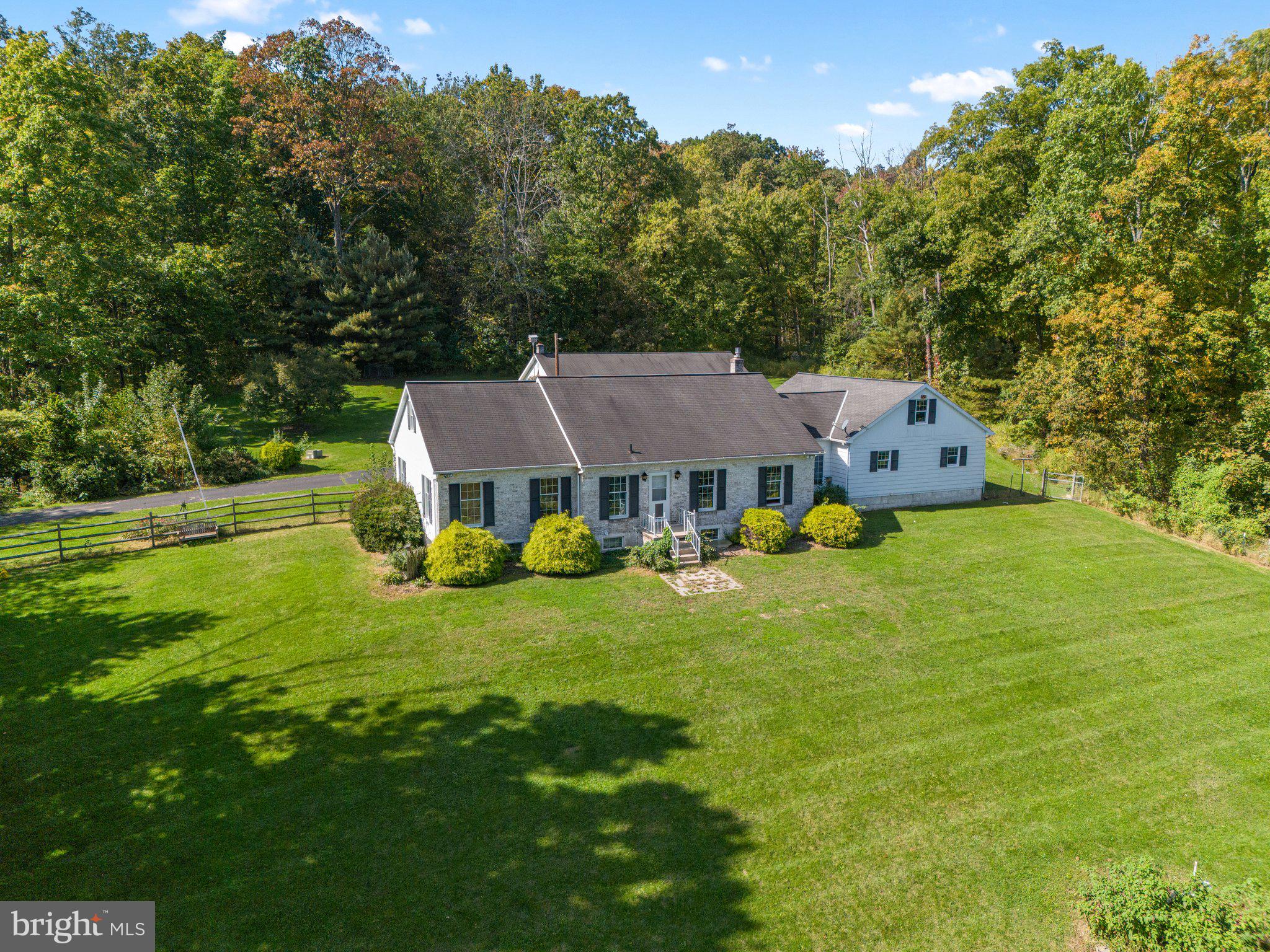 Expansive ranch home on 14 plus acres in Boyertown SD with full finished basement, two-car attached and four-car detached garages.  An efficient geothermal system heats and cools this six bedroom, two full bath property, with a large open living room and kitchen with extensive cabinetry and Corian counters.  The  spacious dining room has tile floors and is surrounded by windows. Three bedrooms and a large hall bath, which also has access to the main bedroom, complete the main level.  Great recreation space in the basement, highlighted with a propane stove with brick hearth and surround, along with three additional bedrooms (all have egress) and another full bath.  Much of the yard is level, and a good-sized area is fully fenced.  Six garage spaces along with the extensive driveway allow for large gatherings or car enthusiasts, all of this tucked into the mature natural landscape.