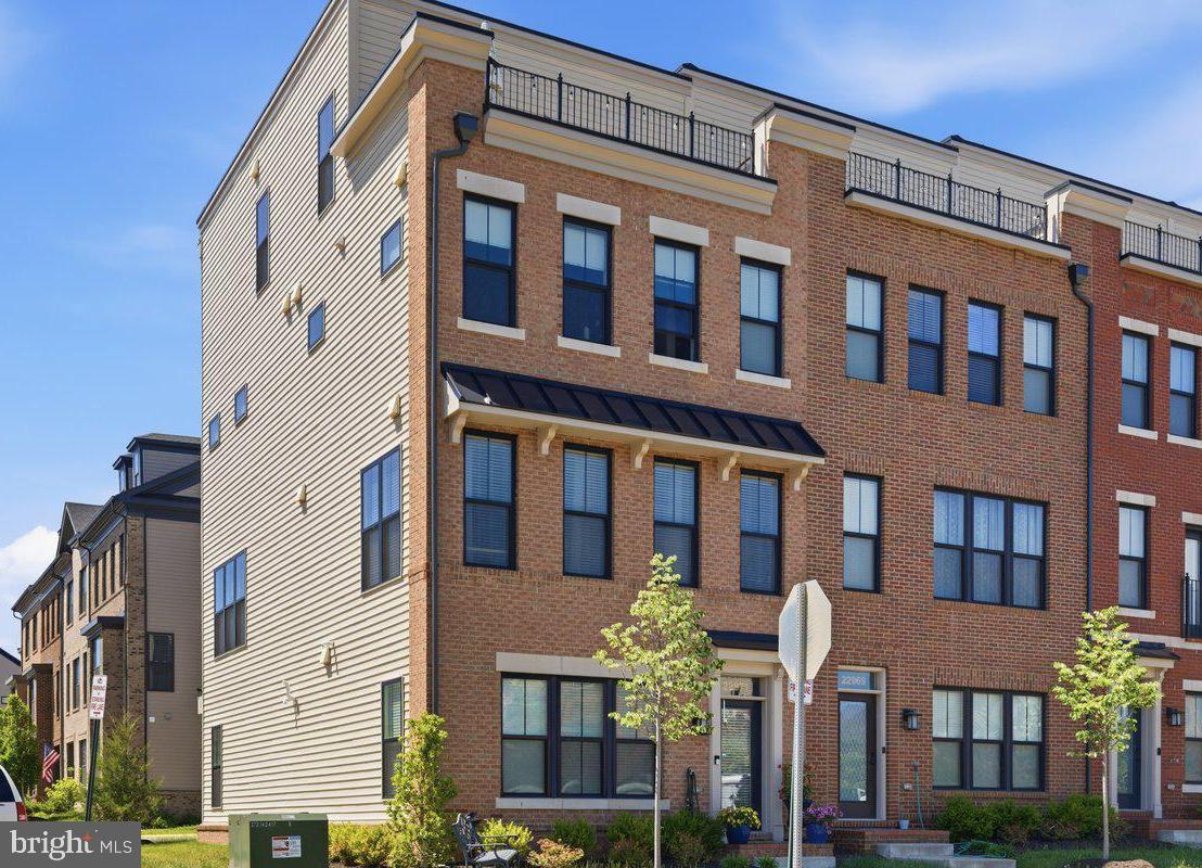 PREMIUM CORNER-LOT END UNIT! Perfectly positioned on a premium corner lot with park views, this stunning 4-level brick end unit townhome offers the privacy, natural light, and spacious feel rarely found in townhome living. East facing with approximately 2,756 square feet, 4 bedrooms, 3 full baths, 2 half baths, a spacious loft with a private rooftop terrace, and over $80,000 in upgrades, this home truly stands out.

Extra windows, only one shared wall, and open space surrounding the home create a bright, airy atmosphere that lives more like a single family home. The open-concept floor plan features high ceilings, a light filled living area with custom built-ins and a cozy fireplace, and a designer chef-inspired kitchen with extra cabinets and an oversized island perfect for entertaining and everyday living.

Upstairs, enjoy two spacious suites including a luxurious owner's suite featuring a large walk-in closet with a custom organization system and dual doors, and a desirable bump-out that creates the perfect space for a sitting area.  Across the hall is another spacious bedroom with large windows and it's own private full bath. This level also has a conveniently located laundry room adding everyday practicality. 

The top level expands your living options with an expansive loft with a custom bar/kitchenette, third bedroom and a full bath . From here, step onto the private rooftop terrace, an ideal setting for entertaining or relaxing under the stars.

Just steps from Brambleton Town Center, residents enjoy easy access to shopping, dining, and entertainment. And don't forget the amenities Brambleton has to over with 18+ trails, parks,  multiple pools, sports courts, and more. HOA dues include Verizon Fios internet, cable, and lawn maintenance.

Luxury, privacy, abundant natural light, and an unbeatable location, this is Brambleton living at its finest!