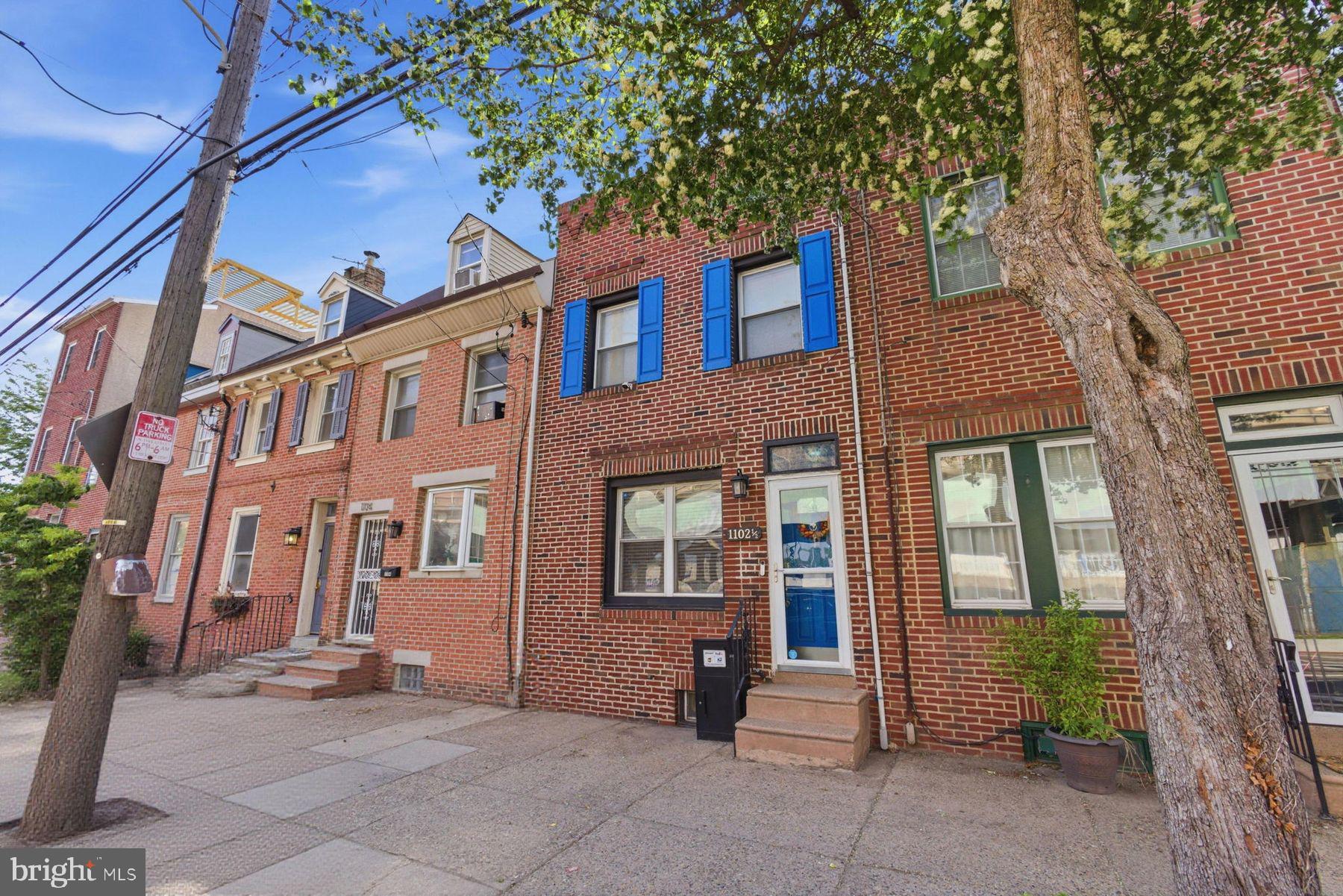 Positioned in the heart of Pennsport, this spacious and character-filled residence at 1102 1/2 South Front Street offers approximately 1,800 square feet of living space across multiple levels, blending classic Philadelphia charm with modern everyday functionality. Featuring three bedrooms, two-and-a-half bathrooms, and generously sized living areas, the home provides a flexible layout well suited for both entertaining and daily living. The main level welcomes you with warm hardwood flooring, an expansive dining area, and a thoughtfully designed kitchen with ample storage. This floor also features a convenient powder room and direct access to the outdoor patio, enhancing the functionality of the home. The outdoor patio is brand new and constructed with Trex decking, creating the perfect setting for grilling, entertaining, or relaxing outdoors. The second floor offers spacious bedrooms filled with natural light, complemented by vaulted ceilings and large windows that add character throughout the home. The additional third-floor bedroom features a private deck that enjoys abundant sunlight throughout the day. Additional highlights include conveniently located second-floor laundry, central air conditioning, and an unfinished basement offering excellent storage potential. Located just moments from Dickinson Square Park, the Delaware River waterfront, and some of South Philadelphia’s most beloved local restaurants, cafés, and shops, the property offers convenient access to both Center City and major commuter routes while maintaining the charm and neighborhood feel Pennsport is known for. Also positioned within walking distance to neighborhoods like Queen Village, Old City and East Passyunk. A convenient parking lot is also located right across the street from the home, a well-known and highly valued feature of the neighborhood that provides residents and guests with accessible everyday parking options. A rare opportunity to own a spacious Philadelphia home in one of the city’s most established and rapidly growing waterfront-adjacent neighborhoods.
