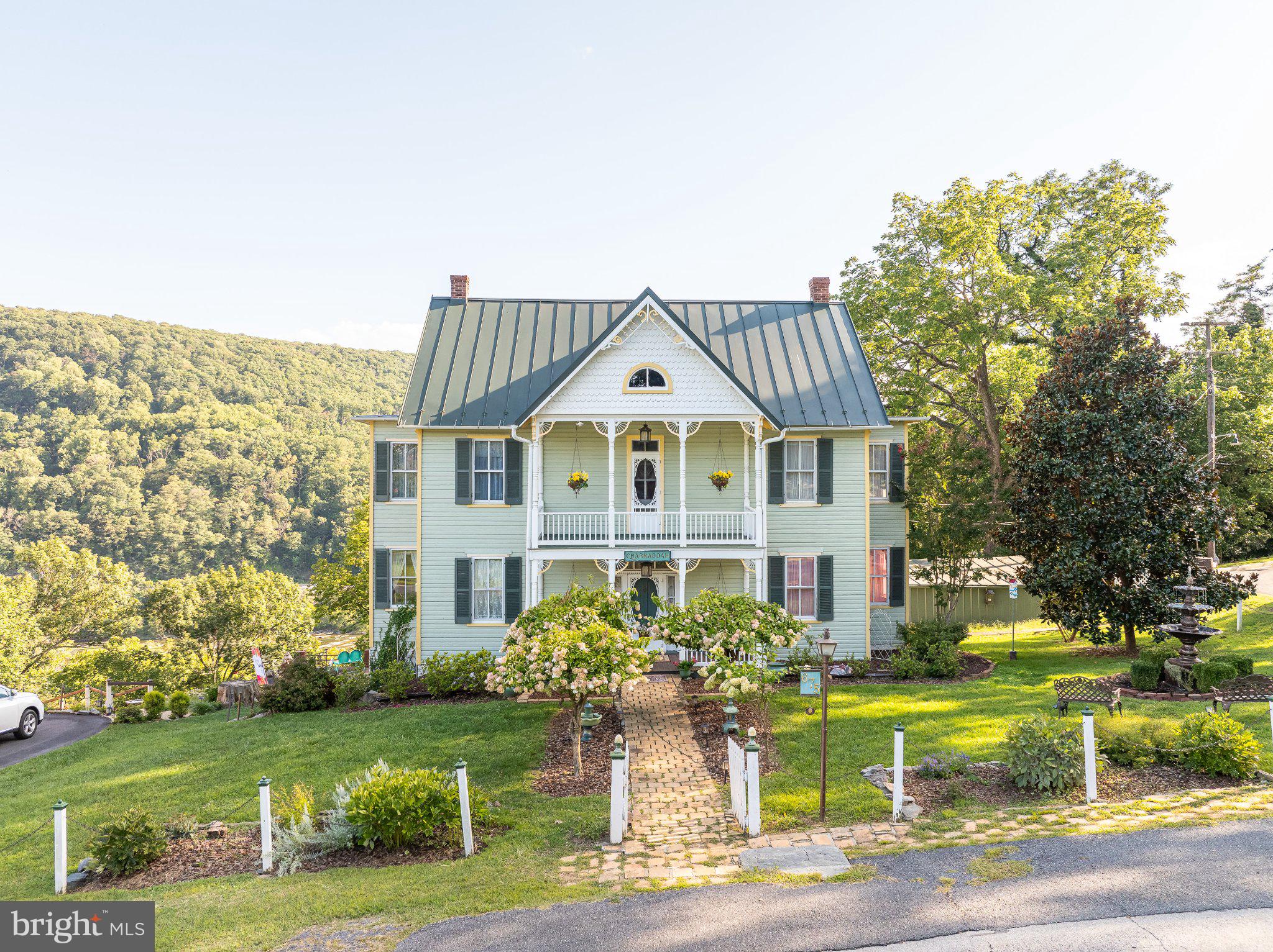 History charm and endless potential abound in this Historical Victorian located on an ideally situated mountaintop lot overlooking the rolling Shenandoah River in the delightful little historic town of Harpers Ferry, West Viginia. From every room a view of the Shenandoah River can be seen. Four-story house with four bedrooms, one full bathroom, two half bathrooms, double living room, dining room, kitchen and outside porches on the front and back Finished basement. Unfinished attic offers much potential for additional rooms. A separate small shed beside the house provides space for lots of storage. Patios offer spectacular views of the river and mountains.  The location is protected on all sides from creeping construction, facing the beautiful campus of Old Storer College.  Landscaping and view of the river are plentiful. Location within walking distance to everything in Harpers Ferry making it a desirable asset. House was built in 1890 with Victorian features, original German wood siding, walnut shutters, tin roof (2004), upgraded electrical wiring, and other recent upgrades. Move in ready.
